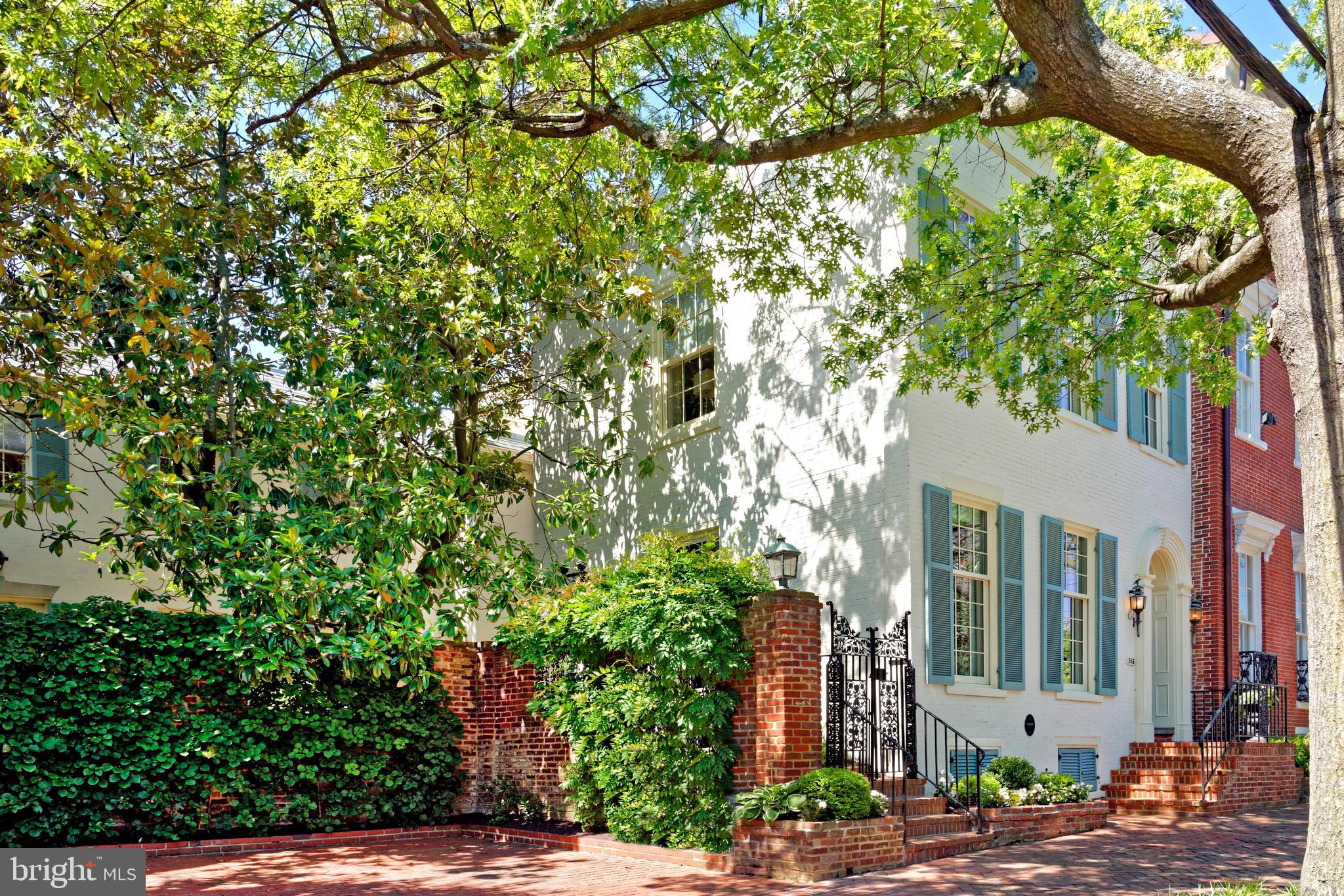 514-516 Duke St is a stately property built on two lots in 1840 with a Scenic and Open Space Easement.  Impeccably maintained and richly appointed, this historic gem boasts an elegant interior graced with three fireplaces, original heart pine floors, original moldings and wainscotting plus two staircases.  Original hardwood floors, tall dentil molding, and an antique bell jar light fixture greet you in the generous foyer transporting you into yesteryear. 
The arched doorway leads into the gracious living room boasting original floors, handsome millwork, and the focal point of a gas fireplace with a beautifully detailed mantel and slate hearth.  Four tall windows bring abundant light to this inviting living room. The regal dining room, adorned with a stunning mural of Kew Gardens outside London, original wainscotting, crystal chandelier, and French doors that open to the private side yard, sets the perfect tone for formal hosting.  The gourmet kitchen is finely appointed for the chef equipped with top-of-the-line stainless appliances, granite countertops and backsplash, large pantry, coffee station, island with seating and French doors open to the wonderful patio for private outdoor enjoyment.  It is the is the heart of the home with a spacious eat-in area with a gas fireplace, brick surround, and original mantel.  Gather together in the expansive family room offering hardwood floors, a custom built-in bookcase, and 4 windows allow for much natural light. A powder room is convenient for guests.
The second floor is occupied by three inviting bedrooms, two renovated baths and a laundry.   Also, a charming library with original floors offers a wall of custom built-ins and entertainment center and original plantation shutters. The primary bedroom features original hardwood floors, a beautiful chandelier, and a fireplace with an original mantel and brick hearth (non-working).  A luxurious marble en suite bath features a Hydro-systems tub and a seamless glass shower with a hand wand and toiletries nook.  The second bedroom offers original hardwood floors, custom millwork, his/her closets, and a separate desk/make-up area.  The third bedroom with hardwood floors and large closet is an ideal guest retreat.  A renovated second full bath boasts a large vanity with tall cabinetry, a seamless glass shower with a seat and a hand wand and Perrin & Rowe fixtures.  The upper hallway is adorned with hand painted wall coverings of the Royal Parks particularly Kensington Gardens in London.  
The lovely garden and patio are spacious and private featuring wrought iron and brick fencing, a mature magnolia tree, pots with irrigation, climbing hydrangeas, and additional plantings.  Two off-street parking spaces convey.