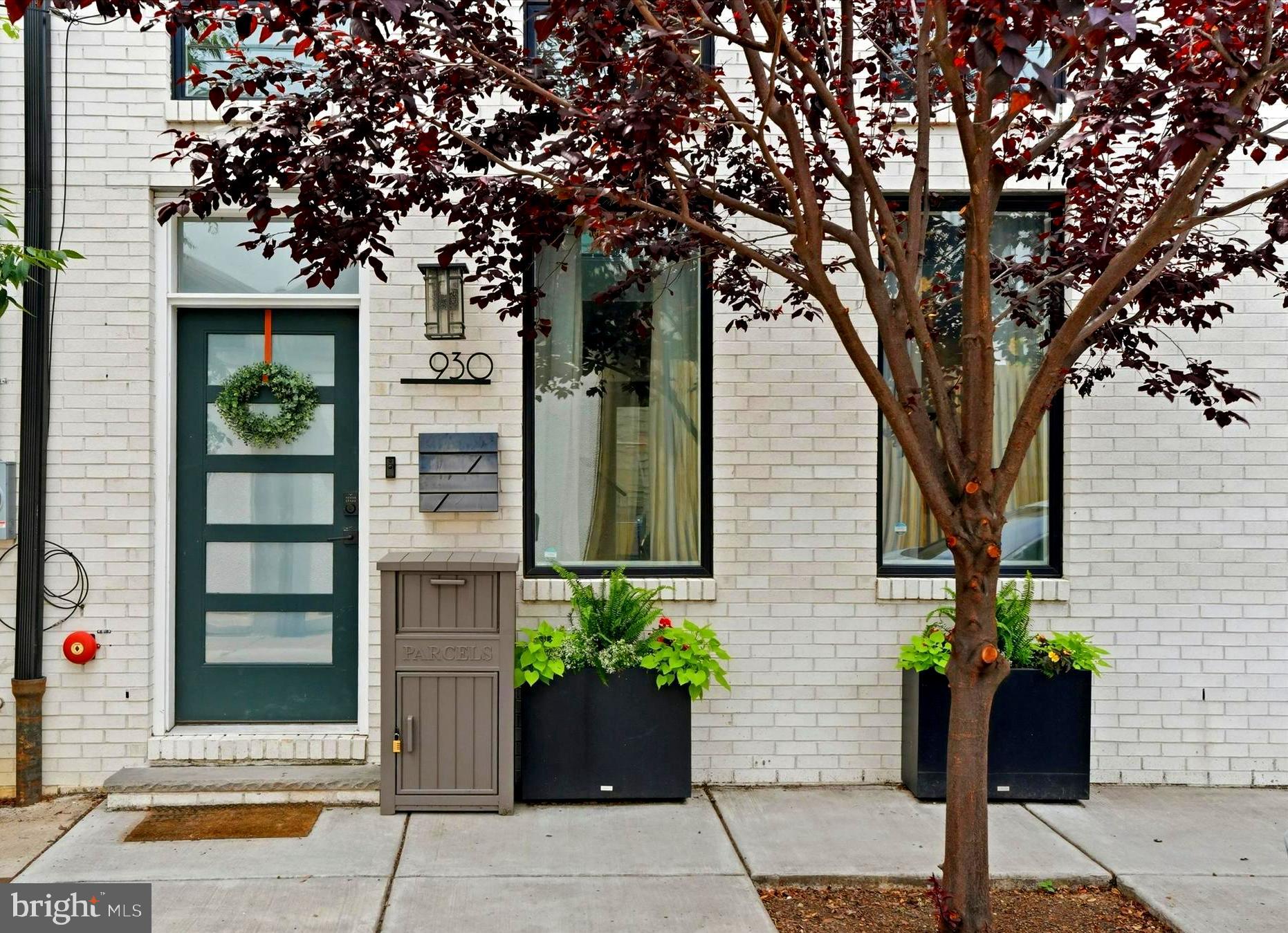 Welcome to 930 S. Beulah Street, a rare 22-foot-wide residence in the heart of Bella Vista. Built in 2022 and offering more than 2,800 square feet of thoughtfully designed living space, this home sits just one block from the Italian Market in one of Philadelphia’s most desirable neighborhoods. Parks, restaurants, coffee shops, grocery stores, and some of Center City’s best dining and entertainment are all within easy walking distance.  The dramatic main living level is defined by timeless architectural details, including a floating staircase, soaring two-story ceiling, wide-plank walnut flooring, and a spacious chef’s kitchen with an LG Signature appliance suite. Five oversized, custom front-facing windows fill the home with natural light, while two additional rear windows overlook the private patio. Oversized French doors provide seamless access to the outdoor space.  The 2nd-floor loft overlooks the living room below and benefits from the abundant natural light via the home’s front windows. Beyond the loft is a generously sized guest bedroom with a private en suite bathroom.  The 3rd floor offers two additional guest bedrooms, each with its own en suite bathroom. Between the bedrooms is a large, open library or flex space with custom built-in shelving. A separate laundry room features high-end LG front-loading washer and dryer, custom cabinetry, and a utility sink.  The entire 4th floor is devoted to the Primary Suite. The oversized bedroom easily accommodates a king-size bed and still provides ample room for a sitting area. Two walk-in closets with custom built-in storage offer exceptional organization. The spa-like Primary Bathroom includes dual vanities, a dedicated makeup counter, a separate water closet, and an expansive shower with a triple-head spray system.  Just outside the primary bedroom is a wet bar w/custom shelving, a sink, and beverage refrigerator. A glass door opens directly onto the roof deck, which offers a distinctive view of the historic St. Mary Magdalen de Pazzi Church right next door.  Additional features include Andersen 400 Series windows throughout, solid-core interior doors, tankless water heater, dual-zone HVAC system, glass railings, wide-plank walnut floors, abundant natural light, and high-end appliances. Almost seven years remain on a full 10 year tax abatement. This home offers four bedrooms, each with a private en suite bathroom, as well as a conveniently located powder room on the main level.  Parking is readily accessible, with two free municipal lots nearby and on-street parking typically available on the block.  Please join us at the Premier Open House on July 9th from 5 to 7 p.m.