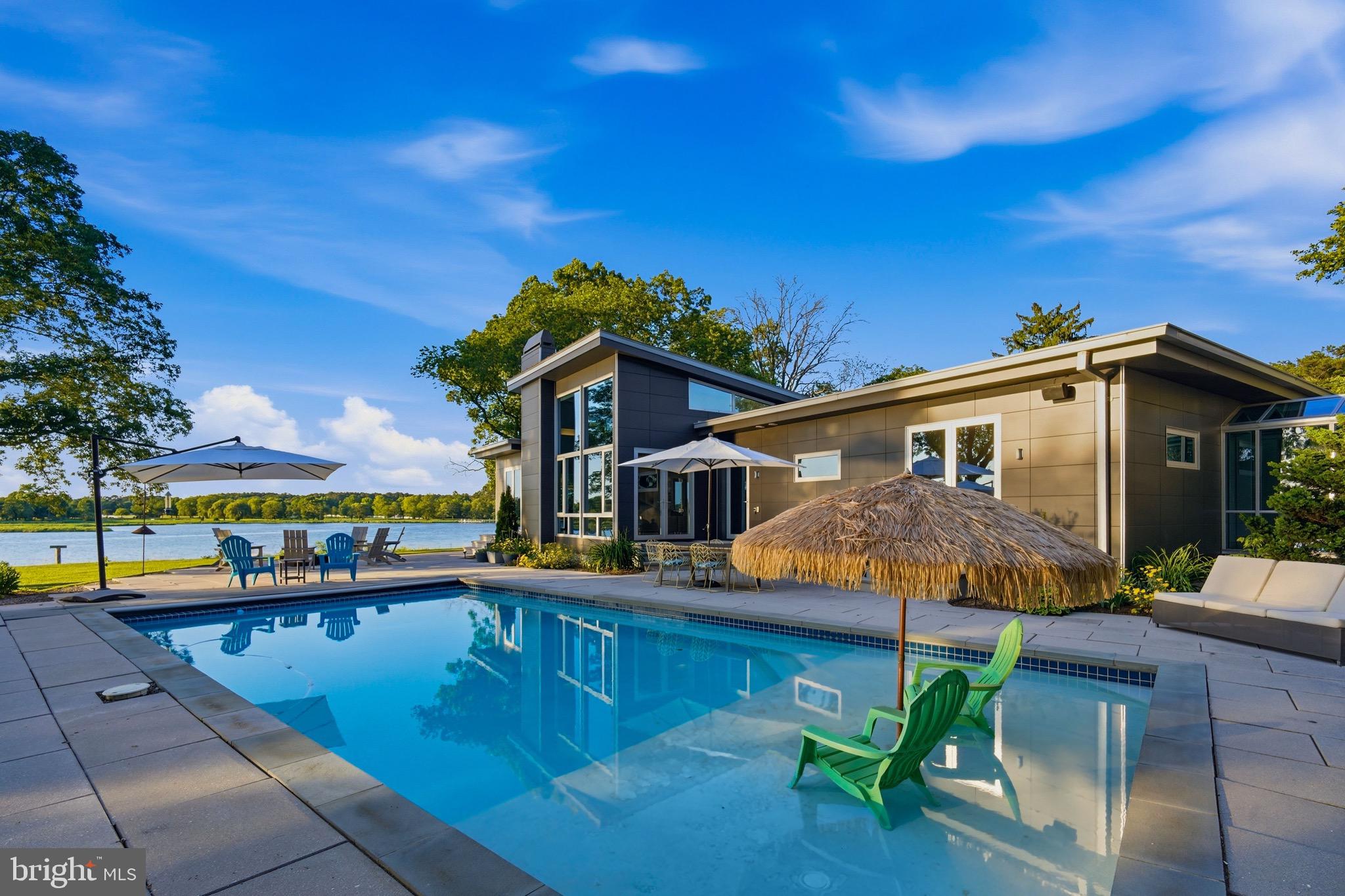 Coming soon. A unique offering on Maryland’s Eastern Shore, this architect-designed contemporary home sits on nearly 18 private waterfront acres across 2 parcels with 1,400 feet of shoreline along sought-after Greenwood Creek. Thoughtfully designed for seamless indoor-outdoor living, the home features floor-to-ceiling windows, open entertaining spaces, a chef’s kitchen, home theater, billiards room, workout room, and multiple fireplaces. The private primary suite is connected by a glass-enclosed walkway and includes an office, spa-inspired bath, and expansive dressing room. Outside, enjoy a solar-heated pool, private beach, pier with two boat lifts, and protected, western-facing water views stretching in every direction. The property also includes a three-bay outbuilding with workshop and additional storage. Located within easy reach of Easton, Annapolis, Washington D.C., Baltimore, and Philadelphia, this is a truly exceptional waterfront retreat offering privacy, nature, and the very best of Eastern Shore living.