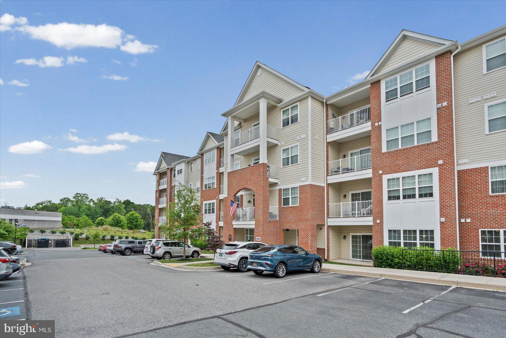 This thoughtfully designed  2 Bedroom and 2 Full Bathroom first-floor condo in the highly desirable Overlook at Gateway community offers easy, accessible living while backing directly to the scenic Ma & Pa Heritage Trail. Located in a secure building with controlled access, this home includes a private garage parking space with direct building access.  You’ll never have to worry about snow cleanup on your car or exterior areas. The bright, open-concept layout features 9-foot ceilings, elegant crown molding throughout, durable LVP flooring, and consistently low electric bills. The well-appointed kitchen includes 42" maple cabinets with soft-close hardware, under-cabinet lighting, stainless steel appliances, beautiful quartz countertops, and a stylish subway tile backsplash. The living area flows seamlessly to a private patio through an upgraded Andersen storm door with a built-in screen. The owner’s suite offers a generous walk-in closet and an upgraded primary bath designed with accessibility in mind: it features a low-curb shower pan with a built-in bench, grab rails in the shower and bathroom, an enhanced shower head, and a full tile-to-ceiling enclosure. The unit also includes audible fire alarms for added safety and peace of mind. Additional conveniences include in-unit laundry, neutral paint throughout, and custom blinds. A fire sprinkler system provides further security.
Building amenities include a secure mailroom and double elevators.  Just steps from your new unit, there is a well-equipped exercise room, and clubhouse ideal for larger gatherings. This home is part of a well-maintained 55+ community where water is included in the HOA fee, making ownership simple and low-maintenance.
Enjoy convenient access to walking trails, shopping, dining, and everyday amenities in this desirable location.