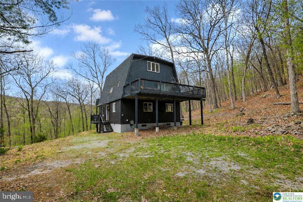 Nestled on a beautifully situated lot with breathtaking mountain views, this unique home offers space, charm, and versatility across three thoughtfully designed levels. From the moment you arrive, you’ll appreciate the serene setting and the rare opportunity to enjoy nature right from your doorstep. The first floor features two comfortable bedrooms, a convenient half bath, and a laundry area, along with a spacious family room perfect for everyday living or hosting guests. Upstairs on the second level, you’ll find the heart of the home—a stunning, oversized family room complete with a cozy fireplace, ideal for relaxing or entertaining. This level also includes a dining room, a beautifully remodeled kitchen, a full bath, and access to a large deck where you can take in the incredible mountain views off of the large family room. Off of the dining room you will find another very large deck. The third floor offers a private retreat with an extra-large bedroom and a generously sized bathroom, creating the perfect space for relaxation and privacy. With three decks throughout the home, you’ll have multiple places to unwind, entertain, and enjoy the peaceful surroundings. This property is truly a rare find, combining scenic beauty with functional living space. STR friendly and all furniture included nothing to do but move in!