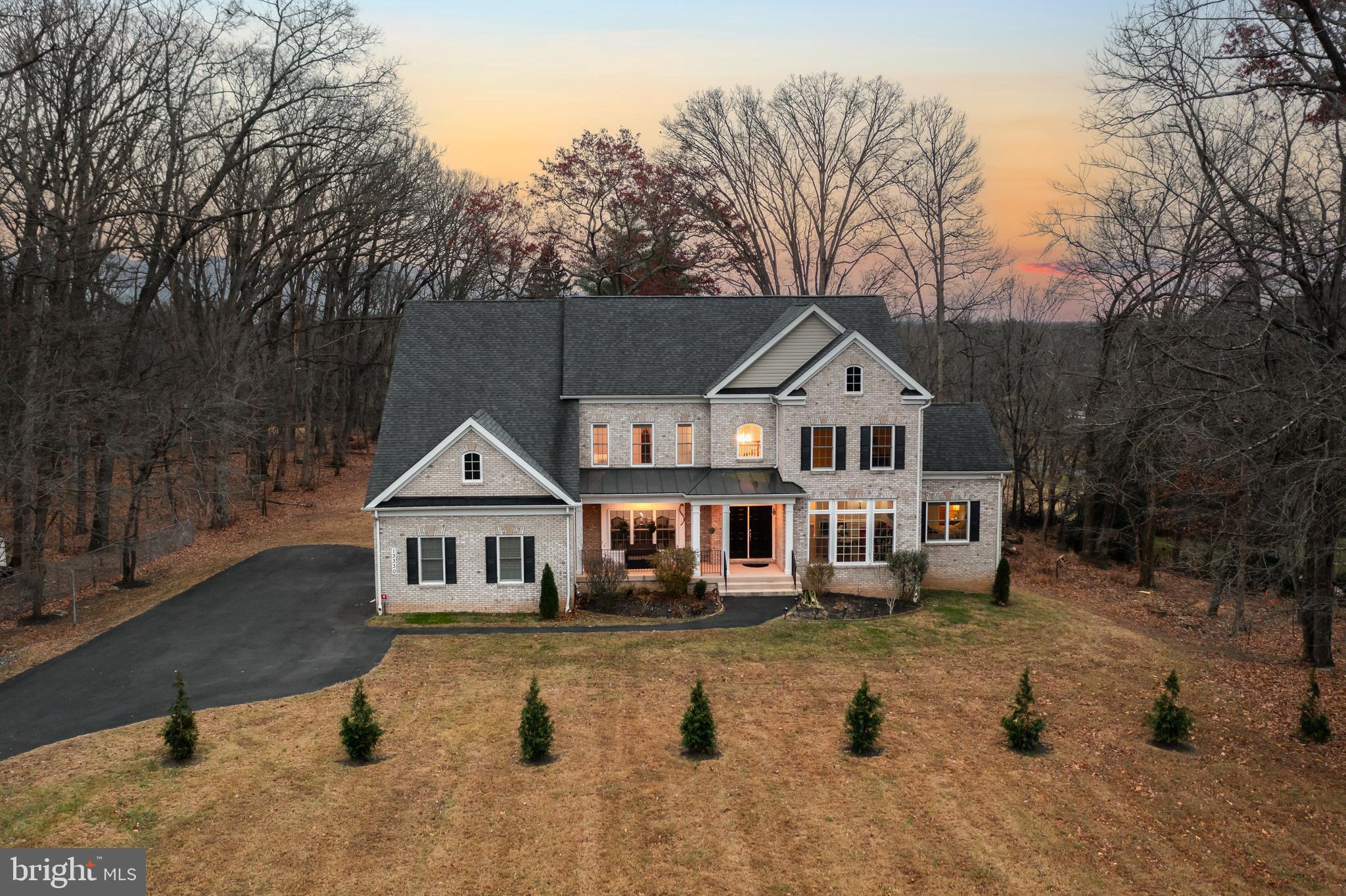 Refined Custom Living on 1.16 Private Acres
This home is discreetly positioned well off the main road, ensuring total privacy with it's own secluded driveway, 13330 Darnestown Road is a custom-built, elevator-ready residence by REEL HOMES, offering exceptional craftsmanship, modern technology, and true multi-generational flexibility across 1.16 secluded acres.
The stately entry opens to a thoughtfully designed main level featuring a formal living room with a fireplace, an elegant dining room, and a gourmet kitchen appointed with granite countertops, a butler’s pantry, and GE Profile stainless steel appliances. The kitchen flows seamlessly into the dramatic double-height family room, where soaring ceilings and abundant natural light create a striking yet inviting space for everyday living and entertaining. A main-level bedroom suite with en-suite bath provides ideal accommodations for guests or extended family, complemented by a private home office.
Upstairs, the primary suite serves as a private retreat with a luxurious en-suite bath, jetted tub, and a cozy three-way fireplace. Three additional bedrooms and a dedicated laundry room complete the upper level.
The fully finished, walkout lower level is designed for versatility and entertaining, offering a kitchenette, professional office, bedroom, full bath, and recreation room with a fireplace. A dedicated theater room with a 154" diagonal projector screen is a true highlight, while existing rough-in plumbing allows for easy conversion to a two-bedroom in-law suite or expanded workspace.
Built with steel beam construction and a three-car garage, the home delivers quality, comfort, and peace of mind with smart thermostats and a comprehensive security system. Convenient access to Washington, D.C. (bypassing I-270) and close proximity to MARC and Metro complete this rare offering that blends privacy, luxury, and practical design.