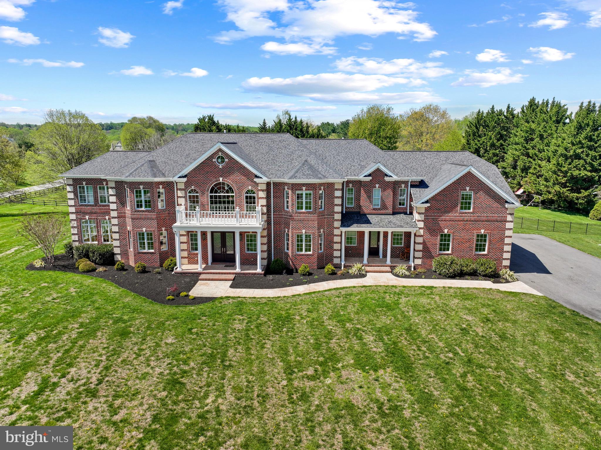 Welcome to 1820 Woodstock Road, where grandeur meets everyday livability. A masterpiece of scale and craftsmanship, this exceptional estate custom-built in 2020 is where over 13,000 square feet of exquisitely finished living space with resort-style amenities come together in a truly impressive luxury offering. The distinguished property is set on three acres, approached by a long driveway and complemented by professionally-designed landscaping and picturesque, scenic views. This home embodies luxury living, elevated in every detail. 

The interior presents 11,380 finished square feet across three levels, with luxe finishes, expansive spaces, and refined craftsmanship throughout. Inside, a breathtaking two-story foyer with marble floors and dual staircases sets an impressive tone. Rich hardwoods, sundrenching windows, intricate millwork, and the finest of finishes flow throughout the elegant interior. The formal living room with French doors and bay windows seamlessly leads to a stunning conservatory with coffered ceilings and panoramic windows. Opposite, the refined dining room boasts bay windows, wainscoting, and a tray ceiling with chandelier, while a private study with a walk-in closet and dual-entry access to a full bathroom adds both flexibility and functionality as a potential main level in-law suite.

The soaring two-story great room has columns, exposed beams, a floor-to-ceiling stone fireplace, and a wall of windows flooding the space with natural light. The chic sitting room has French doors that lead to the patio and pool area, accompanied by the nearby butler’s pantry with a bar area, and the stylish spa-inspired powder room. These spaces are wonderfully curated for effortless and enjoyable hosting and gathering. The incredible kitchen is equipped for everyday living and elevated entertaining with Sub-Zero® and Wolf® appliances, a pot filler, built-in hood, island with breakfast bar, walk-in pantry, abundant ceiling-height cabinetry with lighting, gorgeous counters with plenty of prep space, and designer pendant lighting. A breakfast bar connects the bright breakfast room overlooking the pool and yard. A well-appointed mudroom offers built-in cubby storage and convenient exterior access. 

Upstairs, the opulent primary suite is a true retreat complete with a private sitting room, gas fireplace, built-ins, beverage bar, private balcony, three walk-in closets, and spa-inspired bath with a soaking tub, dual vanities, oversized shower, and two water closets. A connected private bonus room is an ideal space for a nursery, dressing room, or office. Three additional bedrooms—each with an ensuite bath and a walk-in closet—along with a laundry room, complete the upper level.

The lower level unfolds as a dynamic, amenity-rich living space with LVT flooring throughout, a huge rec room with a full bar, a true home theater, game room, fitness or bonus room, bedroom with walk-in closet and dual-access full bath, versatile bonus space, and ample unfinished storage. Outdoors is equally captivating—boasting an expansive patio with a fully-equipped outdoor kitchen centered around a heated saltwater Roman pool. The surrounding patio extends to a gazebo ideal for al fresco dining, complemented by a gas fire pit and set within a sprawling, beautifully-landscaped, tree-lined backyard with a resort-style setting. Enjoy garage parking for 6 cars in an attached 4-car garage and detached 2-car garage.

This desired address in Howard County’s sought-after Marriotts Ridge School District offers a rare balance of refined countryside tranquility and seamless access to major commuter routes, top-ranked schools, and cultural and business hubs of Baltimore and Washington, D.C. Surrounded by rolling landscapes and preserved natural beauty, it delivers an elevated lifestyle defined by convenience, privacy, and prestige. Architectural Excellence, Thoughtfully Executed...rarely will you see an opportunity or property like this.