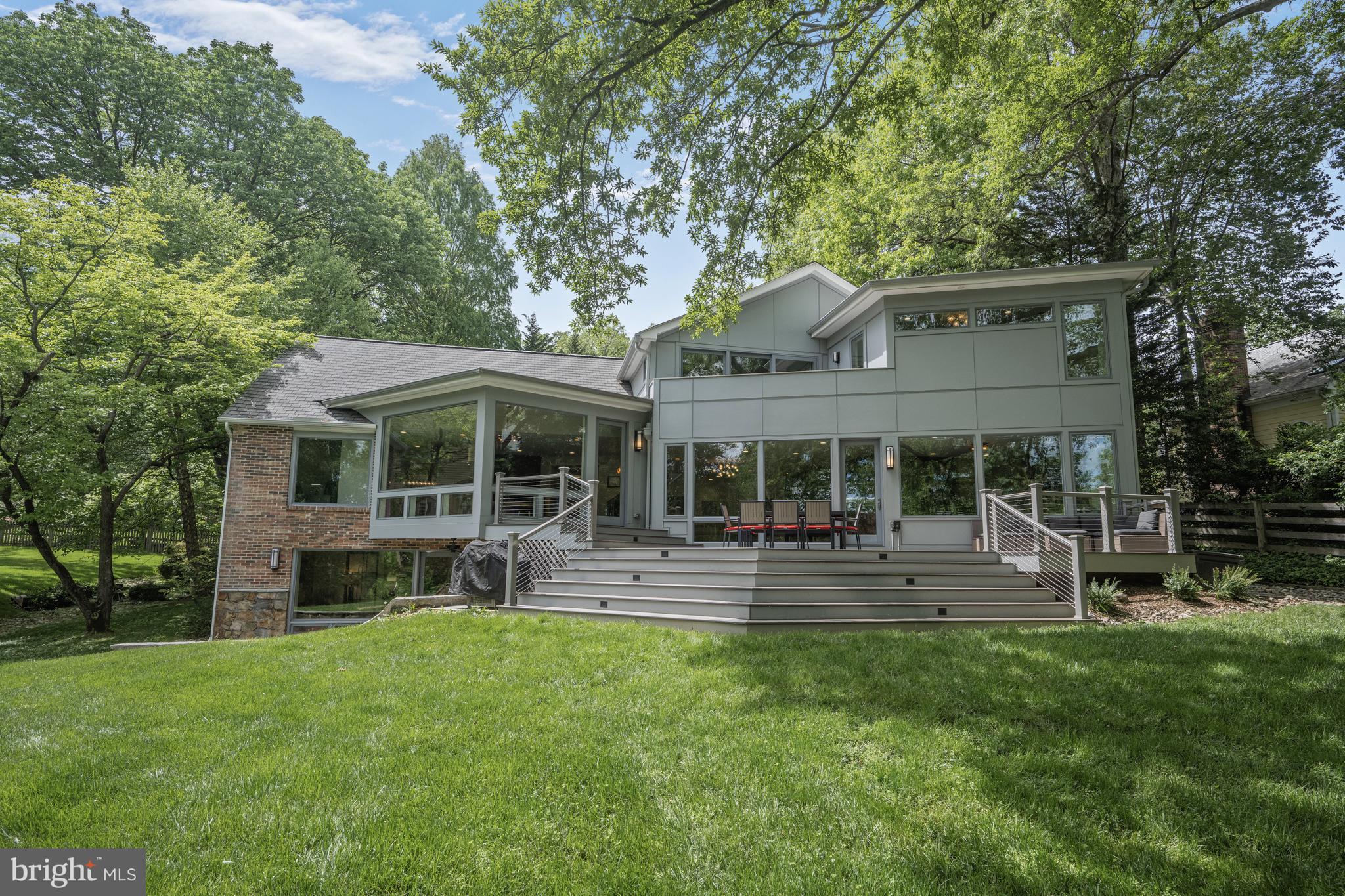 OFFER DEADLINE TUESDAY, MAY 13, 3:30PM. SELLERS RESERVE THE RIGHT TO ACCEPT AN OFFER PRIOR TO THE DEADLINE.
YES, an ACRE abutting PARKLAND in Chevy Chase INSIDE THE BELTWAY, and with a gorgeous house, too! Set down the driveway and privately tucked away from the street, this Williamsburg colonial has been beautifully reimagined, expanded and fabulously renovated by the current owners, with walls of windows that overlook the amazing lot and the parkland beyond. Featuring a lovely open design and situated to take advantage of the beautiful views, the home includes approximately 4,900 square feet of finished space over three levels. The covered front porch opens to a foyer which looks through the home and to the grounds, and to a main level with a phenomenal chef’s kitchen, with breakfast area, walk-in pantry and office nook, that is open to a large living/family room with gas fireplace and the spacious dining room. A separate office with walls of windows is also on this level, along with the mud room, powder room, laundry room and the attached two-car garage. An open stairway leads to the second level with five bedrooms (the fifth is accessed via a skylit bridge!) and three full baths. The fabulous primary has a private balcony and spa-like bath, all with amazing vistas, and a walk-in closet. The lower level includes a recreation room, a sixth bedroom with a walk-in closet and a large full bath - truly a second primary suite behind private doors that is perfect for visitors and in-laws - and an expansive storage room that is an ideal candidate for future expansion if desired. The gorgeous lot, which walks out to the Rock Creek Trail, offers possibilities to be explored - perhaps a pool, tennis or sports courts?  The centralized location provides proximity to downtown Bethesda and DC, and to Baltimore and Virginia via the Beltway. The access to shopping, transportation, parks and schools is hard to beat. The fabulous retail of the recently developed Chevy Chase Lake, other nearby shops, and the soon to arrive Purple Line are within walking distance. The metro, shops and restaurants of Bethesda are also close. In addition to Rock Creek Park, area residents enjoy the grounds of Nature Forward (formerly the Audubon Society), the fields and playgrounds of Candy Cane City, and Meadowbrook Stables. Neighborhood bonuses include North Chevy Chase Elementary and the fabulous North Chevy Chase Swimming Pool Association. NCCSPA membership is available by application and offers three pools, swim and diving teams, plus year-round tennis, social activities, community events, and more. This is the perfect location for those who love the connection with nature but desire the conveniences of the city close at hand. This spectacular private retreat is a singular opportunity - don’t miss it!