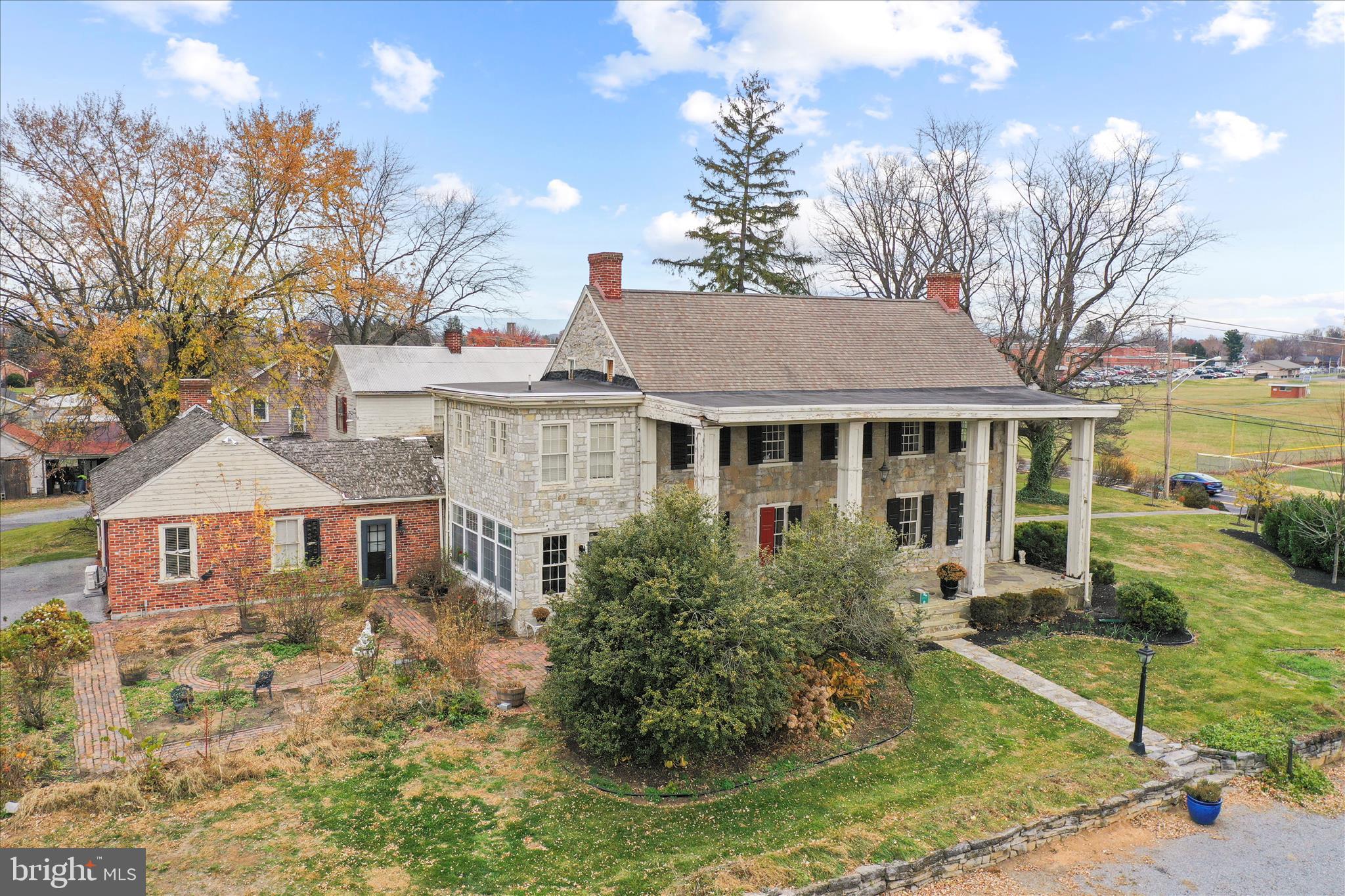 Welcome to the Mitchell-Shook House, a distinguished piece of Greencastle history dating back to circa 1783. This stately stone manor home blends timeless architecture with modern amenities, offering an exceptional living experience on a beautifully landscaped 1.5-acre lot.
Boasting 5 bedrooms, 3.5 baths, and an abundance of period charm, including eight fireplaces that bring warmth and ambiance to nearly every living space. You'll find hardwood floors throughout, exuding warmth and character in every room. The main level features a spacious family room, elegant living and dining rooms, a private library, bright sunroom, kitchen, laundry, and a bedroom with full bath—perfect for guests or multigenerational living. 
Upstairs, you'll find four generously sized bedrooms and two full baths, including a spacious primary suite.
An attached guest house—complete with 1 bedroom, 1 full bath, a kitchen, and living area—offers incredible potential for in-law accommodations, a rental unit, or private studio. Updates to drywall, plumbing, and electrical are needed, giving you the opportunity to tailor this space to your vision. 
Outdoors, enjoy the central courtyard, a covered porch with retractable screens, and mature landscaping—an entertainer’s dream or a quiet retreat. A convenient on-site well system is perfect for irrigating gardens, power washing sidewalks, and other outdoor tasks. The property also includes two 2-car garages (4 car total), ideal for car collectors or hobbyists.
Prime location near I-81, local amenities, and directly across from Greencastle-Antrim Schools. 
Own a piece of Greencastle’s legacy in a home that honors the past while embracing the present. Schedule your showing today!