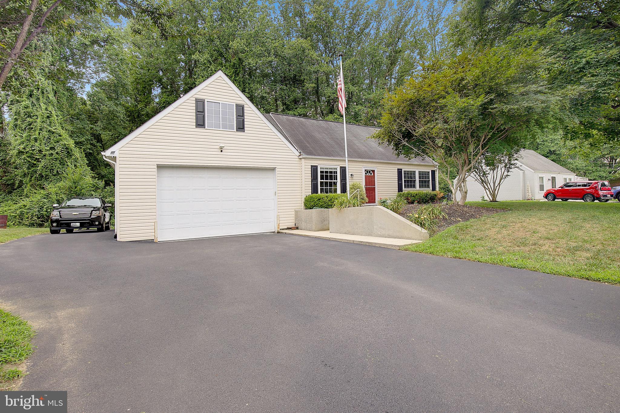 A CAR LOVER'S DREAM! This charming Cape Cod offers an incredible FOUR-CAR ATTACHED TANDEM GARAGE complete with a CAR LIFT THAT CONVEYS—plus additional paved parking beside the garage in addition to the driveway! Whether you're a car enthusiast, collector, hobbyist, or simply need exceptional garage and workshop space, this property is a rare find. A convenient rear entry door provides direct access to the backyard. Inside, you'll find four bedrooms and two full baths with a flexible floor plan featuring two bedrooms and one full bath on the main level, plus two additional bedrooms and a second full bath upstairs. The main level offers a comfortable living room and an eat-in kitchen/dining area with stainless steel appliances, built-in microwave, dishwasher, tile backsplash, maple cabinetry, and LVP flooring throughout the kitchen and living room. Sliding glass doors lead to a large rear deck overlooking the .28-acre yard, which backs to woods for added privacy. Best of all, you're just a 7-MINUTE WALK to the community beach, picnic area, and Chesapeake Bay access! Enjoy a convenient Prince Frederick location close to shopping, restaurants, the hospital, and movie theater, with approximately a one-hour drive to Washington, D.C., and Joint Base Andrews. A unique opportunity offering the perfect combination of garage space, flexible living, outdoor enjoyment, and Chesapeake Bay lifestyle!