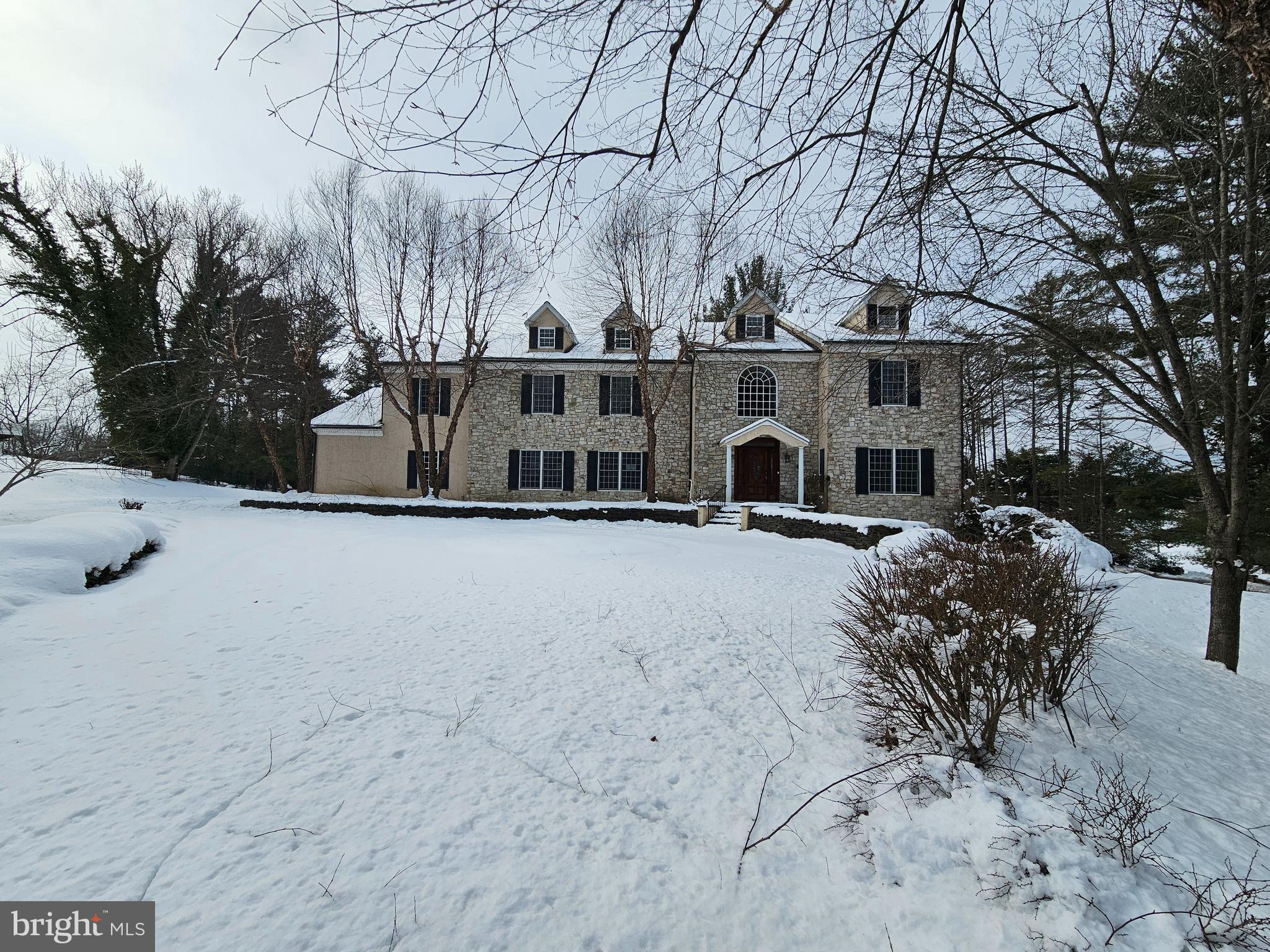 Nestled on prestigious Dunminning Road in sought-after Newtown Square, this impressive residence blends timeless architecture with exceptional living space and an unbeatable location.

A dramatic marble-tiled foyer with soaring ceilings and exquisite millwork sets the tone upon entry. Expansive windows flood the home with natural light, highlighting the engineered hardwood flooring and refined finishes throughout. A motorized chandelier adds both elegance and practicality, reflecting the thoughtful details that define this home. Dual staircases enhance both flow and function.

The property offers 5 bedrooms and 5 full baths, plus 2 powder rooms. Four bedrooms are located on the main level, each with access to full baths, including a spacious primary suite featuring a sitting area, generous walk-in closet, and a luxurious en-suite bath designed for relaxation. Each additional bedroom offers its own private bath, providing comfort and privacy for family and guests.

The main level includes an elegant sitting room with wood-burning fireplace, tray ceiling, and deep crown moldings overlooking the front grounds. A gracious dining room flows from the gourmet kitchen, complemented by a cozy family room/den and a spacious private office. The chef’s kitchen is equipped with premium appliances, including a double Fisher & Paykel refrigerator/freezer, dual dishwashers, a dual-fuel Kenmore range, and a large center island ideal for gatherings.

The finished walkout lower level provides exceptional flexibility, including a private in-law/guest/au pair suite with full bath, along with multiple additional finished spaces that could serve as recreation areas, fitness rooms, media space, or potential additional bedrooms.

Exterior features include a private enclosed rear yard, circular driveway with ample parking, and an oversized 3-car attached garage. The attractive composite faux slate roof enhances curb appeal. Notably, this is the only property on the street connected to main gas service, featuring three separate zones for efficiency and comfort.

Conveniently located near top-rated public and private schools, with no HOA restrictions, this property offers refined living in one of the Main Line’s most desirable settings.

Corporate Sale: Property is being sold as-is. This is a corporate-owned property. Seller does not accept PAR agreements. Required corporate addenda and contract documents will be uploaded within 24 hours and must accompany all offers.