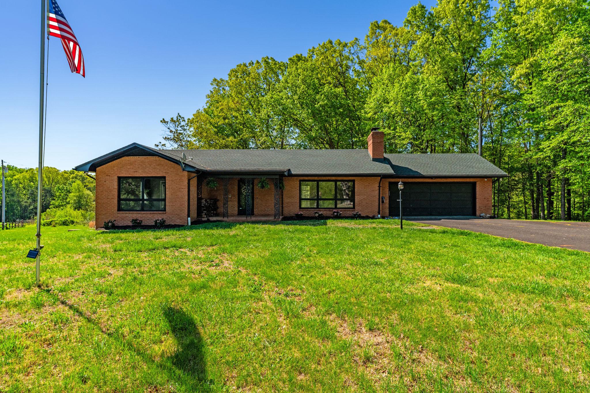 Price Improvement! Private  and Updated 3.54 acre Modern Homestead with High Speed Xfinity Internet! This expansive 4 bedroom and 3 full bathroom ranch style home offers over 3000sf  of main and lower level living designed for modern comfort in a rural environment. Rare for country living, this home features high speed internet and home delivery services such as Walmart and Target making remote work a breeze. This home offers a perfect blend of comfort and functionality. The sun drenched floor plan features new luxurious vinyl plank flooring, plush carpeting, and ceramic tile throughout. The heart of the home boasts a living room with cozy wood burning fireplace off the kitchen, ideal for gatherings, while the formal dining room sets the stage for larger family dinners. The kitchen is equipped with stainless steel appliances, including a dishwasher, refrigerator, and stove, making meal prep a breeze.  The primary suite features two closets and a private updated bath, ensuring a serene retreat. The newly updated basement features a kitchenette perfect for entertaining friends and serving snacks and it's conveniently located near the outdoor covered patio as well. The fourth bedroom is also located on the lower level and features a large cedar closet. This home would be perfect for multi-generational living as well.  This home features a 5 year new roof and new HVAC unit! See docs for other updates to include septic Dbox and new wiring to the well pump. Outside, the expansive 3.54-acre lot offers a blend of cleared space and wooded areas, perfect for outdoor gardening or peaceful relaxation. It's already wired for a hot tub outside as well. Enjoy the scenic views of your yard and surrounding trees from the screened porch or patio. It's the perfect spot for morning coffee. The property also includes play equipment for outdoor fun.  Embrace the lifestyle this home offers, where comfort meets peaceful countryside living with city conveniences!