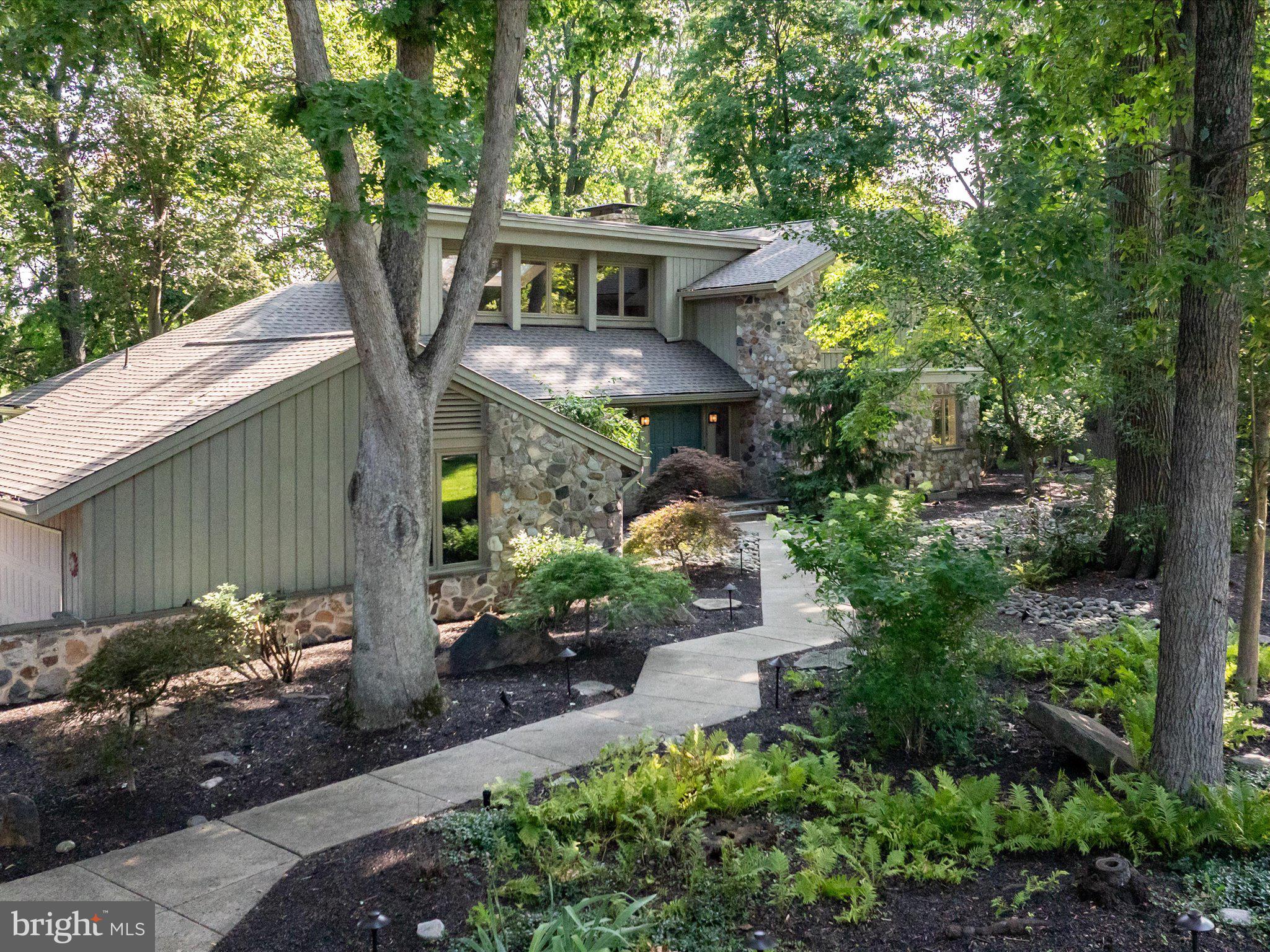 Nestled within the highly sought-after Timber Ridge community, equidistant from New Hope and Newtown, PA, this remarkable residence is perfectly positioned on a premium lot backing to expansive preserved open space and a picturesque pond. The newly renovated home offers a first-floor primary suite, open and airy living and entertaining spaces, and tranquil views from every room. Seamlessly blending privacy, natural beauty, and sophisticated living, this home offers an exceptional retreat.
The dramatic great room is filled with natural light from newly installed oversized windows and features a floor-to-ceiling stone fireplace, custom bar, hardwood cathedral ceiling, and skylights that further enhance its airy ambiance.

At the heart of the home is a custom-designed chef’s kitchen and dining area featuring premium Cristallo quartzite countertops, a full suite of Miele appliances, and an expansive center island.

The luxurious primary suite serves as a private two-room retreat, offering direct terrace access, a custom walk-in closet, and a completely renovated, spa-inspired bath with an elegant circular layout, freestanding soaking tub, rain shower, and separate water closet.

A beautifully designed bluestone terrace extends from the great room and primary suite, creating an idyllic setting for outdoor dining, entertaining, or simply enjoying the peaceful surroundings.

The second level offers three additional bedrooms, each with vaulted ceilings and hardwood flooring, providing comfortable accommodations for family and guests alike.

The exterior showcases a timeless combination of stone and wood siding, complemented by professionally designed landscaping, upgraded drainage systems, front and rear irrigation, and architectural/landscape lighting. Significant recent improvements include a new roof, gutters, and gutter guards.

Additional amenities include a finished basement, new laundry area, and oversized attached garage.

Residents of Timber Ridge enjoy access to community amenities including tennis courts, scenic fishing ponds, walking paths, and beautifully maintained common grounds, along with the highly regarded Council Rock North schools.

Ideally situated near major commuter routes, this exceptional property offers convenient access: 20 minutes to airport and NYC train, 45 minutes to Philadelphia, and 90 minutes to NYC.