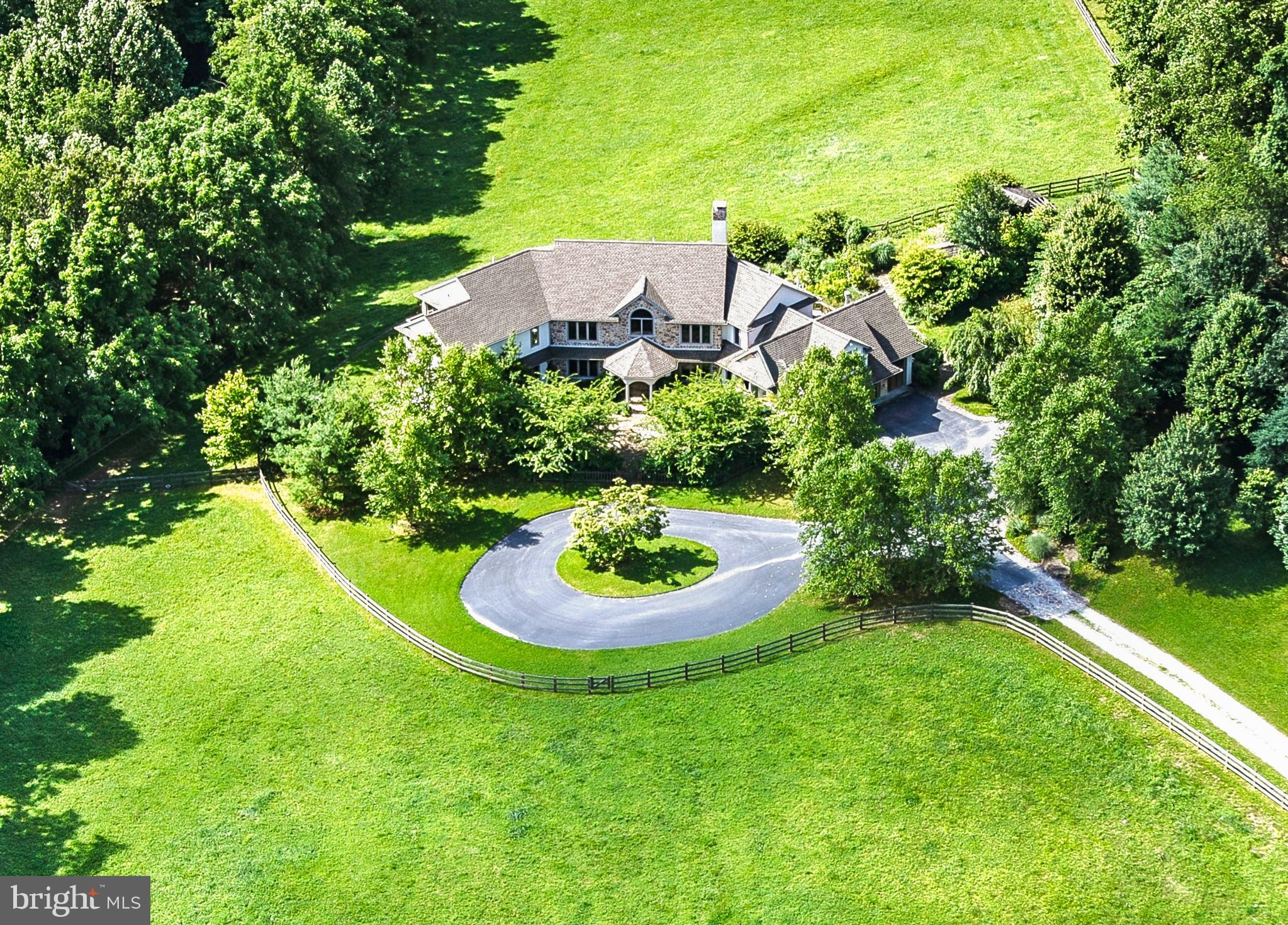 Set on 23+ acres in one of Chester County’s most sought-after locations, this remarkable property combines a picturesque country setting with a custom home designed for comfort, elegance, and recreation. Privately sited and surrounded by open space that abuts the 1,263-acre ChesLen Preserve, the residence offers 5 bedrooms, 4 full and 2 half baths, and exceptional equestrian facilities.
The home’s open floor plan is filled with natural light and designed to capture stunning views and southern exposure. Main Level highlights include magnificent reclaimed wood and antique heart pine floors, a Great Room with a wood-burning fireplace and bucolic vistas over the pastures, and a large Office with fireplace that could also serve as a first floor Guest Suite. The Upper Level features a Japanese-inspired Primary Suite with Shoji screens as dividers, plus four additional Bedrooms and two full bathrooms, including a suite well-suited for an Au Pair or guests.
The fully finished Lower Level is an entertainer’s dream, complete with an expansive Indoor Pool, Game Area, second Kitchen, Exercise Room, full Bath, and Sauna.
For equestrian pursuits, the property features a 4-stall Barn with Wash Stall, Feed and Tack Rooms, four pastures, a round pen, and a 100' x 170' Riding Ring with exceptional footing. Additional highlights include a scenic pond and beautifully landscaped grounds.
Built and maintained to the highest standard, this exceptional property is located between Marshallton and Unionville in Radnor’s Brandywine Hunt Country and the award-winning Unionville-Chadds Ford School District, with convenient access to West Chester, Kennett Square, Wilmington, the Route 202 corridor, and trains to Philadelphia and New York.