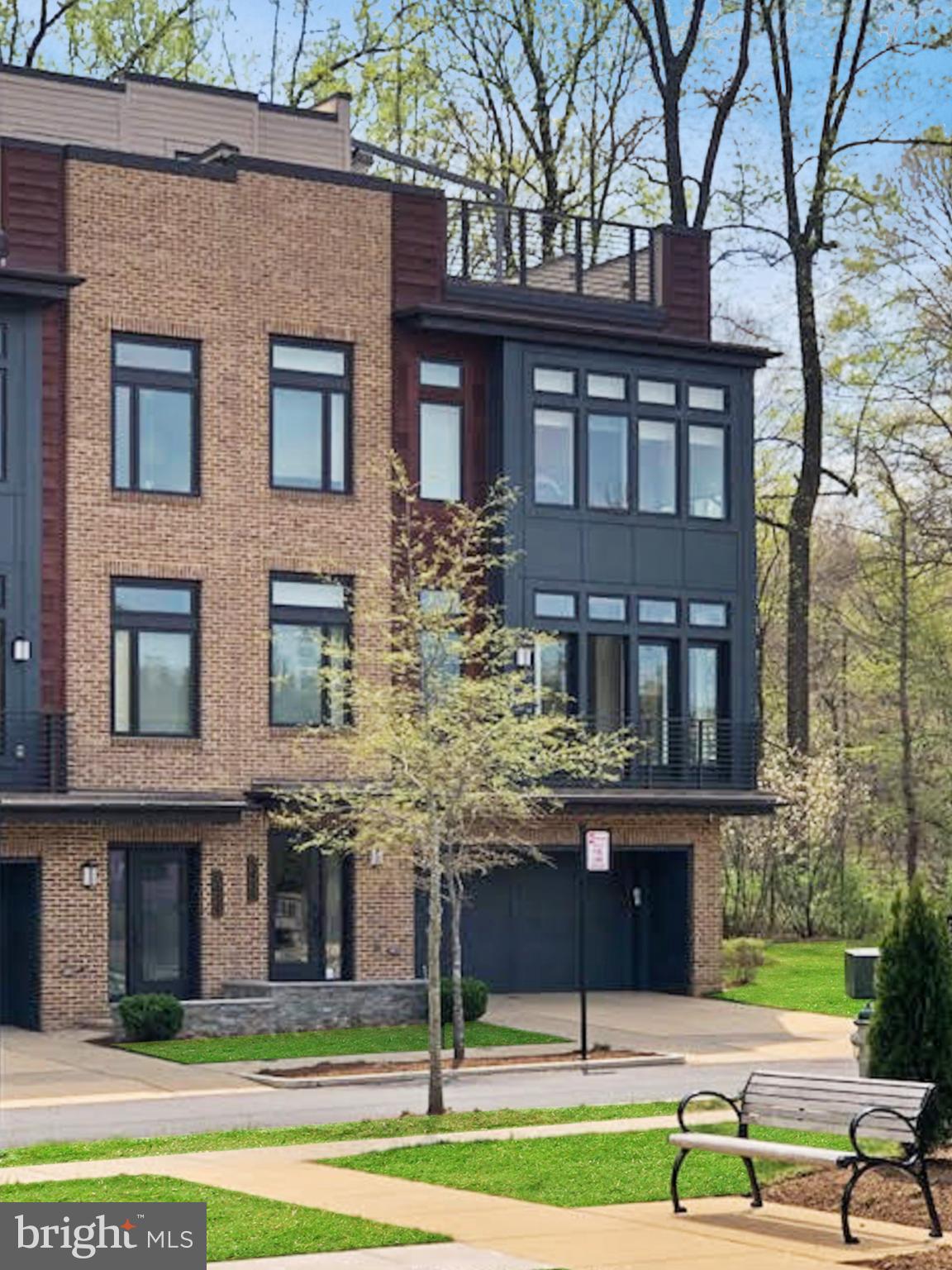 Welcome home to this SPECTACULAR END UNIT in the convenient neighborhood of Grosvenor Heights! This four-level luxury elevator townhome is one of only TWO homes in the neighborhood which BACKS TO TREES, AND has a private yard! Largest end unit in the neighborhood, and NO STEPS TO ENTER! Incredible SAVANT SMART HOME automated system throughout, including lights, TVs, speaker system with surround sound, blinds, and more, all controlled by your app! Spacious floor plan with soaring 10' main-level ceilings, 9' bedroom-level ceilings, and floor-to-ceiling windows! Light and bright main entry level, with bedroom/office and full bath off of large two car garage. Private elevator access to all four levels, including rooftop terrace. End unit wall of windows highlights the STUNNING gourmet kitchen; Top of the line appliances, including Bosch dishwasher, Sub-Zero refrigerator and separate wine fridge, Thermador cooktop with contemporary stainless steel and glass range hood, built-in Thermador convection & microwave ovens, all QUARTZ countertops; family room with 42" modern gas fireplace on main living level with contemporary surround, opening to deck with gas grill hook-up; Large open concept dining area, gives plenty of room for entertaining; Guest half bath; Recessed lighting & beautiful hardwood floors throughout. Upper bedroom level boasts large primary bedroom with large walk-in closet, as well as a comfortable en-suite bathroom, including: Frameless glass walk-in shower with curbless entry, polished chrome Kohler fixtures and contemporary shower head, 12"x24" floor and wall tile installed vertically to the ceiling, comfort height WaterSense-labeled water closet with elongated bowl, custom framed mirrors over dual vanity, undermount cast iron sink in granite top; widespread Kohler faucet, and sleek frameless designer cabinetry. Two additional bedrooms and hall bath with 13" X 13" upgraded floor and wall tiles, as well as a large laundry room with Energy Star washer and dryer, complete the upper level. If that isn't enough, one level up, walk outside to the expansive rooftop terrace with BUILT-IN fireplace AND grill; stainless steel cabinetry, sink & Viking refrigerator, Dekton countertop, TV & speaker system, upgraded Brazilian hardwood tiles, retractable awning, retractable shade, lighting throughout & hose bib. Tons of options for memorable home entertaining! Also includes a maintenance free backyard with doggie Astro turf! This home was built to LEED for Homes standards set by the U.S. Green Building Council for environmental friendliness and energy efficiency.
