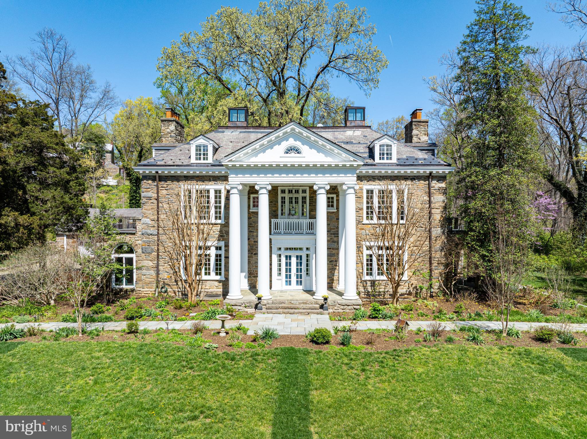 Greystone Manor is sited on over three secluded acres adjacent to the lush expanse of Rock Creek Park, and this circa 1913 stone manor house is a rare and distinguished example of Washington, D.C.'s Classical Revival architecture. Designed by renowned Washington architect Waddy Butler Wood, whose work helped shape the architectural fabric of the capital in the early 20th century, the home stands as a graceful testament to timeless design, craftsmanship, and historical significance. Available for the first time in thirty years, this compound includes an elegant stone residence, guest cottage, 50’ pool and terraces, cutting and vegetable gardens, tennis court, all set on over three acres that fold into Rock Creek Park. What truly sets this estate apart is its unparalleled location, privacy and scale. Commanding nearly 10,000 square feet, the main residence offers an exceptionally rare opportunity to establish a private family compound just over three miles from the White House. In a city where space is at a premium, this expansive estate combines the privacy of a countryside retreat with the accessibility and prestige of a central D.C. address—offering a once-in-a-generation chance to create a sanctuary in the very heart of the nation’s capital. Located at the end of a private road, the access to the compound is discreet with an immediate feel of privacy. Upon entry, the home immediately impresses with a grand central foyer, featuring soaring 10-foot ceilings and graceful architectural symmetry. From here, the home flows seamlessly on one side to a magnificent formal living room, anchored by a wood-burning fireplace and bathed in natural light from oversized windows, and two sets of French doors which open to a side terrace. On the opposite end of the home, a gracious formal dining room with a fireplace offers the perfect setting for elegant dinner parties and large-scale entertaining. Designed for both luxurious gatherings and everyday living, the main level includes a large kitchen outfitted with extensive counter space and professional-grade appliances. Adjacent to the kitchen is a warm and inviting family/sun room with space for informal dining and relaxed seating, creating a natural hub for daily connection. Completing the first floor, a library and private office provide quieter spaces for reading, working, or retreat. The second floor is home to a generous primary suite complete with a sitting room, spa-like bath, and access to a private terrace with views of the sprawling grounds. Two additional bedrooms with en-suite baths, an attractive den, and another terrace complete this level, offering comfort, privacy, and flexibility. The third floor provides two additional bedroom suites and a large recreation space—perfect for movie nights, play, or multigenerational living. There is a full basement with laundry, gym and ample storage. The magnificent grounds unfold like a private park. The fifty foot swimming pool is nestled amongst trees and offers a beautiful stone loggia for peaceful moments in the shade. The pool is situated beside a sprawling vegetable and cutting garden, both of which are just two aspects of the estate’s expansive grounds. Proceeding away from the house, a private tennis court and rolling lawns offer endless possibilities for outdoor recreation and entertaining, whether it be sports matches, or lawn parties for guests. A separate guest cottage offers privacy and comfort for visitors, all within the secluded elegance of this generous and private estate. One of the home’s most exceptional features is its construction from stone salvaged from the original barn at Linnean Hill, the historic estate of Joshua Pierce, an early horticulturist and nurseryman whose property helped lay the groundwork for Rock Creek Park itself. This thoughtful use of reclaimed materials ties the estate to the land both literally and symbolically.