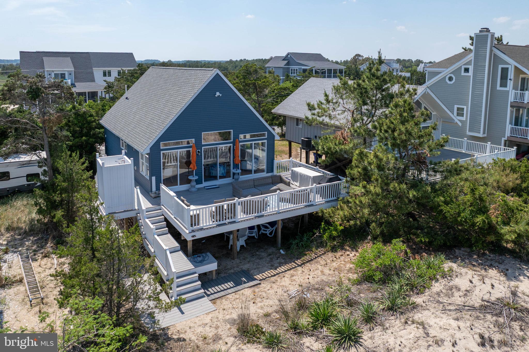 BAYFRONT RETREAT IN BROADKILL BEACH! This beautifully maintained 3-bedroom, 2-bath bayfront retreat perfectly balances timeless seaside charm with a functional open-concept layout, anchored by soaring vaulted ceilings and sliding glass doors that frame panoramic views of the Delaware Bay. The kitchen serves as a central hub, featuring stainless steel appliances, a deep farmhouse sink, and warm butcher-block countertops that flow seamlessly into the sun-drenched dining and living areas. table interior details include a custom-tiled staircase and a curated gallery wall, while the high-efficiency laundry room, conveniently complemented by a private outdoor shower, allows for effortless cleanup after a day on the sand.

The living space extends outdoors to an expansive, wrap-around deck designed for premier entertaining, offering unobstructed views of the rolling dunes and sparkling water. This outdoor oasis includes a dedicated grilling area and ample room for plush lounge seating, all just steps away from the private boardwalk leading to the sand. Accommodations are thoughtfully arranged, featuring a tranquil primary suite with vaulted ceilings and a charming bunk room perfect for guests. Both full bathrooms offer clean, contemporary finishes with subway tile and glass-enclosed showers. Completing this exceptional property is a massive ground-level enclosed storage area, ideal for kayaks, surfboards, and bikes; providing the perfect home base for exploring the nearby Prime Hook National Wildlife Refuge. A buoy was installed for easy boat and jet ski docking.  Have an electric vehicle? Hook it right up to the electric charging outlet!
Don't miss your chance to own this slice of paradise. Schedule a showing today, and start living the beach life you've always imagined!
** Back on market at no fault of the seller. Don't miss your second chance!**