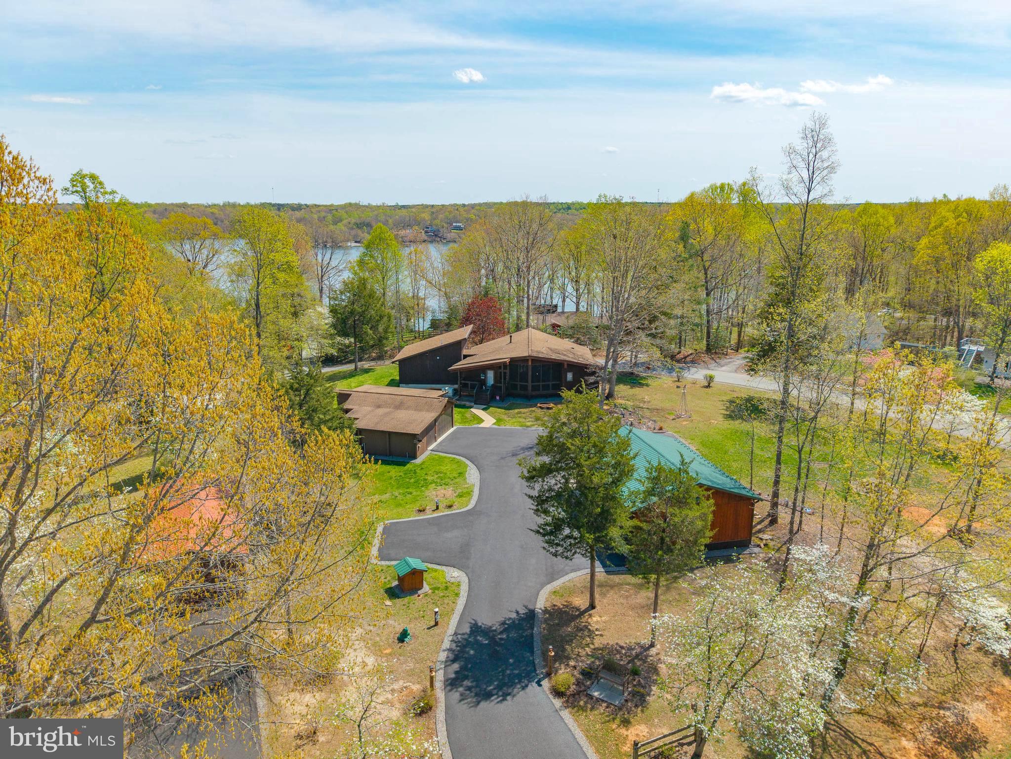 Experience the charm and character of this one-of-a-kind Lake Anna retreat, offered for sale for the very first time by its original owner. Lovingly maintained and thoughtfully designed, this exceptional property is far from cookie-cutter and delivers the perfect blend of privacy, flexibility, and lake lifestyle living.

This beautiful LAKE ACCESS  home is nestled on a beautifully wooded CORNER LOT IN A GATED Lake Anna community on the public side, this distinctive contemporary home offers a peaceful, park-like setting just minutes from all the lake’s most sought-after amenities without the waterfront price tag.

From the moment you arrive, you’ll notice the difference. Mature trees, meticulously maintained landscaping, a PAVED DRIVEWAY (recently re-sealed), and warm contemporary architecture create an inviting sense of arrival. Expansive windows fill the home with natural light while capturing serene wooded views and seasonal water views of Lake Anna. The OPEN CONCEPT layout and seamless indoor-outdoor flow make everyday living and entertaining effortless.

Step outside onto the spacious REAR COMPOSITE DECK the perfect place to relax, entertain guests, or enjoy quiet mornings surrounded by nature.

This rare multi-structure property offers incredible versatility with multiple OUTBUILDINGS ideal for storage, hobbies, workshop space, or future possibilities. A DETACHED GARAGE, generous paved parking area, and spacious lot provide room for boats, guests, outdoor recreation, gardening, or expansion.

Additional features include:

Conditioned concrete crawl spaces
Whole-house Generac generator
Large paved driveway
Detached garage
Mature landscaping and wooded privacy
Seasonal lake views
Community boat slips
Gated community access on the public side of Lake Anna

Whether you’re searching for a full-time residence, weekend escape, or investment opportunity near Lake Anna, this unique property offers comfort, character, and lifestyle in one exceptional package.

Virtual tour available, though this special home is truly best appreciated in person. Showings by appointment only.

Welcome home to Lake Anna.