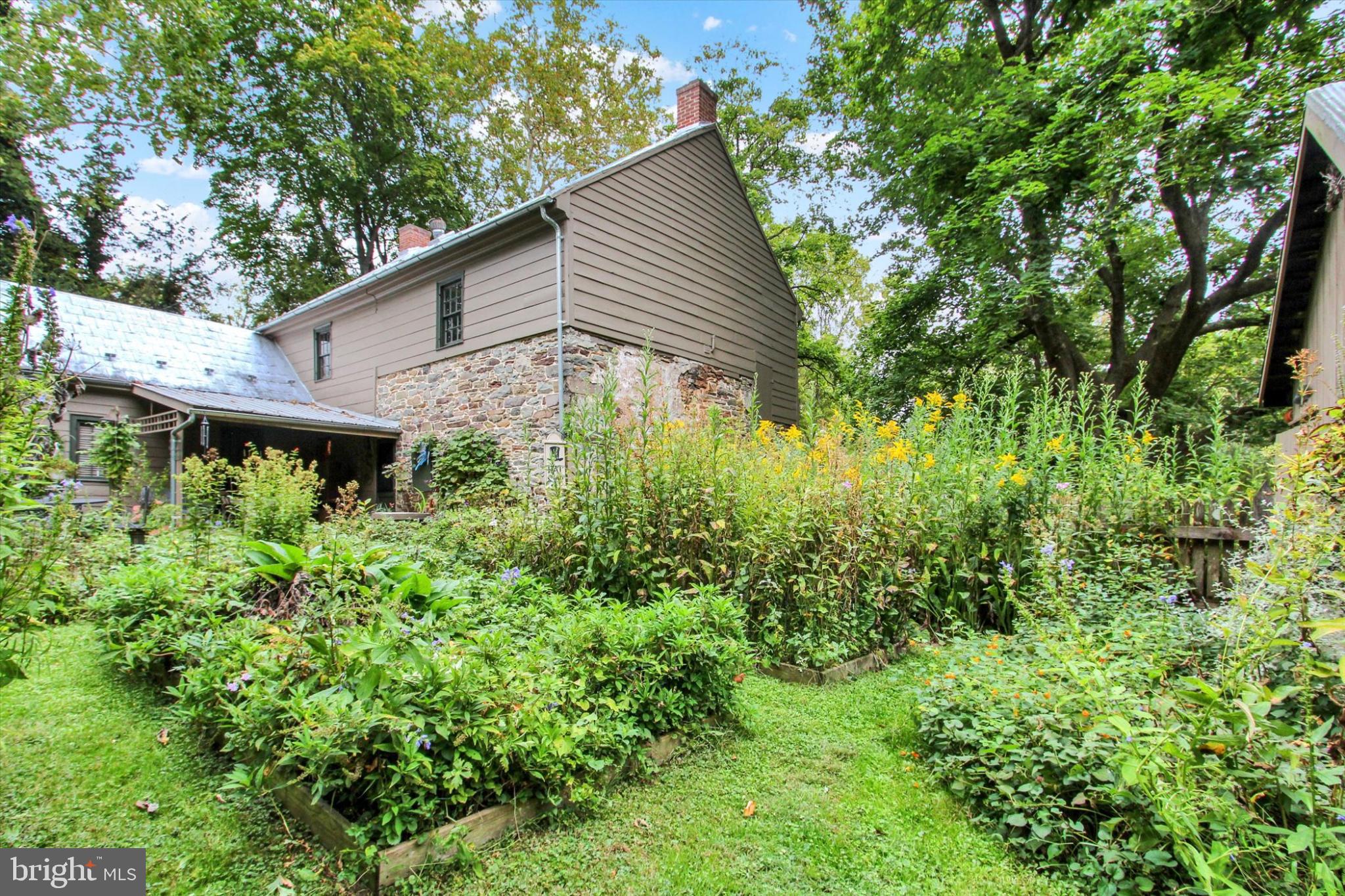 Take a look at this Historic Rare Pre-Revolutionary Home in Adams County, Pennsylvania!  This could be your new home! Step back in time without giving up modern comfort.  Dating back to 1745, this is a true piece of American history situated on nearly 12 level acres, just minutes from Gettysburg, Hanover, York, Route 15, and Harrisburg, PA. This distinctive property has been featured on the cover of two widely distributed magazines, Early American Life and Country Living, for its rare and picturesque charm. Recognized by Historic Gettysburg-Adams County as “The Historic Spangler Farm.” The current owners have meticulously maintained this home for nearly 30 years, making every effort to preserve and uphold its historical significance.  The home features authentic stone and hand-hewn log walls covered with exterior clapboard siding, original virgin chestnut & early American pine floors, exposed beams, and 3 fireplaces, all beautifully preserved. A tasteful historical color palette accents the original architectural details, including the interior plaster and beaded board walls. The house retains the original, hand-forged strap hinges, latches & lock box door hardware, as well as hand-forged nails. The first floor features a large eat-in kitchen with exposed beams, three additional rooms for dining, living, and office space, and a full bath.  The 7-foot cooking fireplace features the original crane and is flanked by built-in floor-to-ceiling cupboards with their own unique features, including spoon holder holes and plate rails.  On the second floor are three bedrooms, a full bathroom, and a desired second-floor laundry room. Wide-width pumpkin pine floors bring a warm charm to the rooms. Both floors are heated with baseboard heating and cooled with a split-system air conditioning. Two of the fireplaces are wood burning.  A pellet stove in the stone addition fireplace provides a cozy alternative heat. The chimneys have been repointed, and stainless-steel screens cover their tops. The entire house was painted using a solid color stain in 2023. The original embossed tin roof was coated with roof cement in 2021. The basement has an exterior entrance and stone walls. It houses the furnace, fuel oil tank, hot water heater, and built-in shelving for storage.  Step outside the back door and into a private retreat, surrounded by fencing & gates w/iron straps, hinges, and closures.  The brick walkways lead you through the vibrant backyard, filled with raised beds full of fragrant, blooming perennials and herbs, which provide a tranquil sanctuary. A thirty-foot wisteria arbor is a shady resting spot, with wonderful views of the pollinator-friendly garden. The 1800s-era potting shed features a gardener’s potting bench and ample tool storage. In addition, the barnyard, surrounded by a split-rail fence, is currently used as a 50’ x 50’ vegetable garden with compost-amended, loamy soil, producing large yields of edible crops. The property features a large historic bank barn, which is registered with Historic Adams County Barn Preservation. With its original timber framing, restored original stone foundation, metal roof, and dual-level access, this property offers excellent space for horses, farm-raised beef & milk cows, chickens for fresh eggs, or other livestock. The barn is also ideal for conversion into a unique residence, wedding or event venue, gallery space, antique shop, or agritourism destination. The banked design allows for easy access on multiple levels, providing versatility for storage, workshops, or creative redesign, as well as hobbies or future use. Two additional utility buildings enhance this farm's appeal, providing a great space for storing farm and lawn & garden equipment, all-terrain vehicles, and watercraft.  Four Bay two-story finished garage with finished space above for an in-home office or studio. The largest bay offers a 220-amp service for welding/restoration work.  New roof in 2022