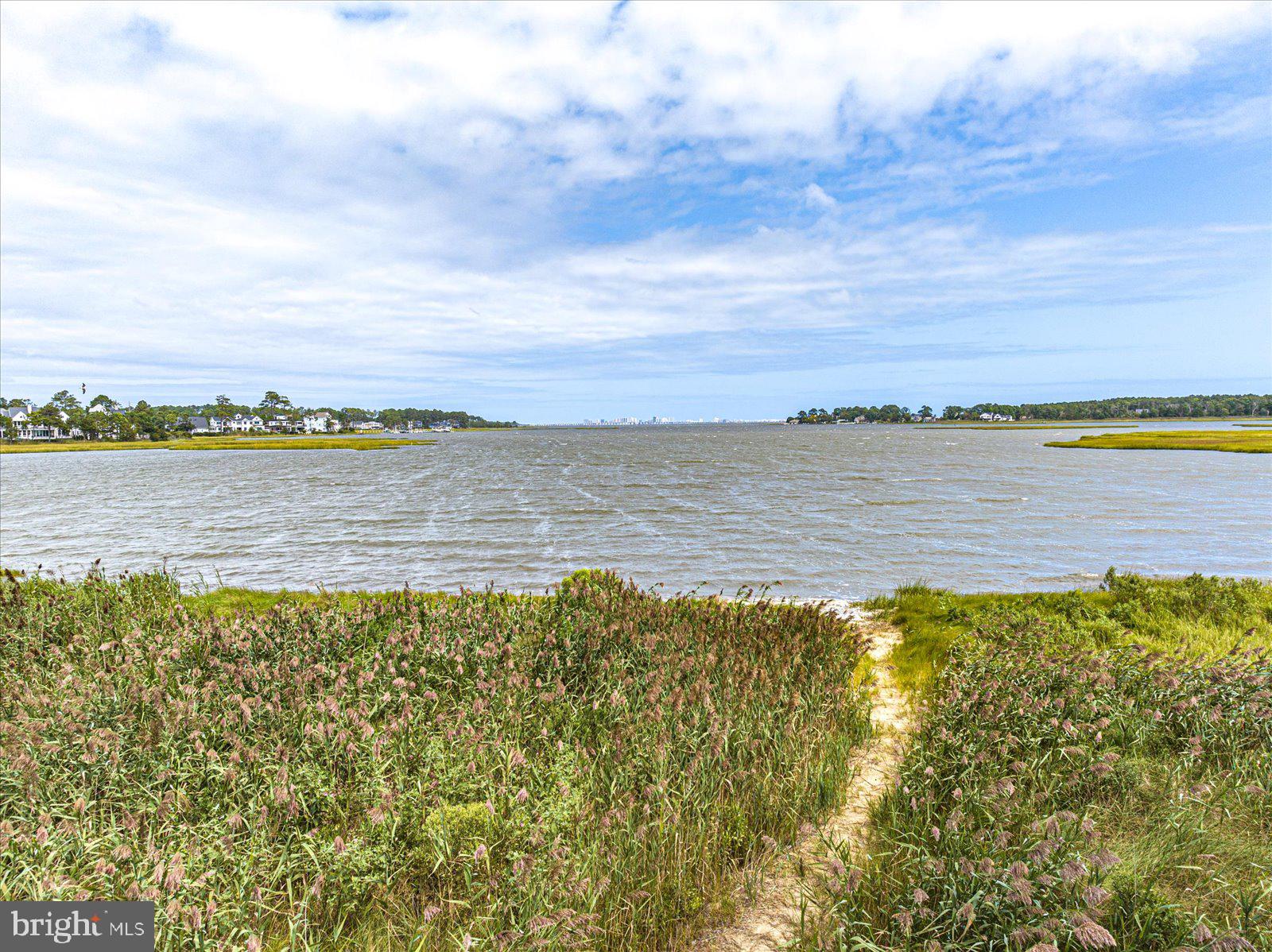 Owner Financing at PRIME available! Rare Opportunity: Build Your Dream Home on a Prime Waterfront Lot! Seize the chance to create your ideal residence on this exceptional 0.73-acre waterfront lot, nestled on an expansive sandy beach within the highly sought-after gated community of Glen Riddle. Enjoy panoramic views of the Ocean City skyline, and breathtaking vistas of Turville and Hearing Creek, as well as the Assawoman Bay. Glen Riddle is an amenity-rich community, featuring: Two championship golf courses, outdoor pool, The Ruth Chis Clubhouse, tennis courts,  fitness center,  billiard room, golf memberships, Jogging and walking paths, and a community room. Don’t miss this rare chance to live in luxury with unparalleled views and exclusive amenities!