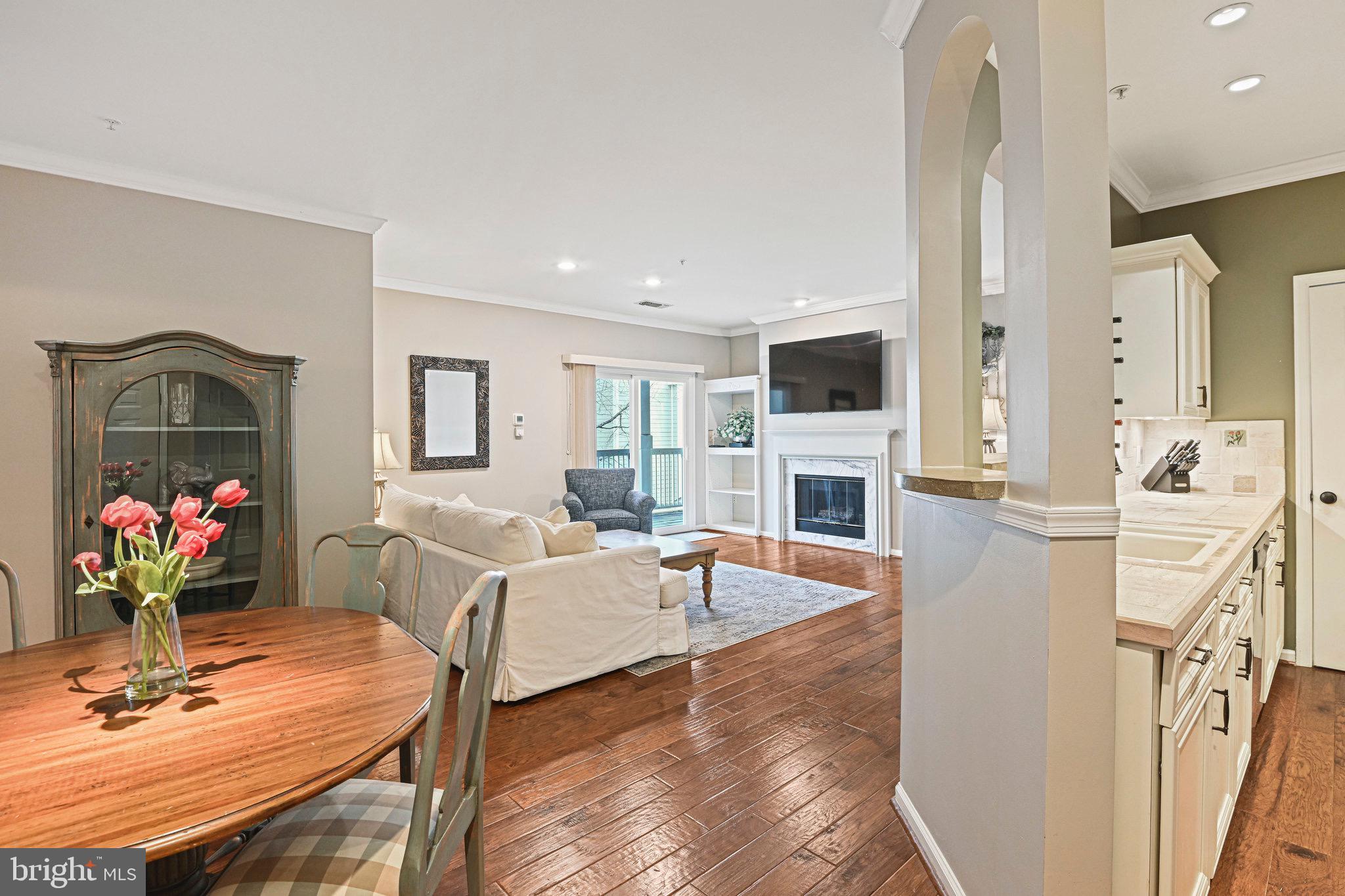 Welcome Home!  This is the largest model in Edgewater at Town Center and it offers elegant, high-end updates and renovations.   2 BR (split floorplan – brs separated by living space) and 2 FULL Bathrooms featured in this 1224 sq. ft. home.   Ceilings have been redone for a smooth finish, accenting the recessed lighting, crown molding and 9’ height.   First impressions of the open-space design features PRISTINE Vintage Virginia Hickory wide plank flooring let you know, you’ve found a special home.   The kitchen has been renovated with luxury, furniture quality cabinets: trim, molding, pull out drawers and plenty of storage.   The custom arch pass thru, built in wine rack and spacious custom polished concrete bar,  accent the classic modern design.   The living area features a gas fireplace with marble surround,  wood mantel, custom built in media center shelving with hidden TV wiring.    Lovely, generous sized, covered balcony off family room for private, outdoor enjoyment.   Great size primary bedroom with new high-end carpet.   The primary bathroom features a deep soaking tub, travertine vanity top,  and designer ceramic tile finishes.   All fixtures were replaced.    Ensuite BIG walk-in closet has a built in organizer system with drawers, shelves, hanging spaces – WOW!   Nice size 2nd bedroom with new carpet and great storage.  2nd Full Bathroom also renovated with consistent design and quality products including travertine vanity, undermount sink, custom framed mirror, ceramic surround and flooring, also all fixtures replaced.  Plenty of storage closets, full size front load washer/dryer in utility closet.  Renovated and ready for YOU.   Live the good life here.  CONVENIENT to ALL amenities yet, the setting is tranquil and peaceful.   A few blocks to Reston Town Center, approx. 1 mile to RTC METRO.    Easy access to Trader Joe’s, Harris Teeter and so many shopping options.   Set in the heart of the Tech Corridor with  quick access to Ffx County Pkwy, Dulles Toll Road, Tysons Corner, DC and  Dulles Airport.  Walk the nearby Washington & Old Dominion Trail, miles of additional trails, and pond.    FIRST time offered as a rental!  Must have Good Credit and Good Income/Debt Ratios.    See Today.