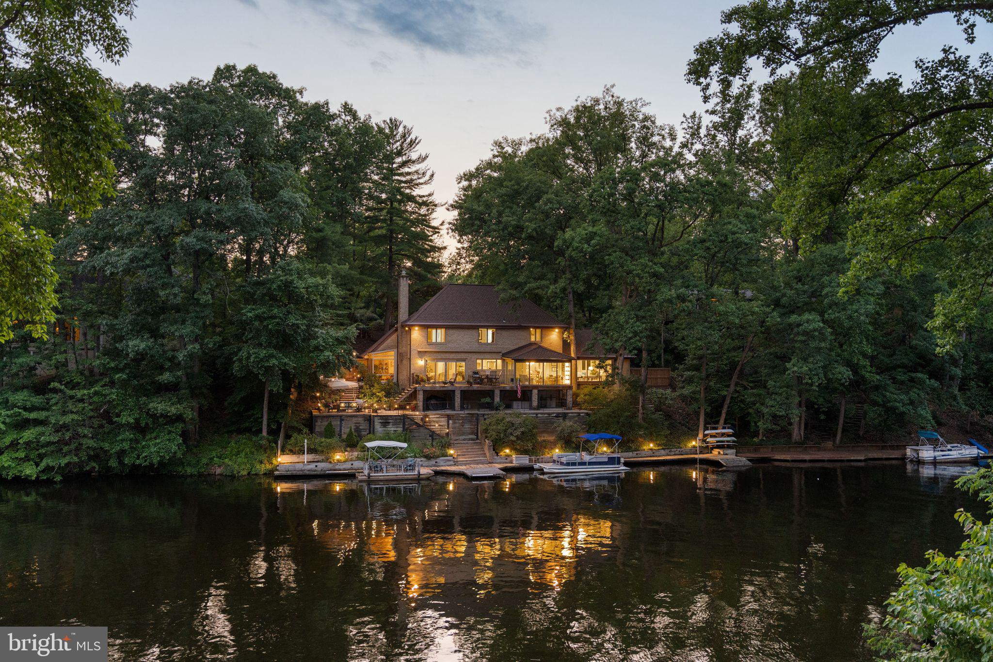 European Elegance, Waterfront Serenity, Just Minutes from Washington, DC.
Tucked away at the end of a quiet cul-de-sac, this waterfront estate feels more like a private European lakeside retreat than a home just eight miles from Washington, DC.<br><br>Surrounded by mature hardwoods and overlooking the tranquil waters of Lake Barcroft, the residence blends the elegance of a European manor with the serenity of lakeside living. Its stately brick façade, dramatic rooflines, wrought-iron balcony, and gated approach create a memorable arrival, while the rear of the home reveals an extraordinary waterfront setting where expansive terraces, decks, and entertaining spaces descend gracefully toward the shoreline.<br><br>Inside, lake views fill nearly every room, creating a seamless connection to the natural beauty beyond. Whether enjoying morning coffee overlooking the water, hosting sunset gatherings on the terrace, soaking in the lakeside hot tub beneath the stars, or launching a kayak from your private dock, every day feels like a getaway.<br><br>The private dock offers space for a pontoon boat as well as kayaks and canoes, while the property's carefully crafted stonework, mature landscaping, and peaceful wooded backdrop create a setting that is both sophisticated and remarkably private. From the multi-level terraces overlooking the lake to the inviting outdoor living spaces designed for entertaining and relaxation, the home embraces the very best of waterfront living.<br><br>Equally impressive is the level of care and investment the home has received. The current owners have completed substantial improvements, including a custom kitchen renovation featuring premium cabinetry, appliances, and Italian fixtures; renovated baths; replacement windows and doors; beautiful wood flooring; a light-filled conservatory addition; extensive hardscaping and waterfront stonework; and numerous infrastructure and system upgrades. A complete list of updates is available upon request.<br><br>Just minutes from the heart of Washington, DC, yet worlds away in atmosphere, this is a rare opportunity to experience one of Lake Barcroft's most compelling waterfront offerings.