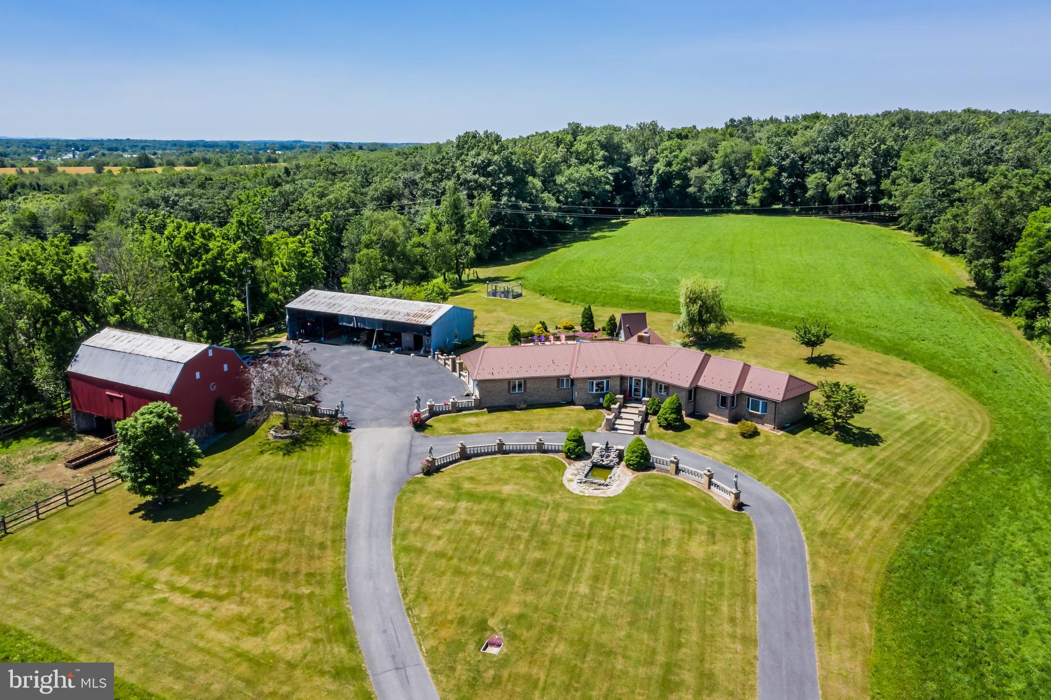 Truly exceptional is the only way to describe this property.
An enchanting drive along a long, private lane leads you past open pasture and a gently flowing stream before unveiling a breathtaking setting with panoramic views, a classic red barn, and an all-brick ranch perfectly positioned in complete seclusion. The approach itself feels almost storybook, and leaving the property is only tempting to take in the incredible views once more on the way out.
This remarkable estate offers approximately 75 acres of rolling countryside featuring crop fields, pasture, hunting ground, a stream, fishing pond, swimming pool, pavilion picnic area, fruit trees, and a multi-acre fenced garden ideal for serious growers or homesteading. Additional highlights include a barn, workshop, circular driveway, fountain, and the potential for subdivision into additional building lots.
The 3-bedroom, 2.5-bath all-brick ranch home showcases handcrafted woodwork created in the on-site workshop, a granite kitchen with solid hardwood cabinetry, spacious living room with fireplace, formal dining room, mudroom with laundry, and a full unfinished basement ready for future expansion. The lower level features a wood stove for efficient supplemental heat, complemented by a new heat pump installed in 2022.
Whether you’re searching for a forever home, working farm or ranch, private retreat, or legacy property, this offering delivers space, privacy, and a sense of enchantment rarely found.
Private showings only. Please respect the owners’ privacy—access to the property is by scheduled appointment with a licensed agent.