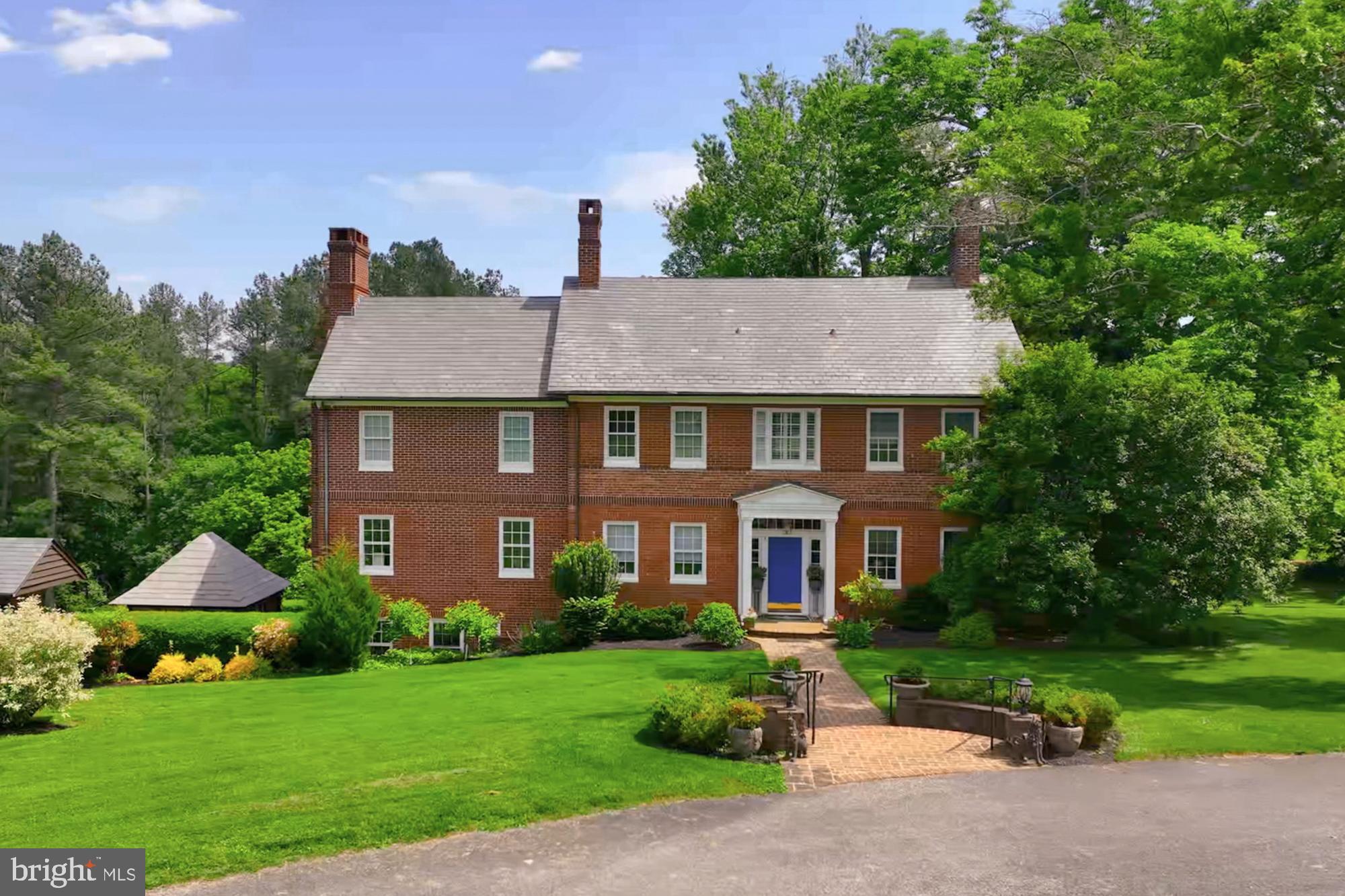 Don't miss the opportunity to own this truly exceptional estate, perfectly nestled on a peninsula along the Prettyboy Reservoir in Northern Baltimore County. This 16.3-acre property offers the ultimate in privacy, peaceful water views, abundant wildlife, and wide-open skies.

The estate's circa 1858 brick home beautifully blends the desirable charm and character of an old house with modern updates. This extraordinary property presents an incredible opportunity to create lasting memories across its many unique spaces. The property features a main house, a carriage house, a pool house, a magnificent party barn, a pool, a potting shed, a greenhouse, and so much more—it truly has it all! 
Upon entering the main house, you'll be greeted by its unique charm with its original wood floors, elegant moldings, and inviting warmth only an old house could offer. Enjoy the home's library with its intricate moldings, wood burning fireplace, and built-ins. Enjoy morning coffee in the home's sunroom with beautiful windows that frame the property's lovely park-like setting. A cozy family room with a wood-burning fireplace and built-ins offers stunning water views and direct access to the deck. The deck's elevated location makes it a perfect spot for stargazing at night. The "Blue Sitting Room" is equipped with a wet bar and fireplace, making it a perfect spot for after-dinner cocktails and conversation or game night. 

The home's third level houses the light-filled primary suite that includes his and hers closets, separate baths, and amazing views of the reservoir and the property's grounds. The home's unique dumbwaiter makes a stop on this level, making it easy to transport wood for the wood-burning fireplace located in the primary suite. A large second bedroom with an ensuite completes this level. 
The fourth level houses an additional two bedrooms, a hall bathroom, and loads of storage space. 

The lower level features a nicely equipped chef's kitchen with a large island, ample storage, a propane cooktop, a Sub-Zero refrigerator, and warming drawers. The dining room, with its abundant cabinets, offers unique features that emit an ambiance only an old house can provide: a huge fireplace, moldings, a unique wood ceiling, and a Dutch door leading to the back porch. There is also a large utility laundry room located on this level. 

There are numerous outbuildings for you to explore on this unique property, including a small brick building adjacent to the main house with a slate roof that is currently being used as a private office. The potting shed, fully functional greenhouse, pool, and pool house all have unparalleled views of the reservoir. There is a heated three-car detached garage for the main house.

Meandering through the property, you will come upon the crowning jewel: the unique party barn with its arched doors that make for a dramatic entrance. Imagine parties and holidays spent in this ultimate entertaining space. There is heat in the main area of the barn as well as three temperature-controlled spaces within, including a nicely appointed library.

The carriage house, which has four bedrooms and three bathrooms and overlooks the beautiful landscaped grounds, is adjacent to the property's party barn. It includes two garage spaces and is ideal for guests or extended family. It's perfect for multi-generational living, rental potential, or Airbnb.  Endless possibilities! (Buyer to verify with the county).
The property's tranquil setting includes specimen trees, beautiful spring and summer flowers, and fields of habitat grass. You can hike, fish, canoe, stargaze, and garden. Bring your horses or cars—it has room for it all and so much more!