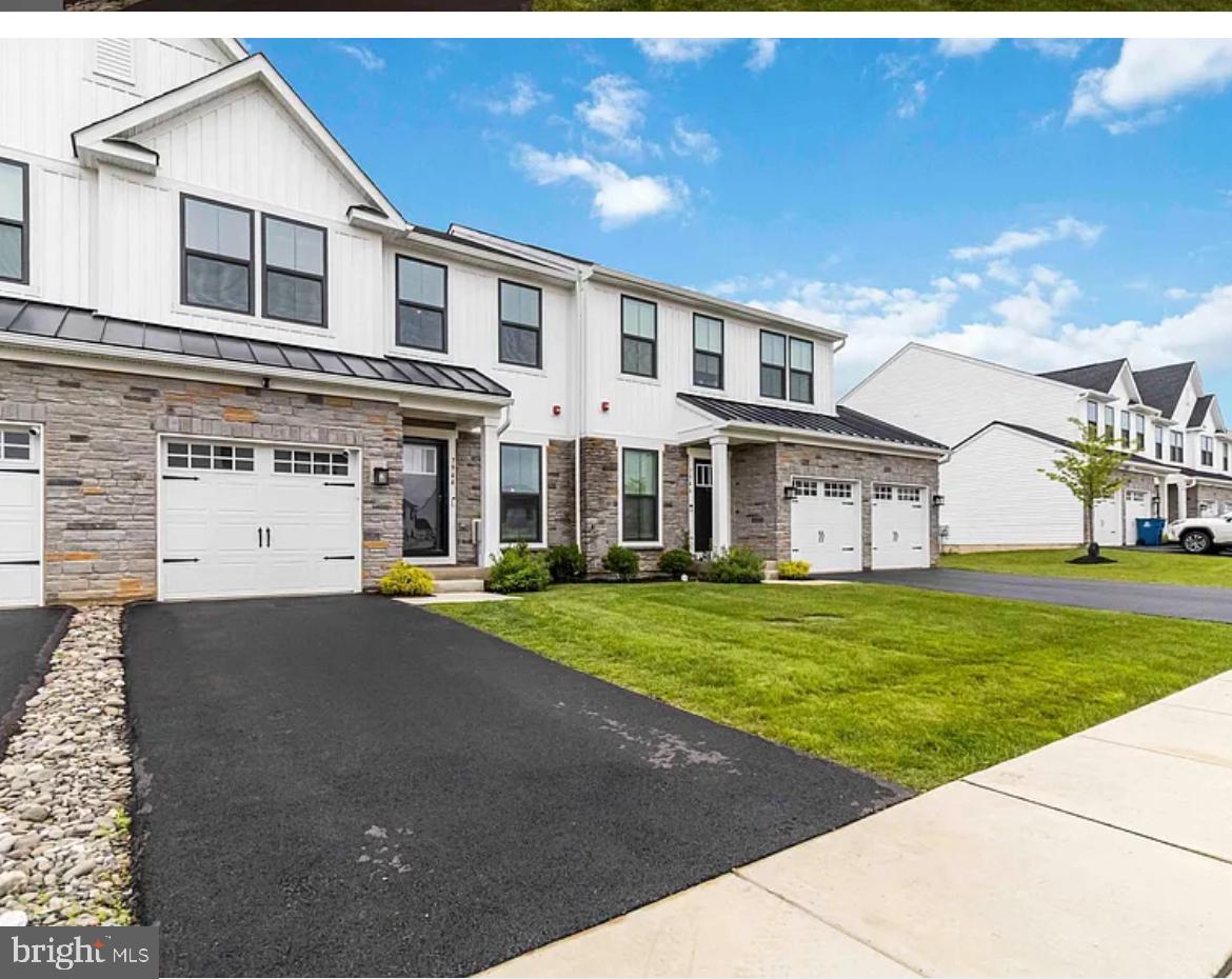Built in October 2023 in the highly-desired Ashbourne Meadows community, this townhome offers a total of 2,570 square feet of living space, complete with 3 bedrooms, 3 full bathrooms and a 1/2 bath, 9 ft ceilings, finished basement with walkout and sliding doors to backyard and walking trails. Natural light throughout is welcoming —inviting you to come on in! The first floor’s open concept morning room with wood crafted accent wall and luxury vinyl plank flooring throughout is perfect for study or reflection. Each room has large windows with custom blinds and recessed lighting. The living/dining room combination is perfect for gathering with friends and family or curling by the gas fireplace. The kitchen is upgraded with Quartz Countertops, all white cabinetry, stainless steel appliances, a gas cooktop and oven with upgraded vented microwave hood, extra large island with space for 4 large stools, a custom designer herringbone backsplash adds the perfect pop to the kitchen aesthetic. A half bath, food pantry, coat closet and access to the garage complete the first floor layout. Enjoy the picturesque view of nature from your spacious composite deck or head downstairs to hangout in the extra large family room with full bath and walk out to the back yard and walking trails. Extra storage in front of house, mechanical room or the under stairs is perfect for storing your seasonal items. Going up the beautiful oak steps and staircase, you’ll find the spacious primary suite, with vaulted ceilings, an ensuite bathroom with walk in shower and private water closet and a large walk-in clothes closet. At the opposite end of the hallway are two sizeable bedrooms, full size laundry room and a full bathroom. Come be part of an awesome community with plenty of activities for all! From lawn chair happy hour to book club to scavenger hunts and other amazing planned events plus easy access to neighboring suburbs, downtown and Northeast Philadelphia make this the perfect place to call home. Located in the Cheltenham School District, Ashbourne Meadows offers the best of suburban living.