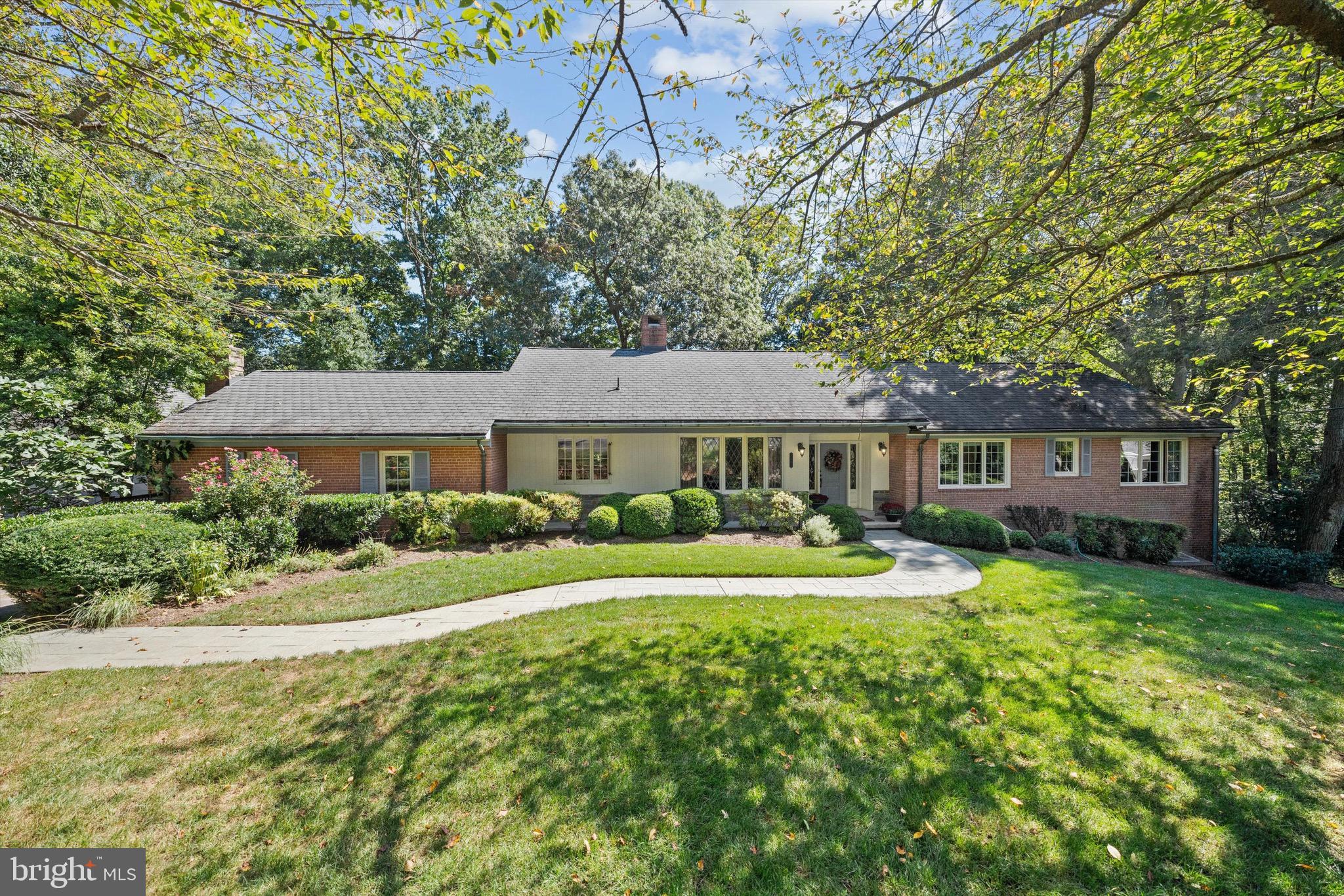 Tucked away at the end of a quiet cul-de-sac in sought-after Congressional Manor, this classic rambler sits on nearly 1.5 acres of beautifully landscaped and wooded grounds. The setting feels private and serene, yet you’re just a short walk to Congressional Country Club. Best of all, the home features a coveted FIRST-FLOOR PRIMARY SUITE – a major highlight that adds ease and convenience to everyday living.

The expansive lot is a true showstopper – offering endless possibilities for outdoor play, a pool, or a dream garden retreat. Inside, natural light floods the inviting living spaces, where a striking exposed brick wood-burning fireplace anchors the living room and flows seamlessly into the formal dining room. Walls of picture windows frame sweeping views of the backyard, bringing the outdoors in at every turn.

The gourmet kitchen features maple cabinetry, terra cotta flooring, granite and tile counters, and stainless-steel appliances, opening to a sunny breakfast nook and a welcoming family room with a gas fireplace and custom built-ins. French doors lead to a patterned concrete patio that overlooks the lush gardens.

The first-floor primary suite offers the ultimate convenience, with oversized picture windows showcasing the surrounding greenery. A renovated en-suite bath boasts radiant heated floors, a glass-enclosed shower, and a double vanity, while the generous walk-in closet adds function to style. Two additional bedrooms share a full bath, and a powder room completes the main level.

The bright, walk-out lower level expands the living space with a versatile recreation room, built-ins, and a wood-burning fireplace, plus two additional bedrooms, a full bath, an office/third bedroom, and plenty of storage.

Move right in and enjoy – or bring your imagination and unlock the full potential of this exceptional home, ideally located in the highly sought-after Carderock ES, Pyle MS, and Whitman HS cluster.