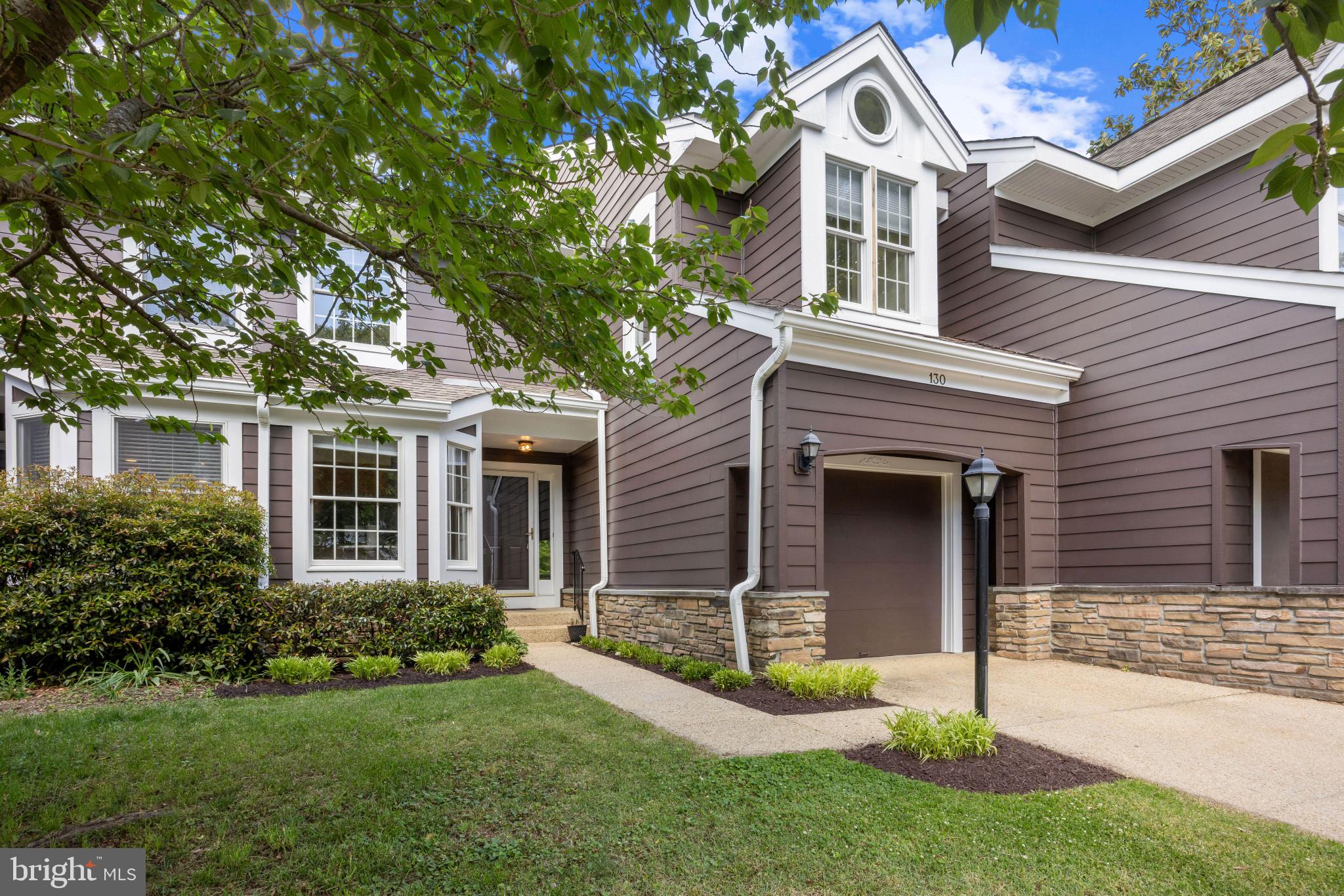 Welcome to 130 Summer Village Drive, a beautifully maintained three-bedroom, two-and-one-half bath townhome located in the highly sought-after Riva Trace community of Annapolis. Nestled within the desirable Summer Village section, this residence offers a rare blend of comfort, charm, and low-maintenance living surrounded by mature landscaping and exceptional community amenities.

The main level features an inviting and functional layout enhanced by hardwood flooring, abundant natural light, and thoughtfully designed living spaces. A spacious living and dining area flows seamlessly into a cozy sitting space anchored by a striking two-sided fireplace, creating warmth and character throughout the home. The kitchen features granite countertops, stainless steel appliances, ample cabinetry, and an ideal setup for everyday living and entertaining. Just beyond the main living area, the rear deck provides a peaceful outdoor retreat perfect for morning coffee or unwinding among the natural surroundings.

Upstairs, the spacious primary suite serves as a private retreat complete with its own balcony, walk-in closet, and an ensuite bath. Two additional bedrooms and a full hall bath provide comfortable accommodations for family, guests, or flexible workspace needs.

The finished lower level adds valuable additional living space and features a custom bar area ideal for entertaining, movie nights, or game-day gatherings. A one-car garage and additional storage space add convenience and functionality.

Residents of Riva Trace enjoy coveted water privileges and access to a community dock, along with tennis courts, walking trails, and beautifully maintained common grounds. Ideally located just minutes from Downtown Annapolis, shopping, dining, and major commuter routes, this home offers the perfect balance of tranquility, convenience, and the Chesapeake Bay lifestyle within one of the area’s most desirable communities.
