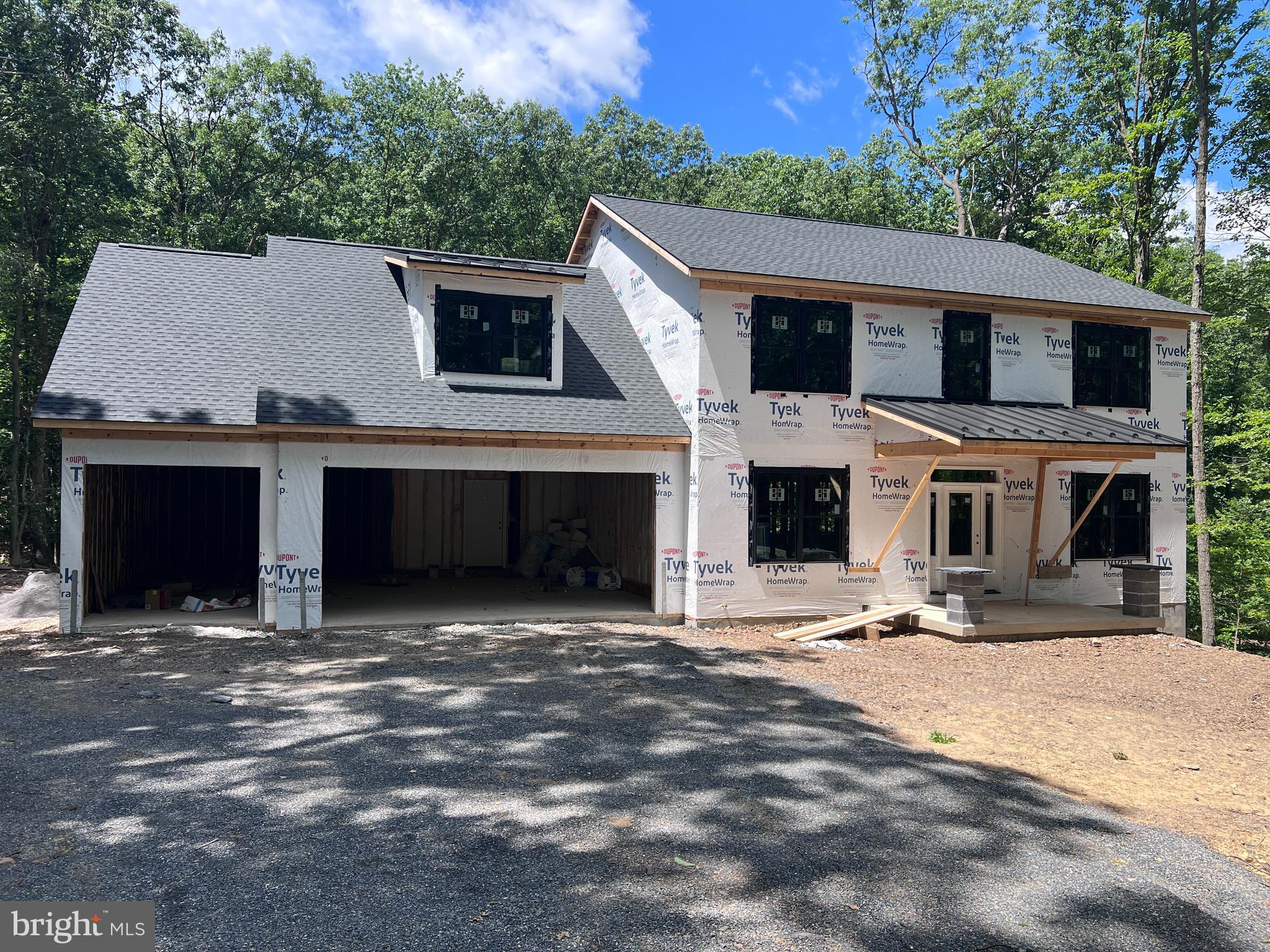 1.27 ACRE WOODED LOT IN Cumberland Valley Schools!  Black on black windows and cedar accents along with standing seam metal roofing gives this home a true LUXURY farmhouse feel.  This beautiful new home, built by 1st Advantage Construction, offers 5 bedrooms and 3½ bathrooms with a thoughtful layout designed for comfort and everyday living.  On the main floor (all hardwood floors), you’ll find a spacious dining room with Tall Wainscoting—perfect for hosting family dinners and holiday gatherings. There is also a private office with stylish coffered ceilings, giving you a quiet and impressive space to work from home. The large family room features a cozy gas fireplace, custom built-ins, and an open layout that flows directly into the kitchen, making it ideal for entertaining.  The kitchen is truly the heart of the home. It includes custom handmade cabinetry, granite countertops and backsplash, and an oversized 8-by-4-foot island that provides plenty of room for meal prep, cooking, serving, and gathering. Just off the kitchen is a convenient mudroom with a built-in bench and cubbies to neatly store coats, shoes, and backpacks.  There's also a walk-in pantry in the mudroom.  Upstairs, the primary suite is a true retreat. It offers generous space, a private sitting area, and a massive 13-by-7-foot walk-in closet. The primary bathroom includes double vanity, a private water closet, and a large walk-in tiled shower designed for comfort and style.  The finished walk-out lower level adds even more living space. It includes a large recreation room, a full bathroom, and an additional spacious bedroom—perfect for guests or extended family. Rough in for future wet bar.  There are also two unfinished storage areas that provide plenty of room to keep everything organized.  The home also features a large three-car front-entry garage with extra space in the rear for additional storage, tools, or a workshop area.  This home offers the opportunity to enjoy modern design, generous space, and quality craftsmanship in every detail.  The home is under construction and should be completed late July or early August.