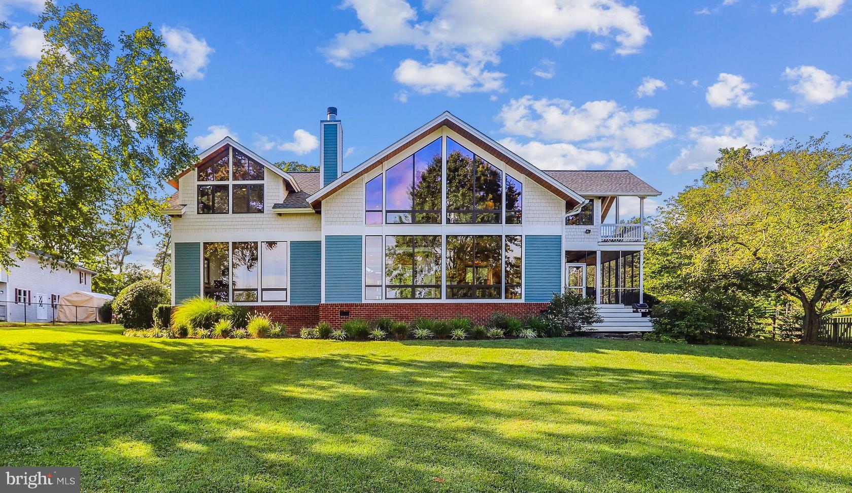 Absolutely stunning post and beam waterfront property located at the entrance to Cadle Creek, just off the Rhode River and the Bay.  This meticulously maintained contemporary home is more than just a waterfront home with breathtaking views, it's a sanctuary that offers a getaway from a busy life.  A fully fenced yard of 1.78 acres contains several beautiful garden areas to admire, as well as large grassy areas to play and entertain.  A flagstone walkway leads you to a serene courtyard at the front entry and dual mahogany glass doors and an 8' transom window gives a sneak peak of the waterview.  Once inside you are greeted by the warm Brazilian cherry hardwood floors that flow into a 2 story living room and a slate stone fireplace with triple mantels.   Beyond is a wall of glass giving an unencumbered view of the rear of the property and Cadle Creek from the living room, dining area, and kitchen.  A spacious gourmet kitchen features everything you need to whip up a culinary masterpiece, or entertain a large group of friends.  Dual sinks,  Sub-Zero refrigerator, warming drawer,  wine refrigerator, and a separate Scottsman ice maker and more make it a breeze.  When the weather is nice you can escape out the side door into a huge screened in porch area to enjoy a meal or drinks.  The main level primary suite has triple floor to ceiling windows to enjoy the same dramatic views from the moment you awake till sundown.   All three full bathrooms feature heated tile floors so you don't have to sacrifice comfort on chilly days.   Upstairs there is a bonus family room or seating area in the loft with it's own wet bar.  A second primary/guest suite has its own full bathroom and views of the Creek.  The third bedroom has sweeping views of the front of the property and gorgeous exposed cedar beams and ceiling.  Between the 3rd and 4th bedrooms is a connected bath and a Finnleo sauna to de-stress after a long day or workout.  This last bedroom just off the loft area is wrapped in windows and offers panoramic views of front and back from inside, or out on the large covered balcony.  Back on the main level is the laundry area with loads of cabinet space and a fixed sink.  A bonus room off the laundry/garage hallway could be a great hobby, office, or workout space with it's own separate entrance.  The oversized 3 car garage has room for all your vehicle and toys!  Stairs from the garage lead above to unfinished space ready for you to make your own.   At the backside of the property is your gateway to all the fun of a waterfront lifestyle.  48' of waterfront is draped with natural grasses and a wide pier that sits up high to escape the tides yet provide 6'MLW depth.  There's a 20k lift and power and water supply to the end of the dock and even space to put a couple of chairs and watch the boats go by.  Don't hesitate to check out this stunning property that only comes by once in a lifetime!