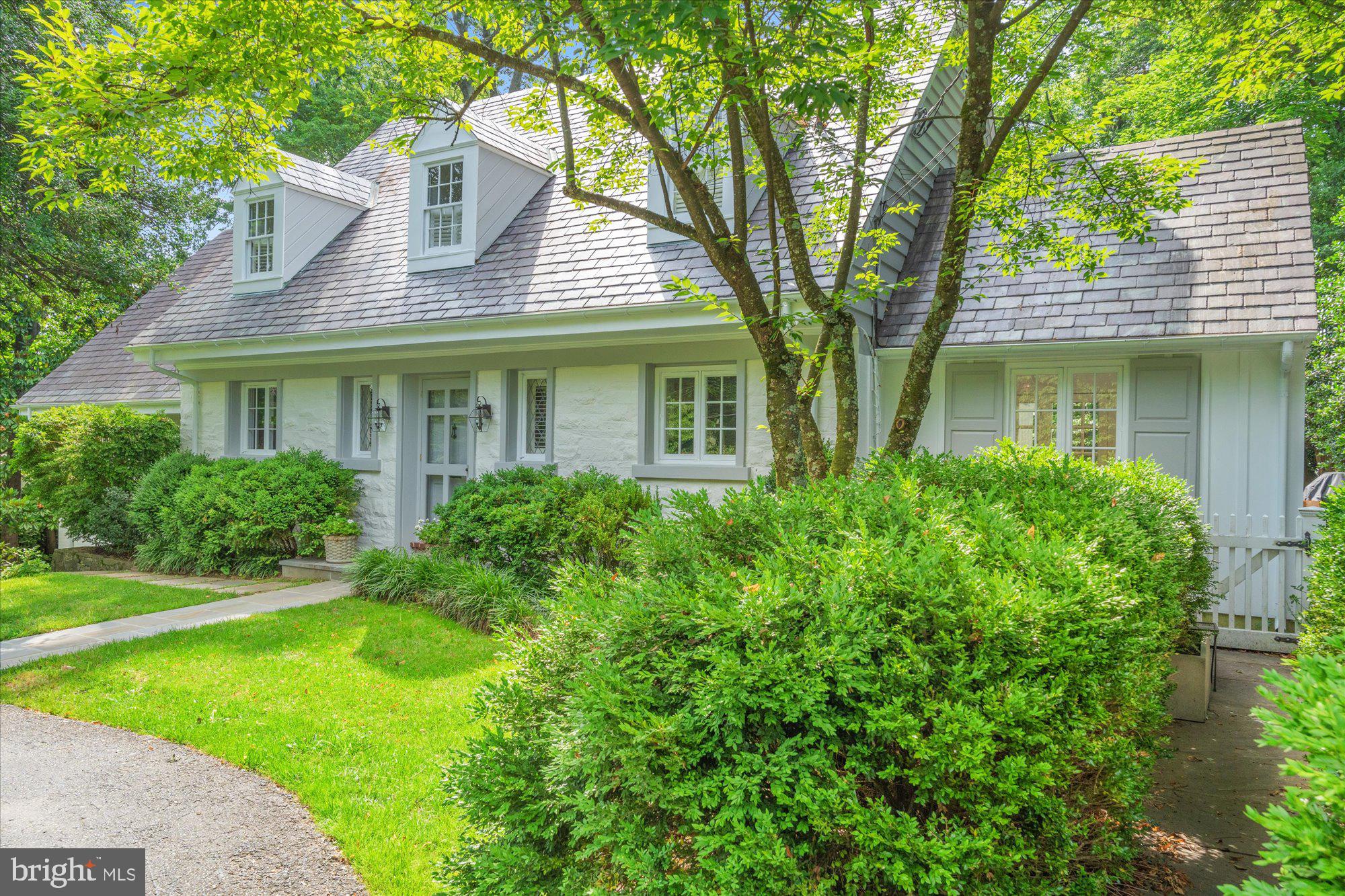 Welcome to this stunning 5-bedroom, 4.5-bath home on a spectacular .45-acre lot in the sought-after enclave of Chevy Chase Hills. This exceptional property with over 4000 sq ft of living space offers a rare combination of timeless elegance, thoughtful renovation, and modern livability—set amid lush, manicured grounds with an in-ground pool, extensive flagstone patios, and a striking serpentine stone wall that extends from front to back.
Recent renovations include a stunning reimagining of the main-level primary suite, now featuring wide-plank wood floors, added windows, and a spa-inspired ensuite bath. A renovated powder room, new appliances and countertops in the eat-in kitchen, updated lighting and hardware throughout, new carpets and stair runners, and new gutters reflect the seller’s meticulous attention to detail. Agents: please inquire for comprehensive list of upgrades.
The gracious main-level floor plan is designed for both everyday comfort and effortless entertaining. The large living room with newly added custom built-ins flows effortlessly between the formal dining room and sunroom which opens directly onto the patio, and a newly constructed IPE deck seamlessly connects the main-level primary suite to the sunroom from the outside—creating a true sense of indoor-outdoor flow. Newly installed HVAC systems now serve both the sunroom and dining room areas, ensuring year-round comfort. French doors from the kitchen open to a private patio—ideal for al fresco dining and entertaining.
Upstairs, the flexible layout offers additional bedrooms with a shared bath, plus a second primary suite with an ensuite bath and a large private sitting room.
The expansive lower level (1208 sq ft) offers impressive functionality and comfort, including a spacious fifth bedroom, full bathroom, and a large recreation room—perfect as a second family room, game room, or home theater. Custom built-ins on this level include an entire wall of sleek base cabinetry, dual built-in refrigerator and freezer drawers for entertaining, and a supplemental freezer in the storage area. A generous laundry room and two storage rooms complete the space, which connects directly to the surrounding patios.
Enjoy a bucolic setting just minutes from the shops and dining of Chevy Chase Lake and future Purple Line Metro access. This is a truly extraordinary offering that combines refined architecture, exceptional flow, and magazine-worthy outdoor living in one of the area’s most desirable neighborhoods.