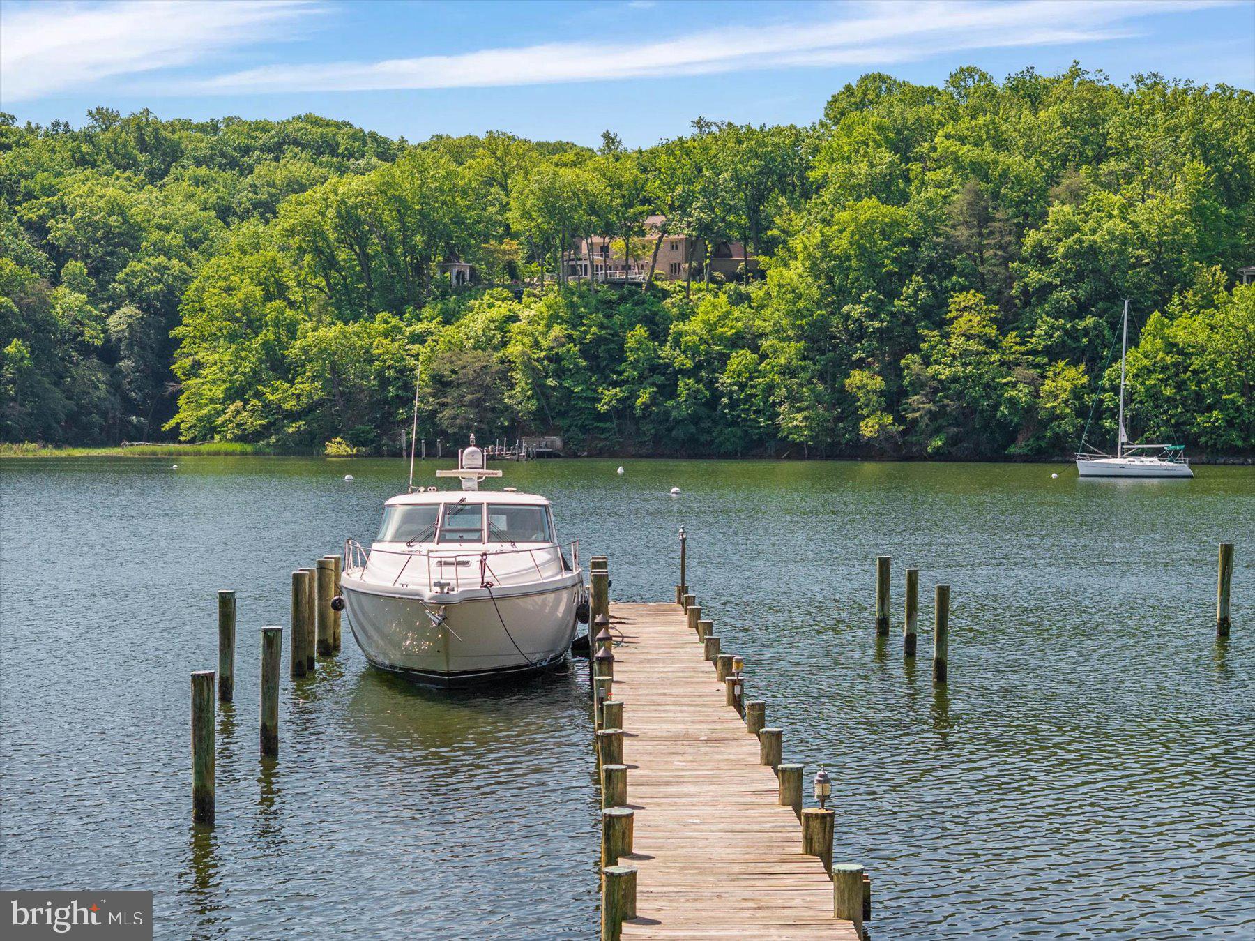1486 Downham Market is the ultimate Annapolis deep-water estate—designed for those who demand luxury, security, and boating excellence. Perfectly positioned at the mouth of Clements Creek—one of the safest hurricane holes on the Severn River—this home pairs architectural brilliance with one of the region’s most coveted waterfront settings.  A commanding 180’ pier with three boat slips, 50-amp power, and 11’ MLW welcomes yachts and sport boats alike—Hinckley, Viking, Boston Whaler, Pursuit, or Chris-Craft—this property can handle them all. Reinforced pilings are ready for lifts, making this a boater’s dream with full riparian rights. From here, you’ll be on the Severn and Chesapeake Bay in minutes.  Inside, walls of glass frame sweeping water views from nearly every room. Across three levels, the transitional design blends clean lines with warmth: hardwood floors, designer lighting, and soaring ceilings. The chef’s kitchen is fully outfitted with commercial-grade appliances, granite counters, and gas cooking, flowing into multiple living and dining areas anchored by a dramatic two-sided stone fireplace.  The primary suite is a true retreat—private sitting room and fireplace, a spa bath with skylight, soaking tub, glass shower, and custom walk-in closet. Additional ensuite and Jack-and-Jill bedrooms provide comfort and privacy for family or guests. The walkout lower level is built for entertaining with a rec room, wet bar, wine storage, gym, fifth bedroom, full bath, and a glass-wrapped sunroom ready for a hot tub retreat.  Outdoor living is extraordinary: multi-level decks, panoramic views, and serene waters that stretch toward the Severn and Bay. A brand-new septic system and advanced water treatment with reverse osmosis and UV protection offer peace of mind.  Set in the prestigious Downs on the Severn, residents enjoy two marinas, clubhouse, pool, tennis and pickleball, and a close-in location to Annapolis, D.C., and Baltimore.  Waterfront estates of this caliber almost never hit the market. 1486 Downham Market is ready now—bring your yacht, bring your lifestyle, and claim your place on the Severn.