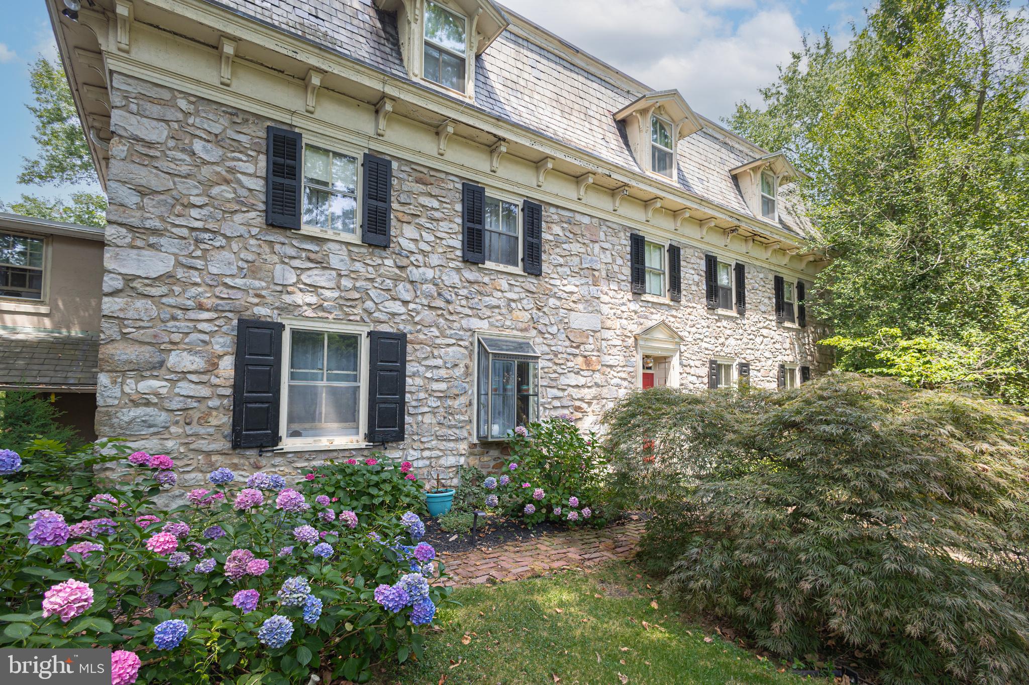 If you want to immerse yourself in Bucks County life surrounded by fresh air, countryside fields and farmland, Mill Creek Farm, a wonderful farmstead has what you are looking for and more! Nicely nestled on 14+ scenic acres, this circa 1730s historic property, once a quaint B&B, offers endless amenities beginning with an original stone manor, 13-stable horse barn, summer kitchen, corn crib, tennis court, pool with hot tub and a pond. Over the years the barn has been converted and renovated into 5 income producing apartments yet still keeping the horse stables intact along with two birthing areas that were used to breed thoroughbreds, making it very much a working farm in its day. The main house includes 5 bedrooms, 5 full baths and a convenient half bath. The rooms are comfortable with period dated hardware, deep windowsills, exposed ceiling beams and exposed stone walls. A favorite space in the manor is the enclosed porch adorn with bar and several sitting areas overlooking the Lahaska Creek flowing through the back of the property where you can rest in front of the stone fireplace and enjoy the picturesque views. At night you can step outside for backyard fireside chats by the creek and see a full sky of stars while listening to the sounds of nature or relax in the other delightful outdoor living areas such as the cozy spot by the summer kitchen known as The Crape Myrtle Pub with bar offering indoor and outdoor seating.  A bonus find on the third floor are the rare high ceilings and two private bedrooms with bonus storage. Perfect for a family compound and/or equestrian enthusiast this farm is situated about a mile away from town; along a quiet country road - Quarry Road, named after a quarry that used to exist a long time back at the end of the road which supplied the stone that gives the distinctive style to the buildings in the area. Overlooking green pastures, apple orchards, a pond and acres of serene gardens yet convenient to many Bucks County attractions and close to Doylestown, Lahaska’s Peddlers Village, and New Hope with its assortment of eateries and shops. Experience the peaceful grounds of this horse farm where William Penn held the farm’s first deed and immerse yourself in the country scenery and you’re sure to fall in love with this unique property!