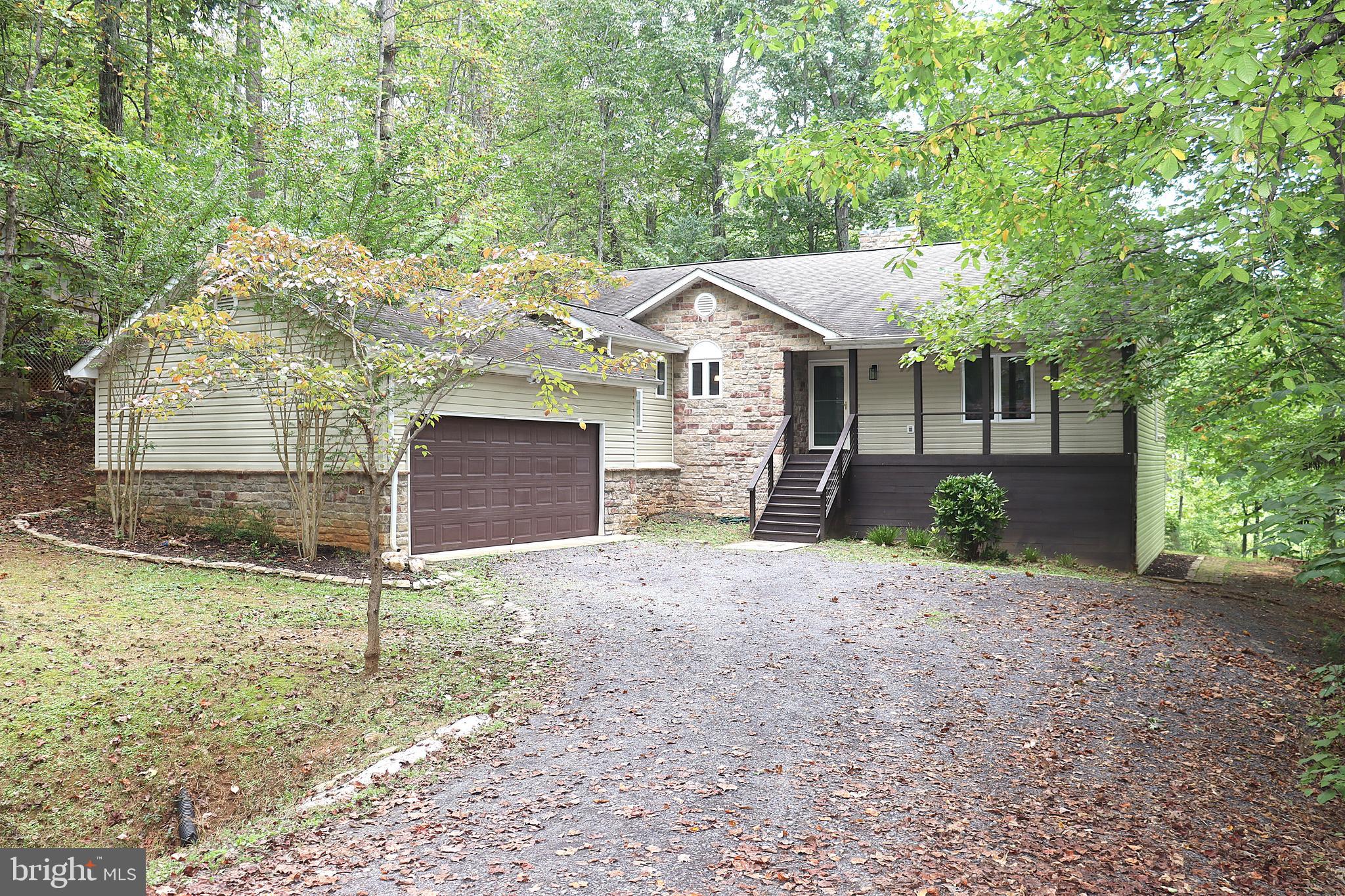 Security of a gated community that has loads on amenities to enjoy. The Seller explains why they purchased the home and why they think you will enjoy it as your home>>>When you step in the front door, the foyer contains an updated, alcove with bench seating for a convenient, practical spot to slip off your shoes and hang your coat up.  It has been encased with rustic boards that exude warmth and character.  The stone fireplace at the end of the foyer is open on both sides allowing it to truly be the home's centerpiece.  I immediately visualized it with our Christmas stockings hanging off the mantel and our 9' tree fitting easily beside it.  The open living room/dining room floor plan, soaring vaulted ceilings, and large windows allow for a lot of light to pour through.  Those same windows and the elevation of the home took my breath away as it seemed I was actually living in a tree house.  Squirrels, birds, deer, and even golfers can be watched through those windows.  The kitchen has a very cozy feel with its warm earth tones and is literally wrapped in cabinets.  Storage has never been an issue.  The primary suite on one end of the home allows for privacy and relaxation.  The jetted tub and large round window in the primary bath overlooks the fenced in courtyard.  The primary suite also has it's own separate door to the back screened in porch. That porch is a great place to retreat and watch the deer roam the back yard and is a cool respite from the summer heat.  The other end of the home has two additional bedrooms that are spacious with cathedral ceilings.  One of those bedrooms even has a walk-in closet - perfect for lots of toys or clothes to be stored.  The bathroom on that end has a basin sink and a custom, rustic sink cabinet that compliments the style of the home.  The first-floor laundry is conveniently located on the unique stair landing that leads to the 2 car garage and the walk-out basement.  There is additional storage under the steps and a huge storage room that houses the furnace and water heater.  The downstairs is perfect for an additional living room/den area/gaming room.  There is enough open area to set up a workout space, craft area, or other endless possibilities.  There are two more bedrooms downstairs that could easily be used as guest rooms or office space.  The large windows overlook the backyard and the golf course.  The downstairs custom bath features gorgeous tile work and a large walk-in shower with sliding glass barn-door type shower doors.  You could completely live on the main floor and leave the lower level for when you have company come to visit or vacation with you here at the lake. There are plenty of neighbors in this quiet section of the lake, but the way the home is situated on the lot and the mature trees that surround it ensure that privacy is not an issue.  Eastover Parkway conveniently loops around making it perfect for a quick lap around with your dogs.  Home is within walking distance of the little lake and boat ramp - great for fishing and kayaking.  The large, main lake is a short drive away and has many beaches for fishing, swimming, and boating.  The community has 2 pools, a clubhouse with a bar and restaurant, a gym that overlooks the lake, and an equestrian center.  There is always something to do at Lake of the Woods. See the HOA website for more info on amenities and services offered.