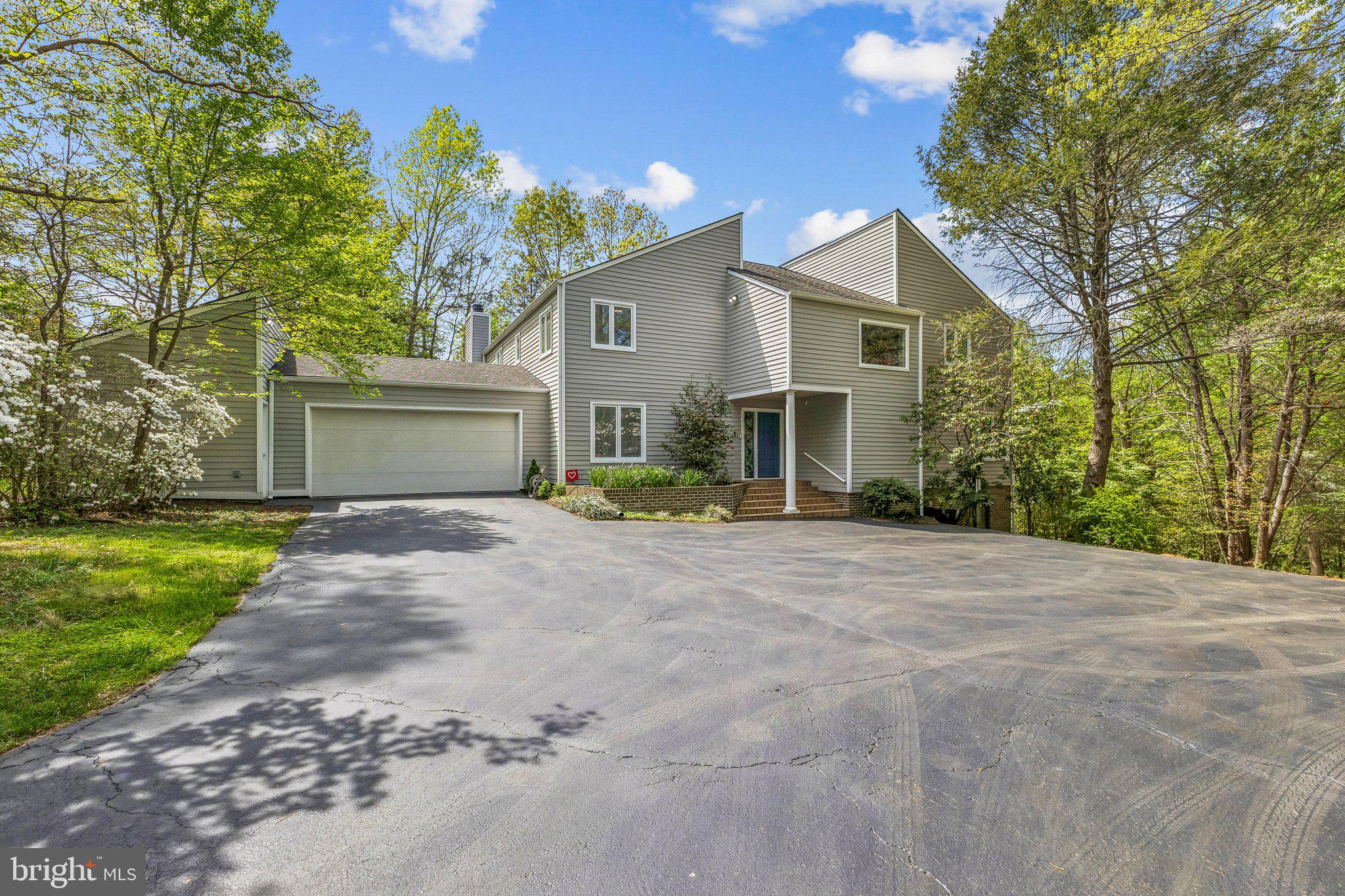 Nestled on 2.5 acres in the sought-after Hunters Valley community, this exceptional property offers a rare blend of privacy, natural beauty, and convenience. Surrounded by scenic trails and open green space, the setting provides a peaceful, rural atmosphere just minutes from the Town of Vienna and a short drive to Tysons Corner.
With over 4,000 square feet of living space, this contemporary home features 4 bedrooms, including a spacious primary suite with two attached full baths. The open floor plan is highlighted by soaring two-level ceilings, creating an airy, light-filled environment with views overlooking the main living area from the upper level.
The lower-level family room offers an expansive gathering space centered around a cozy fireplace, along with additional room perfect for games, recreation, and entertainment. Outdoors, the wooded lot gently slopes to a tranquil stream, enhancing the home’s serene setting.
A large deck provides the ideal space for outdoor entertainment, offering ultimate privacy and beautiful views of the surrounding landscape. Completing the home is an oversized two-car garage with a dedicated workshop area, perfect for hobbies or projects.
Residents enjoy access to nearby trails through Gabrielson Park, connecting to the Cross County Trail and the W&OD Trail for miles of outdoor recreation.
This is a unique opportunity to enjoy spacious living in a picturesque community while remaining close to everything Northern Virginia has to offer.