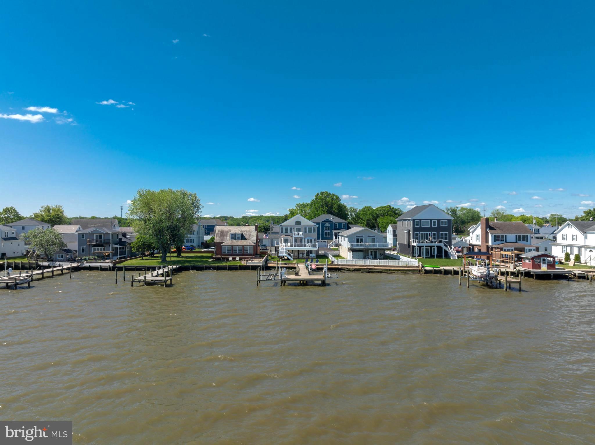 **Welcome to 7112 River Drive Road, a meticulously maintained waterfront retreat offering nearly 4,000 square feet of total space and breathtaking panoramic views that take center stage from nearly every room. Combining luxury updates, exceptional boating amenities, and thoughtfully designed indoor and outdoor living spaces, this extraordinary home delivers the ultimate lifestyle.
From the moment you step inside, soaring ceilings, gleaming hardwood floors, and expansive windows draw your attention to the spectacular water views. Natural light fills the home, while the family room offers a cozy gas fireplace and built-in surround sound, creating an inviting setting for both everyday living and entertaining.
The beautifully updated kitchen features Quartz countertops, recessed lighting, abundant cabinetry, an undermount sink, center island with storage, and Samsung Smart appliances installed in 2021, including a tablet-style refrigerator with water dispenser and ice maker. A 2026 kitchen addition created a charming breakfast nook where you can enjoy your morning coffee while taking in the tranquil waterfront scenery. Andersen sliding glass doors with built-in blinds, installed in 2023, open to a maintenance-free walk-down composite deck, seamlessly blending indoor and outdoor living.
The main level also includes two bedrooms, a full bath with porcelain tub from the original home, a laundry room with Smart LG washer, second washer (SideKick), and Smart dryer.
Upstairs, double doors lead to the luxurious primary suite, where oversized windows continue to showcase stunning waterfront views. This spacious retreat offers vaulted ceilings, brand-new carpet, a sitting area, a custom walk-in closet, and a private composite deck overlooking the water. The newly remodeled spa-inspired en-suite bath features a walk-in shower, freestanding soaking tub, double vanity, Smart LED mirror, Bluetooth exhaust fan, and a Smart toilet with bidet, heated seat, and auto-flush functions.
A previously unfinished attic has been transformed into a fourth bedroom/bonus room with new carpet, recessed lighting, updated electrical, built-in storage, and closet.
Outside, boating enthusiasts will appreciate the impressive 80-foot T-pier with water, electric, 30-amp shore power, two boat lifts (12,500 lb. w/Gem remote and 3,500 lb.), and a 1,500 lb. jet ski lift. 3 ft MLW and a hard sandy bottom, this property is ideal for boating, fishing, and water recreation. On clear days, the sellers note you can see the Eastern Shore from the end of the pier.
Additional features include concrete bulkhead, under-deck drainage, two sheds with maintenance-free platforms, a Polywood swing overlooking the water, a two-car attached garage, tankless gas water heater, Nest thermostat, generator hookup, fresh interior paint (2023), sealed driveway (2024), new shutters, front door, chandeliers, Hunter ceiling fans, and updated exterior lighting. The pier was redecked in 2020 with new end caps and hurricane straps added in 2024.
Flood insurance is only $565 annually. 
This exceptional property offers easy access to waterfront dining, fishing, and endless boating adventures. Experience the unmatched beauty of waterfront living and schedule your private tour today.