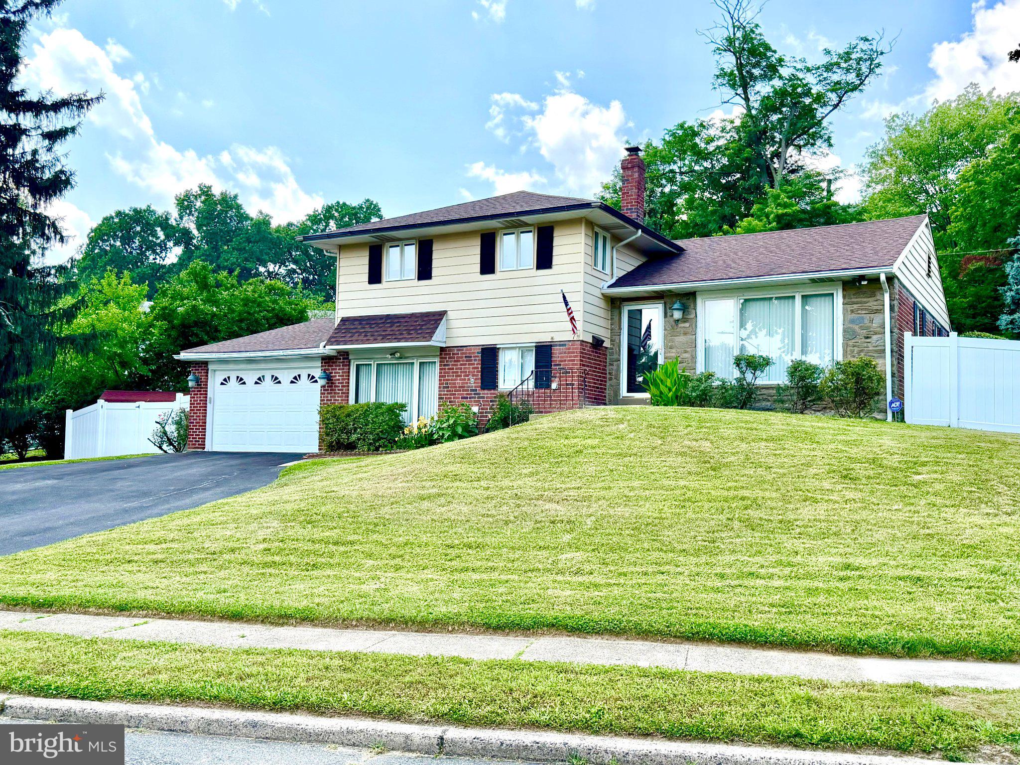This lovely 3 bedroom, 2 .5 bath, split-level residence, thoughtfully renovated in 2017, recently updated in 2025,  offers a harmonious blend of modern luxury and timeless charm. Nestled on a generous 0.33-acre corner lot, the property boasts lush landscaping and serene views of the surrounding trees and garden, creating a tranquil retreat just moments from urban conveniences(Starbucks is close by). The family room, conveniently located off the kitchen, features an electric fireplace, enhancing the warmth of the space. High-end finishes abound, including upgraded countertops and hardwood floors (which are carpeted) that flow throughout. The kitchen is a chef's dream, equipped with stainless steel appliances, including a built-in microwave, dishwasher, self-cleaning oven, and ENERGY STAR refrigerator. Enjoy the ease of a front-loading washer and dryer and ample storage in the combination basement. Retreat to the spacious primary suite, complete with a luxurious walk-in shower, while two additional bedrooms and well-appointed bathrooms ensure comfort for all. Outdoor living is equally impressive, with an expansive deck/patio ideal for al fresco dining or quiet evenings under the stars. With an attached garage and driveway parking for multiple vehicles, convenience is at your fingertips. This home is not just a residence; it's a lifestyle, offering a perfect blend of comfort, elegance, and nature, all in a prime location with easy access to public transportation. Experience the best of suburban living in this exceptional property.
