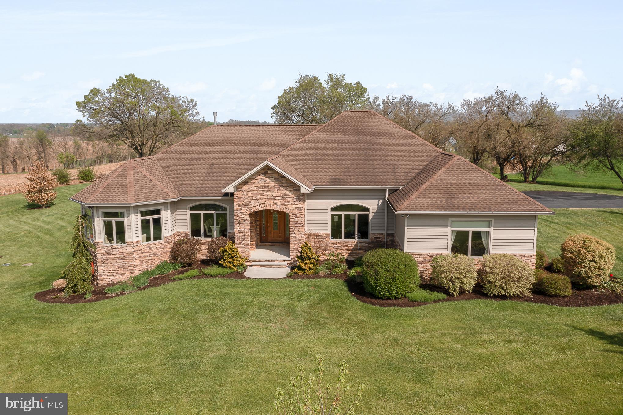 This elegant, modern ranch-style home is located on 15.42 scenic acres.  The main level boasts a large open concept floor plan.  The kitchen island is large enough to seat 6-8.  In addition to the formal dining area, is an additional casual dining area with a beverage bar and wine cooler.  The kitchen looks onto the substantially sized living room with a fireplace framed by custom built-ins.   The four-season room looks onto the patio and fenced back yard.  There are 9’ ceilings throughout the home and 10’ lighted tray ceilings in the master bedroom and bath, living room, dining, kitchen, office/4th bedroom and the en suite.  The main floor has 4,174 square feet with 4 bedrooms and 3 full and 1 half bath.  The side entrance of the home walks into a large mud room with ample counter and cabinet space.  

Check out the website for this listing which shows the floor plan!

The oversized 3-car garage has a garage heater, (2) 9’ doors and (1) 10’ door.

The full finished, walk-out  basement could be an in-law/nanny apartment, and is perfect for social gatherings.  It has a complete custom kitchen with bar seating.  This lower-level kitchen has a gas stove, dishwasher, and refrigerator.  In addition to the theater, pool table, and gaming area, the basement has a full-sized gym, an additional bedroom and full bath, a mechanical room with ample storage, and a separate storage room perfect for wine keeping.  

For the horse enthusiast, there are 8 acres of pasture with 3 board vinyl fencing and a riding arena with jumps.  If you are not using the pasture and riding arena, it would provide opportunity for rentable income.  The property is in the clean and green program thus resulting in lower taxes.  
There are many additional items of importance to mention about this home from the construction to the mechanicals.