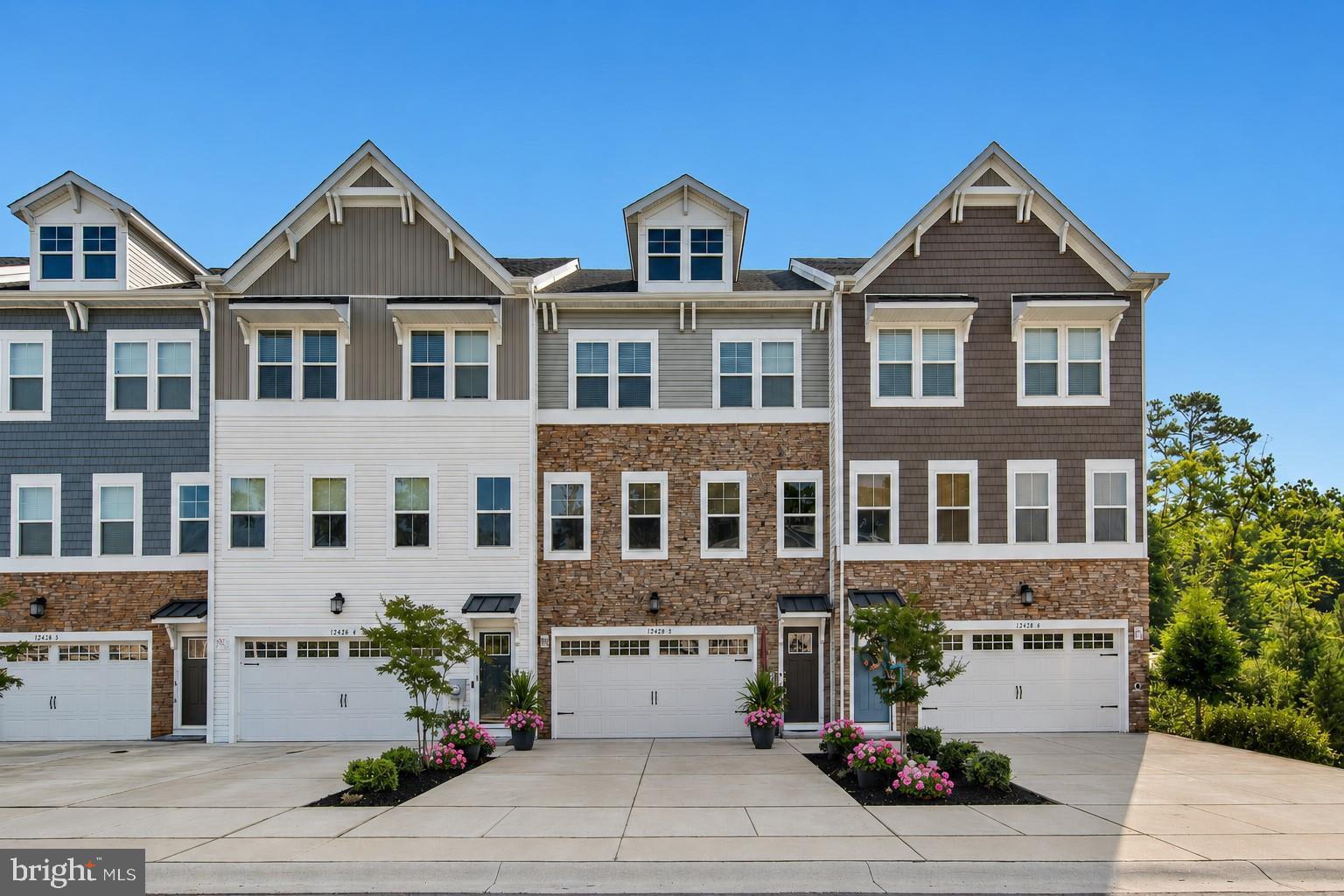 Welcome to 12428 Sea Oaks Lane, #5, an exceptional three-level townhome offering a rare combination of space, style, and coastal convenience. Unlike many four-bedroom townhomes that span four levels, this residence is thoughtfully designed across just three, featuring a highly desirable first-floor bedroom complete with a private ensuite bath, an outstanding and hard-to-find feature. 

Conveniently located in West Ocean City, this four-bedroom 3.5 bath home is just one mile
from the West Ocean City Harbor boat ramp and moments from local dining favorites and
shopping. You will also appreciate easy access to Ocean City Beach, the iconic Ocean City
Boardwalk, charming downtown Berlin, and the natural beauty of Assateague Island.

Inside, a soothing neutral palette, luxury vinyl plank flooring, and detailed crown molding create a cohesive and inviting atmosphere throughout. The gourmet kitchen is a standout, showcasing high-end finishes, quartz countertops, a stylish backsplash, and soft-close cabinetry. An expansive island, complete with a built-in microwave and dishwasher, anchors the space and provides the perfect setting for entertaining or casual dining. Additional highlights include a cooktop with range hood, double wall ovens, and a spacious walk-in pantry. The kitchen flows seamlessly into the dining area, where sliding glass doors open to an elevated balcony overlooking a private, tree-lined backdrop.  

The main level also features a convenient powder room and a dry bar, ideal for hosting. Upstairs, the primary suite offers a double-door entry, a generous walk-in closet, and a well-appointed en suite bath with dual vanities, a frameless glass shower, and built-in bench seating. Two additional bedrooms, a full hall bath, and a dedicated laundry room complete the upper level.  

The entry level expands the home’s versatility with a comfortable sitting area, a fourth bedroom with its own en suite bath and walk-in closet, perfect for guests, a mudroom, and access to the finished garage. From here, step outside through the atrium door to a beautifully designed paver patio with steps leading to the fully fenced backyard, where wooded views provide a sense of privacy rarely found in town home living.  Enjoy a community pool and playground.  Don’t wait, schedule your viewing appointment today!