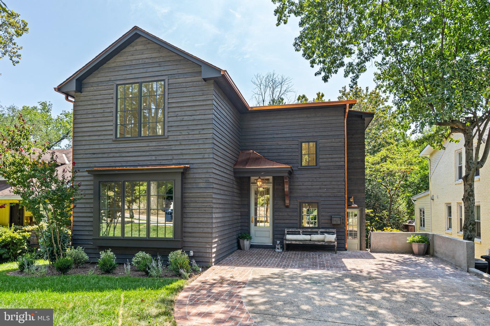 ** So special it was named the Wash. Post HOUSE of the WEEK**  Nestled on a deep and grassy lot in the desirable and welcoming Kent neighborhood in Northwest DC, this home has been meticulously renovated with no detail overlooked by local, boutique developer Scribe Development.  Scribe's hallmark is to renovate and reimagine homes with the utmost care & attention to detail.

This delightful 'Mountain Retreat in the City' finds natural inspiration from the southern Appalachian mountains and the architecture of the shingled homes and cottages in Highlands, North Carolina. The exterior is a natural western red cedar lap siding with mitered outside corners  with copper accents and details, and the casement windows are in a rich, iron ore finish. The existing brick driveway is enhanced with red brick in a basketweave pattern providing additional texture and patina; and a custom, built-in EV charger has been installed.

The welcoming exterior portico flows into a breathtaking two-story foyer, vaulted ceilings, white oak floors, an open staircase in white oak with candlestick balusters, and strategically installed lighting to showcase an owner's art collection. The main floor formal entertaining spaces include a light-filled yet intimate front room for both casual supper and formal dinner parties -- or use as an office or family room -- and a richly decorated sitting room with custom built-in cabinetry, Farrow & Ball paint and hand made brass lighting.  Bespoke touches are seen and felt at every turn: custom moldings and casements, the hand-hewn details, custom-crafted lighting, and built-in shelves and niches.

The hall from the foyer leads to the heart of the home -- an open-concept kitchen and dining / family room with selections that reflect a nod to nature: a white oak island, honed Taj Mahal quartzite countertops and floating quartzite shelving.  From the kitchen, the large window & french doors provide long-range views of the lush, deep rear yard. The large island with ample seating opens perfectly to the family room with an inviting fireplace with a slate surround and custom-crafted bookshelves.  It flows nicely out to a deck for dining and a breezy and welcoming screened-in porch that provides additional year-round living space -- ideal for al fresco dining, entertaining and relaxing.

Just off the brick driveway there is also an informal side entrance with a whimsical built-in herb garden that leads to a charming and functional space with custom-tiled terra cotta porcelain floors and shiplap walls -- and a beautiful granite prep sink, custom-built cabinetry, separate mudroom, and two large pantry closets.

The second floor has a gracious open foyer -- all with impressively high ceilings there are three nicely sized bedrooms, one with an en suite full bath with cornflower blue penny tile; a  full hall bath with white quartzite and white carrara marble and a stackable washer/dryer. Step into a world away into the hallway of the private primary retreat boasting a massive custom walk-in closet; a full bath with double sinks; honed carrara and allure gray marble checkerboard floors; herringbone shower; and the tranquil bedroom with vaulted ceilings and treetop vistas.

As you make your way to the lower level, there is a charming wallpapered powder room for guests -- then on to the windowed walkout lower level with a bedroom and bathroom and an oversized shower just perfect for guests, in laws or an au pair.  Enjoy a dedicated gym/Peloton room or office and a large family room that's perfect for movie night or the big game with doors that lead out to even more entertaining space with another outdoor dining area and large bluestone patio ideal for a firepit, conversation and enjoying nature.  There is  walk-in laundry with energy efficient machines, storage and a sink and a custom storage room with lighting and shelving for bikes, tools, & more.

NEW DRAFT RENDERING of how an in-ground pool would look --  stunning!