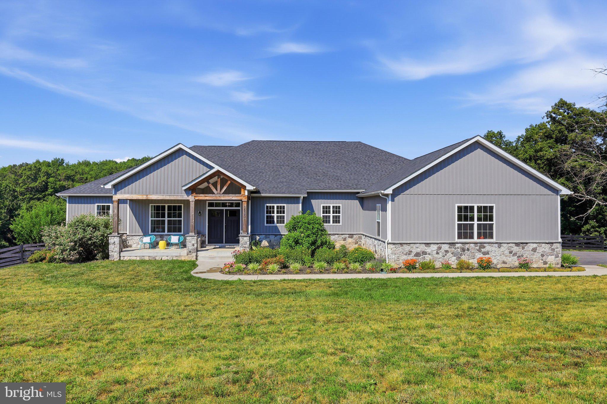 Luxury, privacy, and exceptional craftsmanship come together in this custom-built modern ranch estate, offering over 3,200 square feet of beautifully designed main-level living on 6.55 picturesque acres—just minutes from everyday conveniences.

Built in 2021 and thoughtfully designed for effortless one-level living, this extraordinary home is tucked well off the road behind a private electric gate. Surrounded by mature trees on three sides and overlooking open pasture, the setting offers remarkable privacy while being less than two miles from the MARC Train, shopping, and the mall, less than three miles from the Villages of Urbana, and minutes from major commuter routes.

A welcoming covered front porch and impressive double-door entry introduce an open-concept floor plan featuring luxury vinyl plank flooring, 9-foot ceilings, and designer finishes throughout. The private home office showcases French doors, custom wainscoting, and large windows overlooking the front grounds.

The dramatic great room is the centerpiece of the home with vaulted ceilings accented by decorative wood beams, custom built-ins, and a propane fireplace. A French door opens to the covered rear porch where peaceful views of the acreage and spectacular sunsets create the perfect outdoor retreat.

The private primary suite is a luxurious escape featuring a tray ceiling, large windows overlooking the backyard, and a striking wood accent wall. The spa-inspired ensuite offers a stunning 13-foot walk-through tiled shower with dual shower heads, transom window, freestanding soaking tub, separate oversized vanities, and a custom walk-in closet complete with chandelier, full-size window, and organizer system.

Designed for entertaining and everyday living, the chef's kitchen features a 9-foot island, abundant 42-inch cabinetry, granite countertops, Frigidaire double wall ovens, cooktop, range hood, built-in microwave, dishwasher, refrigerator, and exceptional prep space. The oversized walk-in pantry includes additional shelving, a separate freezer, and a full-size window for natural light.

The elegant dining room features tray ceilings, wainscoting, and windows on two sides, while the adjoining den with double doors, closet, and designer wood accent wall easily serves as a media room, library, or fourth bedroom. A built-in homework or planning nook adds thoughtful functionality.

Two spacious secondary bedrooms each offer walk-in closets and share a Jack-and-Jill bath. The oversized three-car garage opens to an impressive mudroom with herringbone tile flooring, built-in cubbies, powder room, basement access, and an oversized laundry room complete with granite counters, abundant cabinetry, utility sink, and a dedicated tiled dog spa with handheld shower.

The unfinished lower level offers an additional 3,200+ square feet with 9-foot ceilings, providing endless possibilities for future living space, recreation, hobbies, or multigenerational living.

Owned solar panels convey with the property and generate more electricity than the home consumes, resulting in an average electric bill of approximately $6.32 per month, with excess power sold back to the grid.

Offering luxurious one-level living, exceptional energy efficiency, unmatched privacy, and a location that perfectly balances peaceful country living with everyday convenience, this extraordinary property is a rare opportunity to enjoy the very best of both worlds.