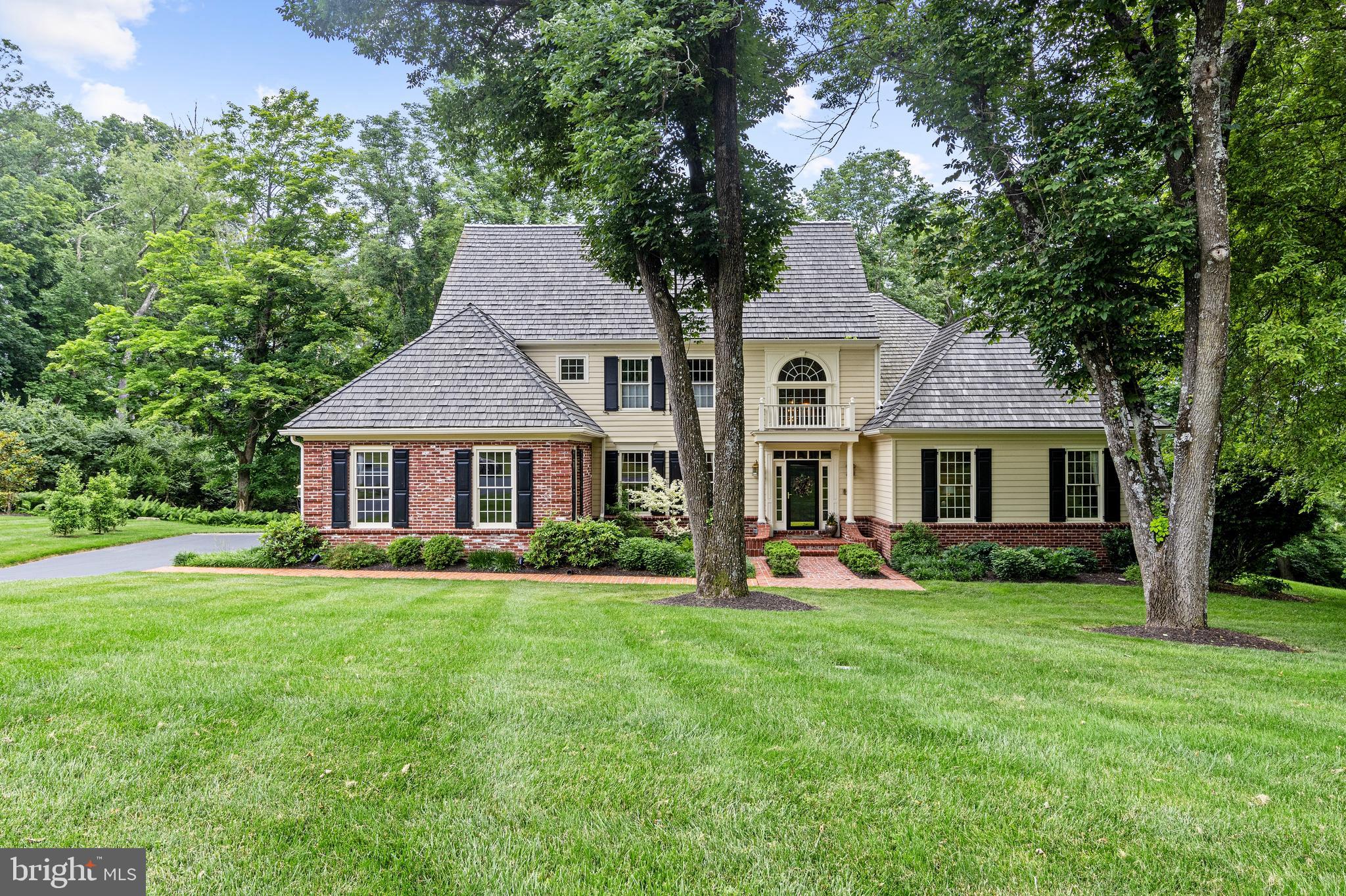 Discover a rare gem in Plumsock – this stately 2-story colonial, nestled in the horse country of Willistown township, offers a beautifully updated first floor primary suite. This 1994 charming custom built home of brick and wood exterior with a cedar shake roof is situated on a beautifully landscaped lot. The front entrance awaits you with a beautiful brick walkway, flanked with well-placed mature perennials. Step into the grand 2-story foyer and be greeted by amazing natural light, a neutral color scheme, and gleaming wood flooring that flows seamlessly throughout most of the first floor. An inviting office/den space with a wood fireplace, the formal dining room with a butler's pantry, and a striking 2-story great room with a floor-to-ceiling stone gas fireplace, custom built-in cabinetry, and tasteful carpeting create a vibe of timeless elegance.

The gourmet kitchen is a chef's delight, featuring granite countertops, stainless steel appliances, a double wall oven, and an island cooktop, with an adjoining eating area that opens to a delightful patio through several atrium doors. The side entrance includes a full laundry room and access to the attached double garage, with plenty of storage.

The luxurious main floor primary suite offers complete tranquility, featuring a cozy fireplace, private sitting porch, two walk-in closets with custom cabinetry, and a beautiful marble bath with a double vanity, walk-in shower, and jacuzzi tub. Upstairs, a spacious open loft area overlooks the foyer and family room, three additional bedrooms, one ensuite, and a convenient hall bath provide comfort and privacy.

The daylight, walk-out ready-to-be finished lower level offers endless potential to fit your lifestyle. Smart home features abound, including a state-of-the-art security system with remote operation, scheduling for heating and cooling systems, and control of door locks and interior/exterior lights. Newer HVAC system.
Don't miss out on the chance to make this ready-to-move-in home yours, nestled on a peaceful country road next to 72 acres of beautifully preserved woodlands. This home is not just a house; it's a testament to loving care.
