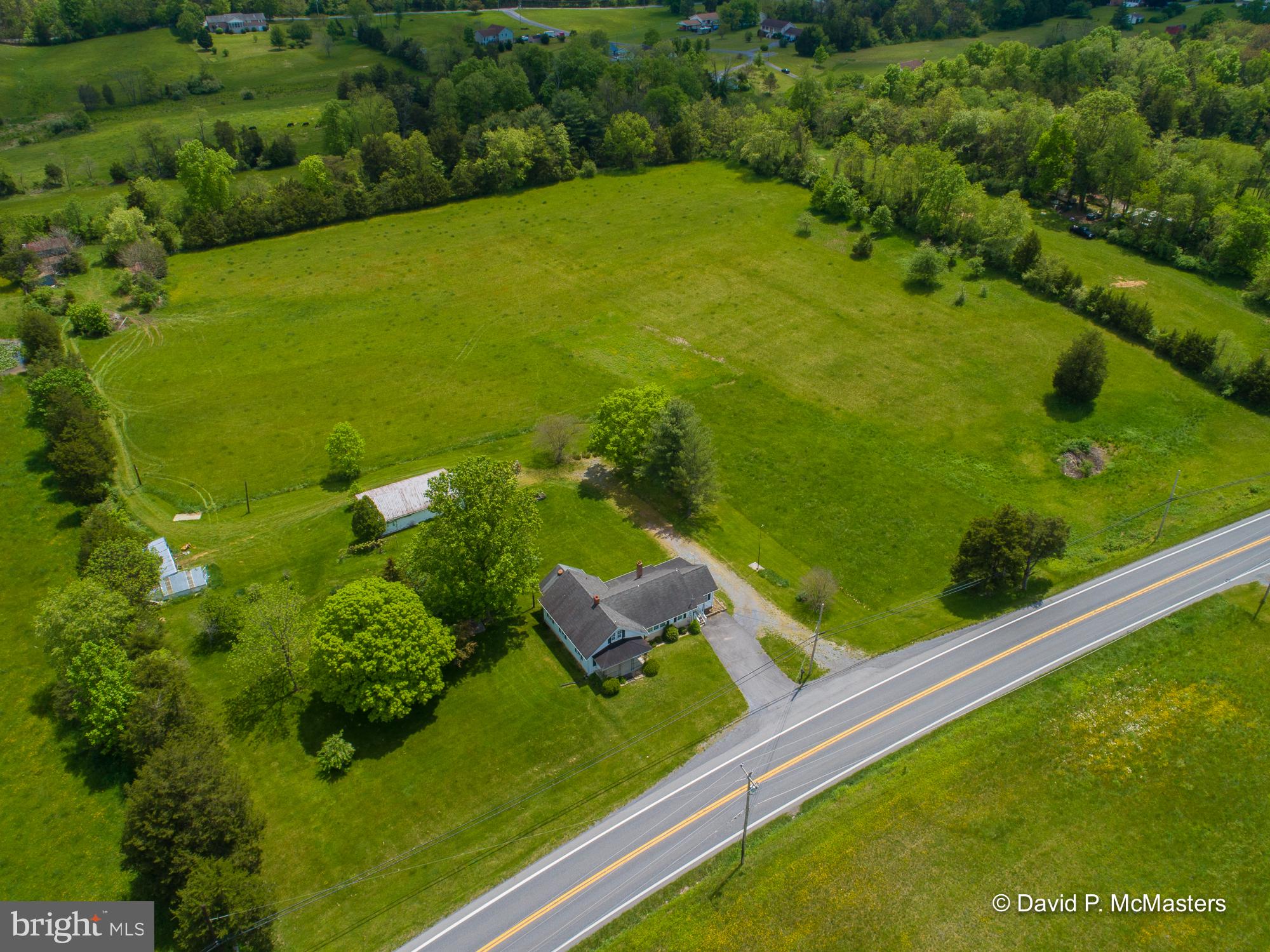 An absolutely gorgeous piece of land. Level and cleared.  So here's your farmette ready to go. Have animals, plant crops -- perfect spot for that.  The electrical system in the home was recently upgraded.  The home is perfectly livable and comfortable but the buyer may want to make some cosmetic upgrades -- that hasn't been done for a while.  The location - fronting Hedgesville Rd - is a great business location. The only restriction is that alcohol can't be sold.    2 lots totalling 8.76 acres. The home is on 3.76 acres. Live in that home while you build another home on the adjoining lot which is on 5 acres. Getting hard to find a home with this kind of acreage.