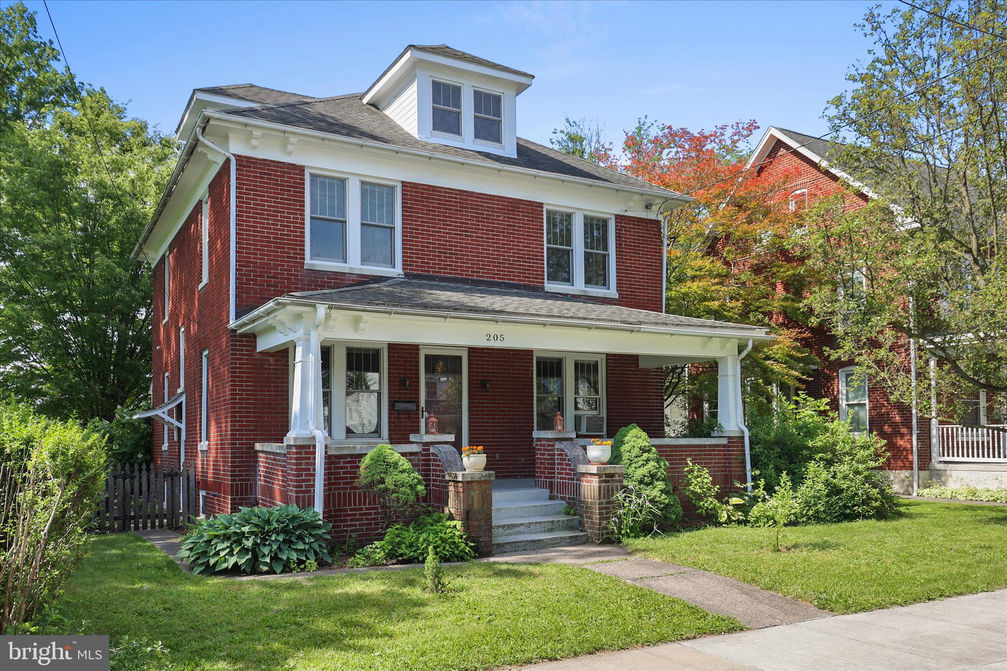 This stately red brick home sits on a spacious lot within the Gettysburg borough.  Close to shopping, restaurants, schools, medical facilities and of course, the Battlefield is nearby!   Upon entering the home, you enter the spacious foyer/receiving room,  large living room and dining room are all interconnected making this a wonderful home for entertaining.  The owners opened the wall between the kitchen and dining room to further enhance the open concept.  They even added a breakfast bar to enhance the experience and the kitchen hosts a pantry for convenience.  Just off of the kitchen is an added sunroom built by Gettysburg Construction.  The sunroom features Electric baseboard heat and built ins.
Please note that the third floor is finished!  Heated and cooled by a mini split unit, this space can best be used as an added bedroom, office and additional family room.  This would be a great space for company visiting your 'Gettysburg address' as well.
The setting  is host to lush greenery, beautiful perennials, a patio and a one car garage used as a workshop.  There is a gravel parking lot in the rear of the lot accessed by the alley.
The grand front porch of this home has plenty of space for your summer furniture to enjoy those summer evenings.