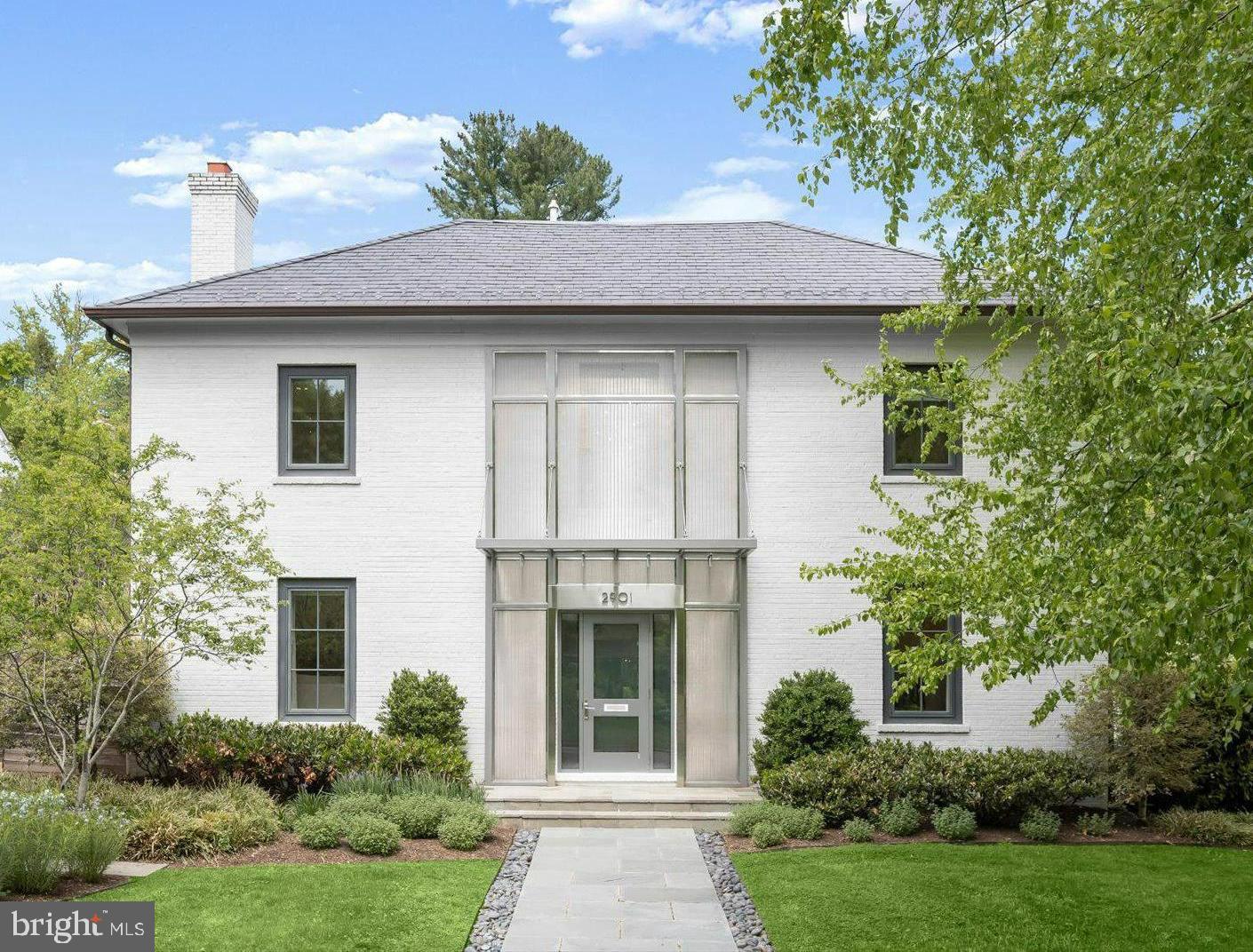 Stylish, reimagined brick center hall contemporary, with custom glass canopy/stainless steel woven mesh entry, boasts 5,300 sf of interior space on level .22 acre lot.  Suffused with natural light year-round, the exceptional floorplan provides excellent entertainment options for small to large gatherings.  A full renovation in 2011 almost doubled previous size and added a 47' lap pool, hot tub, slate patio, wood fencing and lush landscaping.  The bright chef's kitchen - with garden views from 4 glass door panels -  offers quartz countertops, stainless steel appliances, second sink and bar opens to the family/breakfast table area and sitting/media room.  Discrete frosted glass sliding doors access side entry mudroom/powder room.  The elegant foyer, lined with floor-to-ceiling custom shelves, provides stunning, unobstructed views to rear garden and circulation to separate living room with custom marble fireplace and separate dining room seating 12.  A curved entry stairwell with vintage iron balustrade, high tray ceilings, recessed lighting, custom built-ins and hardwood floors finish the main level.  The spectacular primary suite with cathedral ceiling features large sitting room and private outdoor balcony with glass railing.  The primary full bath offers two sinks, heated tile floor, walk-in shower, soaking tub and exceptional walk-in closet.  Three additional bedrooms with double-entry full bath complete second level.  Charming and quiet fifth bedroom on the third level includes a dressing/study area and third full bath.  Finished lower level has expansive recreation space with home gym, bonus room, fourth full bath, laundry room, plentiful storage and closets.  Many amenities include Sonos, EV charging station at side entry, and tasteful hardscape with exterior lighting.  Well-maintained with many recent updates and new roof in 2020.  By Appointment.