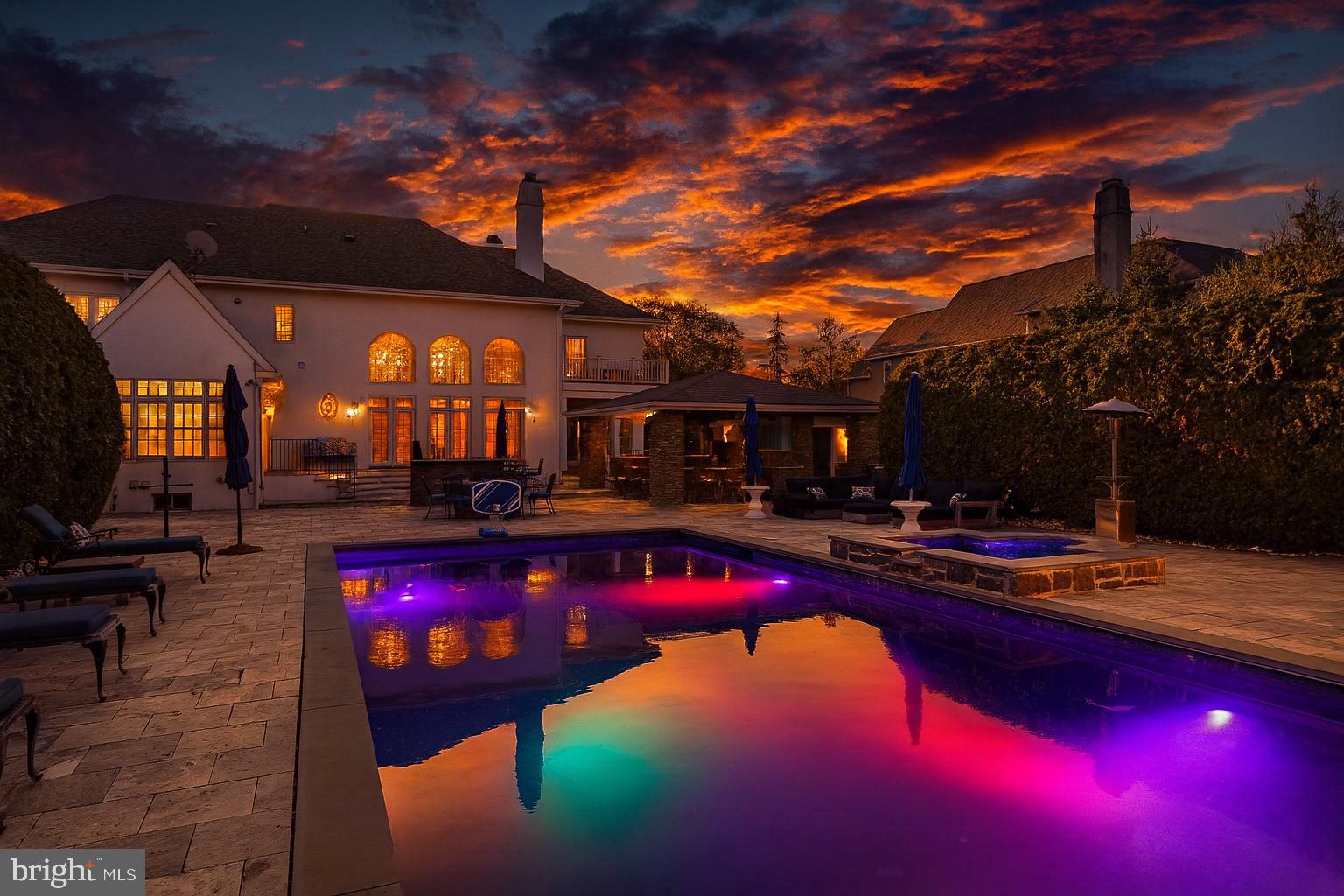 A Masterwork of Refined Living in Prestigious Wayne, PA. Set amid the storied Main Line, this exceptional residence embodies the very finest in East Coast luxury living. Positioned on nearly an acre in the coveted Whitegate enclave, the home offers an impressive 7,640 total square feet of meticulously curated interiors and world-class amenities—creating a sanctuary where sophistication, comfort, and architectural excellence converge.

From the moment you arrive, the home’s elevated design reveals itself. Custom Italian Bella Porta Miraquadra Series doors usher you into a world of craftsmanship and impeccable taste. At its heart lies a chef’s kitchen conceived for both culinary artistry and everyday elegance—showcasing executive-grade custom cabinetry, Silestone White Zeus countertops, and a full suite of Sub-Zero, Wolf, and Bosch appliances. A grand 1½-inch butcher-block island stands as the centerpiece, outfitted with a Rohl farmhouse sink, artisan faucets, ambient pendants, a statement chandelier, and luxe details such as an Insta-hot and filtered water system and pot filler. Mosaic glass tilework and custom seating complete this remarkable culinary environment.

Entertaining unfolds with ease in the gracious living and dining spaces, each enhanced by bespoke built-ins and designer window treatments. A richly appointed office provides an inspiring setting for work or reflection, while the sun-splashed conservatory offers a peaceful vantage point to take in the home’s serene surroundings. Three fireplaces—including one positioned poolside—infuse the home with warmth, ambiance, and architectural character.

The primary suite is a haven of pure indulgence. Custom wardrobe cabinetry, a tailored dressing table, and a private balcony overlooking the pool create an atmosphere of serene elegance. The spa-inspired ensuite bath boasts heated marble floors and a custom steam shower with multi-massage heads—an everyday retreat reminiscent of a boutique luxury spa. Secondary bedrooms continue the home’s elevated aesthetic with dual vanities and exquisitely finished custom showers.

For the automobile connoisseur or hobbyist, the property includes an attached 3-car garage paired with an additional two-story, 2-car structure. Outdoors, the estate reveals its resort-style amenities and a series of exquisite upgrades designed for luxurious living and exceptional entertaining. The expansive exterior patio is anchored by Silver Tumbled Travertine paver decking and elevated by Dolce Vita leathered marble counters. Artisanal Vihara Ehex Silk and Falling Star Sleek Ceylon wall tiles create a striking visual backdrop, while a GE Monogram grill and burner, custom built-in fireplace, and integrated pizza oven offer an unrivaled alfresco culinary experience. A sophisticated pool with retractable cover, a well-appointed pool house, and a handcrafted stone bar further enhance the outdoor oasis.

Completing the grounds is a private park complete with tennis and basketball courts, a playground, and manicured green space for recreation and relaxation. The heated granite cobblestone driveway adds both elegance and functionality, ensuring a grand approach in every season.

The lower level extends the home’s entertaining prowess with a custom bar—enhanced in 2020 with new appliances—a climate-controlled wine cellar, dedicated home gym, and an immersive theater room designed for cinematic experiences.

Offering five spacious bedrooms and six luxurious baths, this residence is the epitome of harmonious living. Additional comforts include central air, a stately fireplace, and a thoughtfully planned laundry suite.

1053 Whitegate Road stands as a statement of luxury, lifestyle, and legacy—an extraordinary opportunity to acquire one of Wayne’s most distinguished properties in the heart of the Main Line.