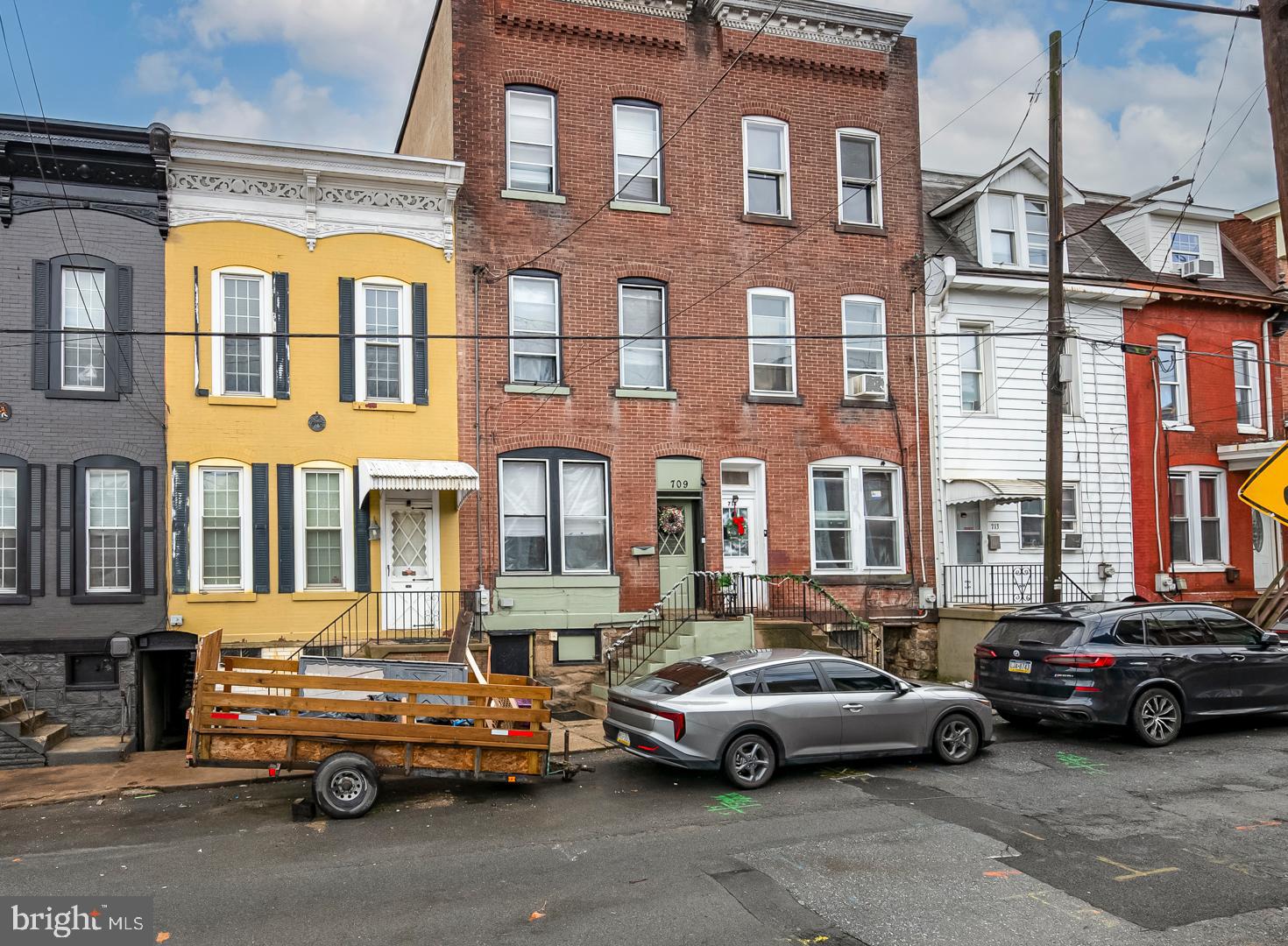 This spacious three-story brick home with six bedrooms and two and a half baths is full of classic charm with its high ceilings, beautiful natural woodwork, and hardwood floors throughout.  The main level includes a formal living room, dining room, and a kitchen with some granite countertops and a tiled floor.  There is also a convenient half bath on the main level.  The second floor has three nice-sized bedrooms and a full bath.  The third floor includes three additional bedrooms and a full bath, providing flexible living space that can be used for guests, a home office, a playroom, or extended living needs.  Several bedrooms have been freshly painted and have large windows that provide natural light.  A full basement with a laundry area with cabinets and storage space.  The property has economical gas heat that’s easy on the budget.  Off-street parking is available across the street for $40 per month.