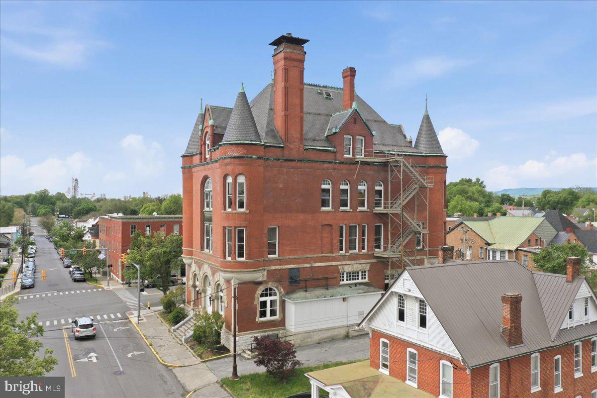 Located in the heart of downtown Martinsburg, the former United States Courthouse and Post Office at 125 S Maple Avenue presents a rare opportunity to reimagine one of the city’s most iconic historic properties. Encompassing approximately 25,024 (+/-) square feet across three levels plus a basement, this stately red brick and stone building features remarkable architectural character, including original wood flooring, grand courtroom spaces, cast-iron columns, marble accents, fireplaces, and abundant natural light from oversized windows. Positioned within the Historic Preservation District at the prominent corner of West King and South Maple Streets, the property offers exceptional visibility and walkability to Martinsburg’s downtown attractions, businesses, and cultural destinations. The building includes an existing elevator shaft, on-site parking, a walk-in vault, expansive open areas, and flexible floorplans that lend themselves to adaptive reuse opportunities. With its historic charm, commanding presence, and substantial interior volume, the property is uniquely suited for a transformative vision such as a national discovery museum, educational institution, nonprofit headquarters, cultural center, or mixed-use community destination. This is an extraordinary opportunity for mission-driven organizations to establish a flagship presence within one of West Virginia’s most recognizable historic landmarks.
