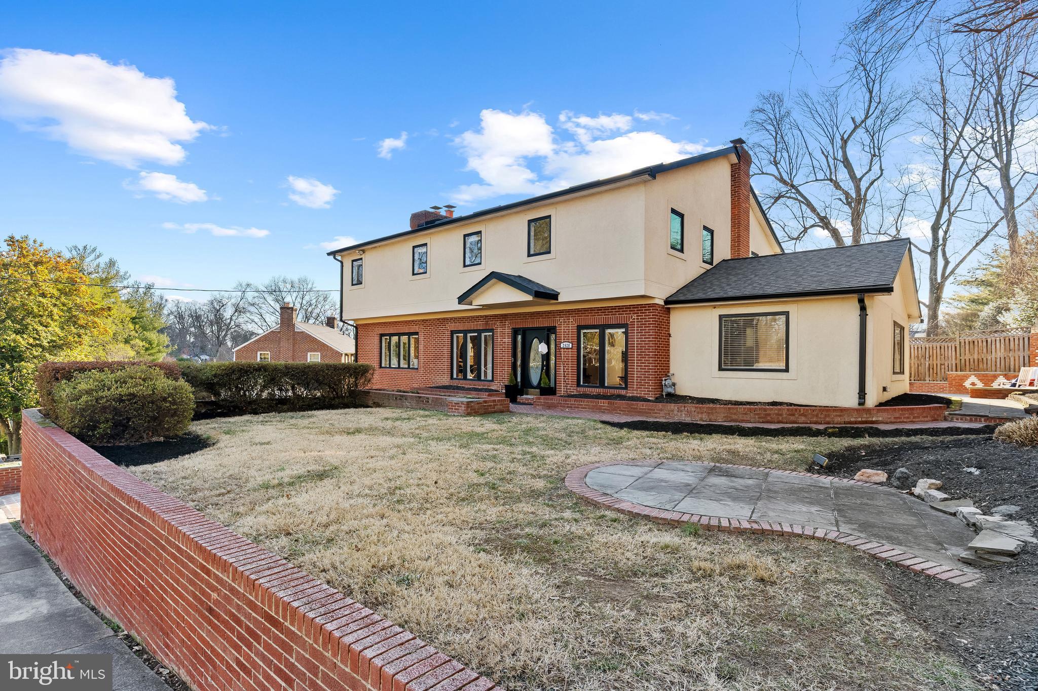 An enticing find for those seeking expansive space and distinctive character,  this 3,216sf 4-bedroom 3.5-bathroom contemporary colonial was custom-built in 1999 by a Danish craftsman with the goals of showcasing timeless, classic durability and achieving flawless circular flow!   The brick archways, exposed-brick walls,  four fireplaces, six skylights, and vaulted ceilings exhibit a one-of-kind quality.  The inviting  foyer beckons one through an archway to the embassy-sized living room, anchored by a custom fireplace and oversized windows.  Flowing from the living room is the open, gourmands' kitchen with Nero Marinace granite counters,  white cabinets and an eat-in island.  This chef's kitchen opens to the entertaining-sized dining room,  featuring a fireplace and an approach to a Great Room/gathering room with vaulted ceilings. This Great Room, where family and guests can lounge and be entertained, leads through French doors  to a palatial,  pool-sized bricked patio - an outdoor party central - complete with two seating areas and an outdoor fireplace/grilling pit.  On the second floor are four bedrooms, including a sumptuous primary bedroom suite with a fireplace,  a sitting/study/office area,  brand-new, white Euro-modern bathroom and two walk-in closets!  The basement is walk-out, offering a generous media/games/fun room, a study/den, second kitchen and newer, contemporary bathroom. In addition to the attached garage is driveway space for parking four-plus cars.  There are two laundry hook-ups, on the second floor and in the basement. 
The convenient location is short minutes to Founders Row and Broad St retail, dining and entertainment plus near West Falls Metro, access to I66 and I495, McLean and Tysons Corner, and an easy commute to DC!