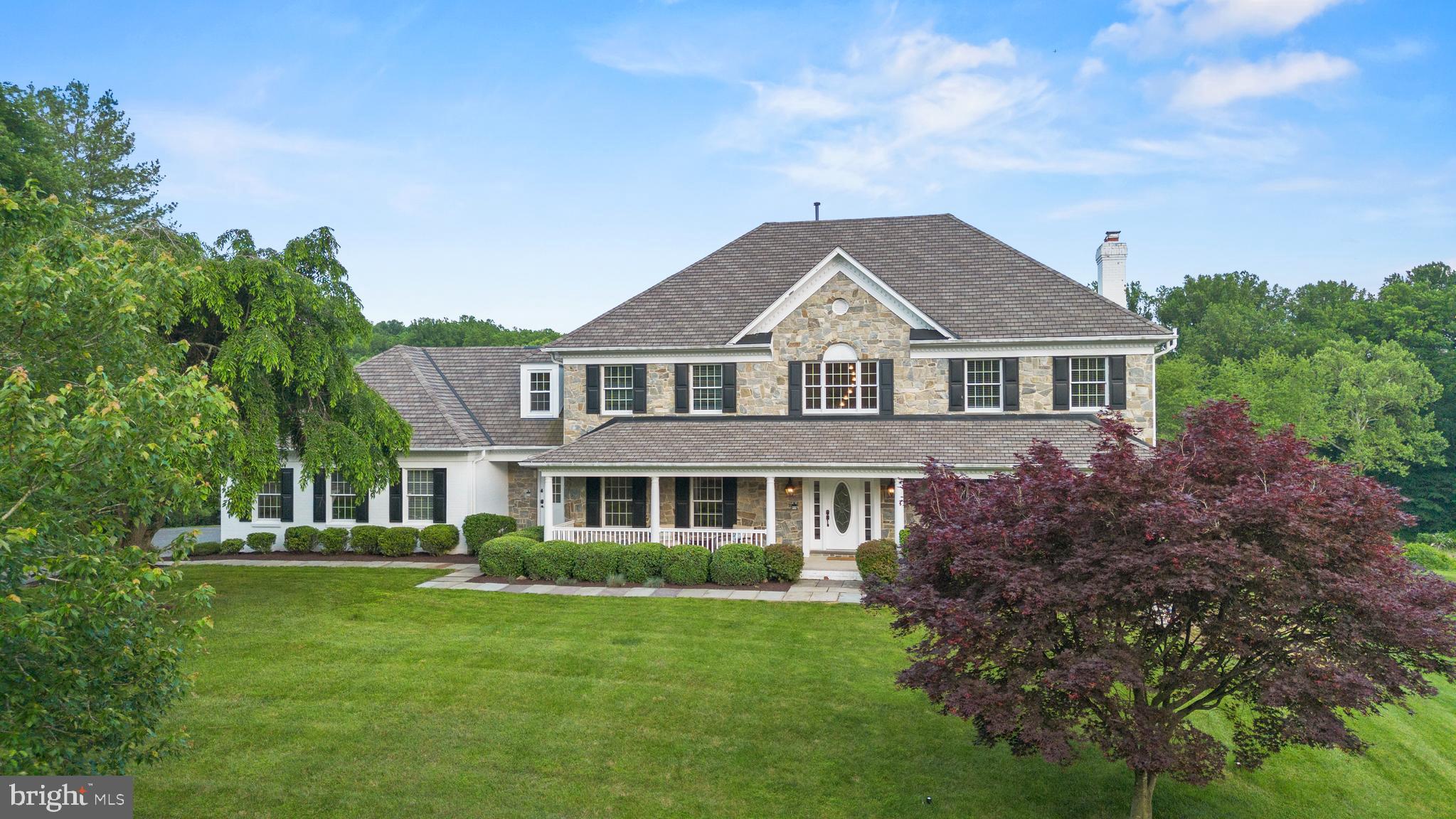 Backing to a nature preserve and nestled into a bucolic setting, this timeless stone-front colonial has undergone extensive renovations and appointed with every amenity for luxury living.  Introduced by an inviting front porch and stone walkway, the 6 bedroom, 4 full and 2 half-bath home encompasses a fabulous open, circular floor plan where the carefully curated finishes are of the highest quality.  New designer counter surfaces in two kitchens and every bath, designer chandeliers and pendants, refinished main and upper-level flooring, and new door hardware offer a hint of the whole-house improvements that the owners recently added.  With a perfect balance of formal and casual living space, the home features an expansive dining room, an executive-size home office with built-ins, a family room with a stone fireplace and the kitchen of any chef’s dreams.  Finished in a striking palette of navy and white cabinetry, the kitchen features a substantial island with seating for four, Thermador and Viking appliances and a perfect layout for entertaining on any scale.  From the casual dining area or the family room, doors open to an expansive deck that overlooks the grounds and heated pool.  There are two powder rooms on the main level, a finished mudroom and access to the oversized three-car garage with new custom cabinetry.  Perfect for modern living, there are 4 bedrooms, 3 beautifully designed baths and a laundry room on the upper level.  Tray ceilings, recessed lighting and a jet and rainfall shower system are highlights of the primary suite.  Every bedroom has ample space for furnishings and clothing, and the baths are all modernized with new  glass shower doors and sinks.  Absolutely incredible, the walk-out lower level has new luxury vinyl flooring, a huge family room with a gas fireplace, and a home theater with state-of-the-art A/V equipment, reclining chairs and ambient lighting.  For the multi-generation home buyer or one looking for a private in-law suite, the lower level of this home is unparalleled: the kitchenette is complete with a microwave and refrigeration and the spacious bedroom has access to a full bath and personal washer/dryer!  The premium lot this home enjoys sets the perfect tone for the outdoor space, which is equally sublime.  Mature trees and flowering gardens add the perfect complement to the custom-shaped heated pool, while the adjoining nature preserve promises and protects a lifetime of privacy.  From the oversized three-car garage with EV charging station, to the HVAC systems with wifi-enabled controls to the “Closets by Design” primary suite enhancements, this home elevates the concept of form and function to an entirely new level!
