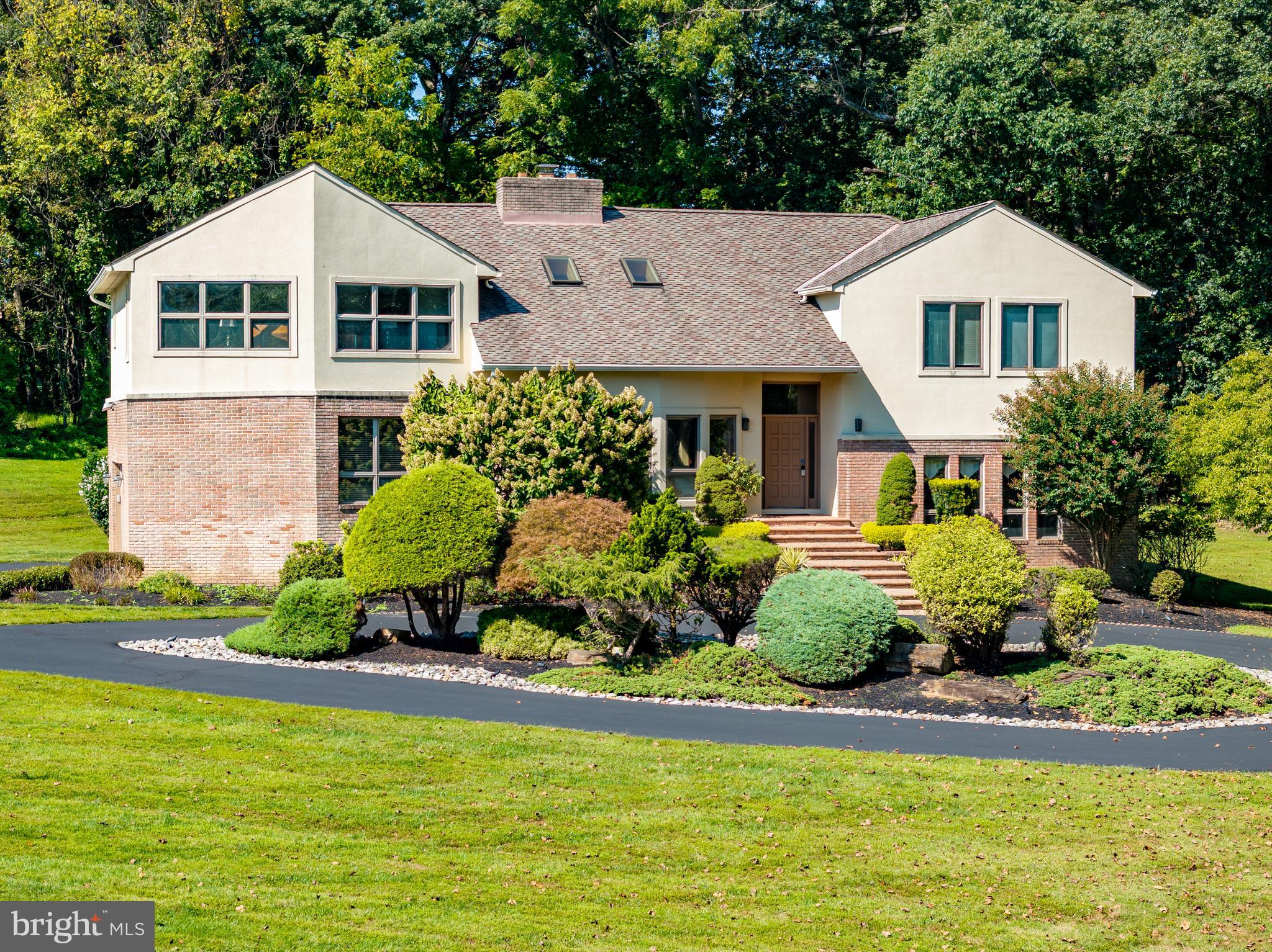 Welcome to your private retreat in one of the area’s most sought-after communities! This one-of-a-kind custom home offers a truly unique living experience that will make you feel like you are on vacation every day. Featuring five bedrooms and three full bathrooms spread across four thoughtfully designed levels, this home provides generous space, flexibility, and privacy for every lifestyle. Nestled on over 4 acres of beautifully landscaped grounds that back to woods, this setting offers tranquility and seclusion while still being conveniently located near everything you need. From the moment you step inside, you are greeted by soaring two-story vaulted ceilings with wood planks, skylights, and an abundance of natural light throughout. The main level features an impressive front living room with a stacked-stone fireplace that is double-sided and shared with the kitchen, creating a warm, welcoming ambiance. A wet bar area off the living room is perfect for entertaining guests. The expansive eat-in kitchen is a chef’s dream, fully equipped with stainless steel appliances, granite countertops, ample storage space, and a dining area with access to the deck that overlooks the backyard and woods. Completing this level is a laundry room with a pantry and access to the two-car garage. Upstairs, the primary bedroom suite is a true escape with a cathedral ceiling, a luxurious en-suite bathroom that includes a jetted tub and walk-in steam shower, along with a large walk-in closet and dressing vanity area. Three additional bedrooms and a second full bathroom complete the upper level. A few steps down from the foyer, the lower level includes a spacious family room and a fifth bedroom with a door to the third full bathroom. A versatile bonus room on this level is ideal for an office, playroom, or even another bedroom. Down a few more steps, the basement level provides even more flexibility with a recreation room and a large office with built-ins. A large utility room adds more storage space. Enjoy spending time outside on the spacious deck with an expansive backyard that has space for everyone’s outdoor activities. Don't miss this rare opportunity to own a spectacular property that combines architectural distinction with a serene, resort-like atmosphere. Additional highlights include zoned heating and cooling systems, two water heaters, and a generator.
